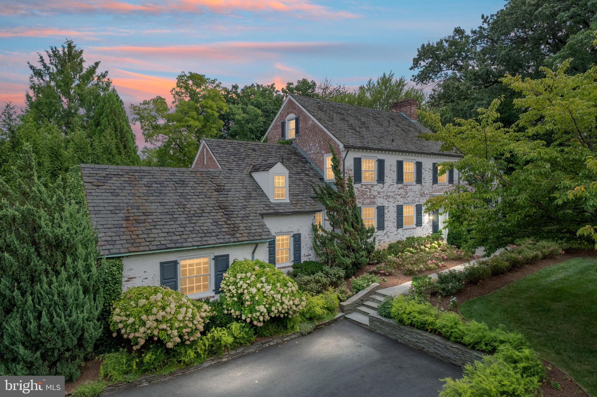 ***Open House canceled - contract accepted***This beautiful Country Club Hills estate is situated on 0.65 acres of land, surrounded by mature trees and professional landscaping.  This exquisite, whitewashed brick colonial has been meticulously renovated and expanded, offering over 6,000 square feet of living space, and striking the perfect balance between grand entertaining areas and comfortable family living spaces. One of the crown jewels of Arlington homes that has very rarely come to market, the home is situated within walking distance to Washington Golf and Country Club.  It offers beautiful, private, and large rear grounds that are ideal for entertaining and family relaxation.
 
The stately front entry opens to a warm and elegant foyer with a handsome staircase and heated oak parquet floors that are featured throughout the house. The foyer leads to a double-sized living room that offers a beautiful central fireplace with marble surround, hand-crafted crown molding, custom built-ins, and light-filled bay windows that overlook the rear grounds.
 
The grand dining room, adorned with an oversized bronze chandelier, comfortably accommodates dinner parties for 12 or more guests. A sunlit game room and bar adjoin a striking family room with coffered ceilings, an oversized fireplace, reclaimed antique pine floors, a wall of windows, and French doors that open to a welcoming stone terrace.
 
The expansive eat-in kitchen features ample space and storage as well as the comfort of heated tile floors and leads to the dining room as well as a back staircase providing access to a private au pair ensuite on the second floor.
 
A stunning wood-paneled library with its own fireplace offers the opportunity for quiet reading or undistracted professional work from home.
 
A spacious first-floor guest bedroom with an adjoining full bathroom, as well as a half bathroom, complete the main level.
 
Upstairs, this home offers truly comfortable living with five large bedrooms and four bathrooms, including the luxurious primary suite with a sitting area, spacious closets, and a marble bath.  An oak stairwell provides access to the finished third level, with a charming window seat, and is ideal for use as an office or playroom. 
 
The lower level, accessible via two sets of staircases, features a spacious recreation room that is ideal for watching sporting events and movies, an exercise room that incorporates a fourth fireplace and a gorgeous marble-tiled half kitchen that includes two beverage refrigerators, sink, custom-built cabinetry, granite counters, and a washer and dryer.  Additional amenities on the lower level include a wine storage room and a half bath.
 
The private exterior offers a spacious flagstone terrace perfect for entertaining and is framed with a stone sitting wall, overlooking a sweeping grass yard, which could accommodate a pool, a canopy of mature Oaks and Ginkgo trees as well as an adorable custom cedar-shingled playhouse for children. The manicured front grounds of this showcase property are with accentuated with landscape lighting in the evening and numerous cherry trees that are stunning when in bloom.  The property includes a three-car garage as well as both front and rear parking areas. Ideally located, this exceptional residence provides easy access to Georgetown, downtown DC, several airports, and Washington Golf and Country Club.