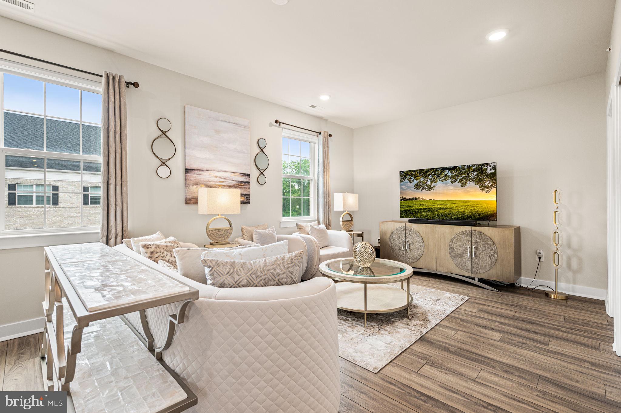 Set in a quiet pocket of Waterside just steps from the water, this North-East facing end-unit townhome lives like a private retreat, and shows like a model with sophisticated elegance. The interior is bright and polished, with new luxury vinyl plank flooring, white shaker style cabinetry, and granite counters that give it a clean polished designer feel. Throughout the home, ample closet storage is available in every room. The corner position pulls in extra light, and the layout offers a real range of possibilities: a main level pairs kitchen and dining with a comfortable spacious living room, while an entire upper floor opens up to a second living area and a generous deck. A private elevator offers easy garage to main level access. A convenient laundry area on the main floor adds everyday practicality, saving you time and effort. The primary suite on the main level is a serene retreat, featuring two generous walk-in closets and a luxurious en-suite bath. The upstairs guest bedroom holds a quiet corner, plus a flexible loft bonus space for office, guest room, or lounge. Outside, walking and biking paths trace the waterfront to a playground and a well-loved on-site café; the HOA handles common areas, lawn care, trash/recycle, and snow removal. Waterside offers easy access to I-95 and New Jersey and is only 12 miles from Center City Philadelphia, making commuting and weekend adventures incredibly convenient.