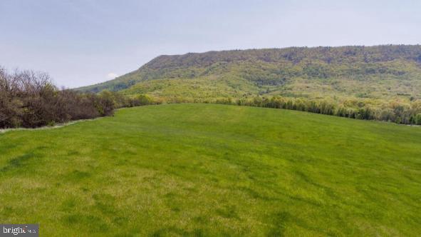 MULTI-MILLION DOLLAR VIEWS from this 3.533 acre hilltop lot. The owner has released for sale, acreage from one of the most coveted and scenic locations in Strasburg (some say all of Shenandoah County)….…Sandy Hook Farm.     
The elevation of this lot provides both mountain and sweeping valley views, where you’ll feel like you can practically reach out and touch Signal Knob.   Have your blueprints ready as the property is cleared, a Certification Letter for a well and 4 Bedroom Alternative Septic is on file and electricity is already onsite and installed.   Break ground now and prepare to watch the seasons change including the leaves turning to brilliant colors in the fall from the vantage point of your new home.
Surveyors have staked the property corners and well and septic sites.   Covenants are attached and were recently amended to allow for Short-Term Rental use.  Build your primary residence or a second home with option to generate income while you are away! 
Elementary, Middle, and High schools are within a 2 mile radius.  Outdoor enthusiasts will love the proximity to the Shenandoah River, fishing, kayaking, hiking, biking, and all things nature.   Historians will be drawn to an area rich in history and tradition.   The Shenandoah Valley is a growing area for tourism.   Wineries, restaurants and local culture abound.   
This location offers the best of rural living while remaining convenient to commuter corridors I81 (4.2 mi), I66 (10 mi), Washington DC (60 mi), area industrial parks and major employers including Mercury Paper, Thermo-Fisher Scientific, Valley Health System, Navy Federal Credit Union, FEMA, Axalta, Rubbermaid, and Amazon Distribution to name a few.   Air travel is also convenient as the area is served by 3 major airports, Dulles International, Reagan National, and BWI airports.  
Whether you’re relocating to the area for career or retirement or have lived close-by all your life, acreage on Sandy Hook Farm offers the place to build and live your dream!