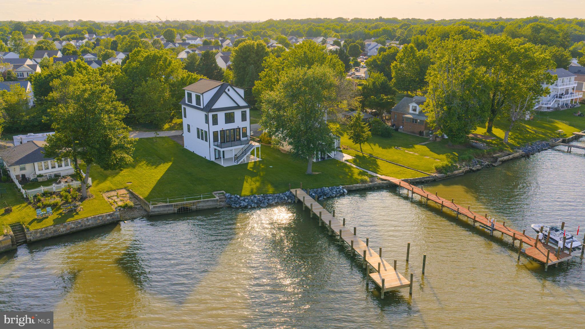 Welcome to your stunning new construction waterfront home on Back River, offering breathtaking panoramic water views from nearly every angle. Thoughtfully designed with coastal elegance in mind, this exceptional 4-bedroom, 3.5-bath residence showcases high-end finishes and craftsmanship throughout. The heart of the home is a chef’s kitchen featuring premium appliances, custom details, and an open-concept layout that flows seamlessly into the spacious living and dining areas. Expansive windows and huge double doors fill the home with natural light while framing the spectacular waterfront scenery. Step outside to oversized decks built for entertaining and relaxing, all overlooking the water. A 100-foot pier with deep water access provides the perfect setup for boating enthusiasts, while the generous yard offers ample space for cookouts, gatherings, and outdoor enjoyment. Move into this remarkable waterfront retreat with complete peace of mind—every detail is brand new, combining luxury, comfort, and timeless coastal charm in an unbeatable waterfront setting.