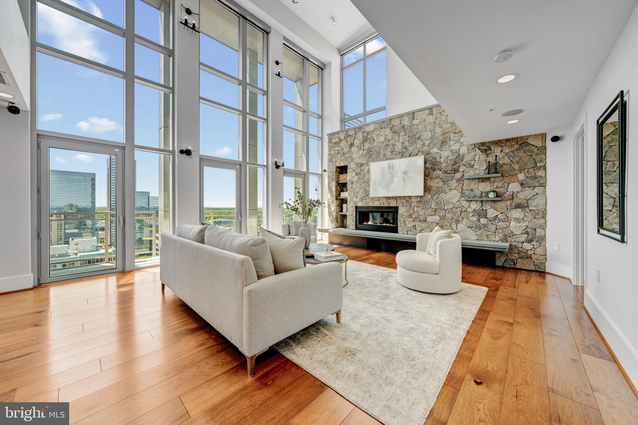 A rare opportunity to own a two-level penthouse in the coveted West Tower at Midtown—Reston Town Center’s premier luxury address—offering nearly 3,000 square feet of elevated, low-maintenance living designed for those who demand both sophistication, privacy, and efficiency. With 4 bedrooms, 3.5 baths, expansive private terraces, and an exceptional 5 dedicated parking spaces, this residence delivers the scale of a single-family home with the ease of a full-service, lock-and-leave lifestyle. 

Soaring two-story ceilings and floor-to-ceiling windows define the main living space, flooding the home with natural light and creating a dramatic, modern aesthetic. The open-concept layout seamlessly connects the living and dining areas to a private balcony—ideal for entertaining or unwinding between travels. The chefs kitchen is built for both performance and style, featuring a large island, premium appliances, extensive cabinetry, and a built-in workspace—perfect for remote work, tracking your portfolio, or managing business on the fly. A secondary lounge or dining area with a beverage fridge adds flexibility for hosting or everyday living. 

Upstairs, the penthouse experience continues with vaulted ceilings and two expansive terraces offering elevated views and multiple outdoor living zones—perfect for morning coffee, evening cocktails, or private downtime above the city. The primary suite functions as a true retreat, complete with a spa-inspired bath, dual vanities, soaking tub, and frameless glass shower. Additional bedrooms on the main level provide versatile space for guests, a home office, or a private fitness setup. 

Smart, integrated features—including built-in audio, remote-controlled shades, and modern lighting—enhance comfort and convenience while maintaining a clean, contemporary design. 

Midtown delivers a full-service, executive-level lifestyle with 24/7 concierge, secure access, and resort-style amenities: a heated outdoor pool and hot tub, state-of-the-art fitness center, private theater, conference facilities, guest suites, and elegant entertaining spaces. On-site dining and package handling ensure seamless day-to-day living, while the vibrant energy of Reston Town Center—top-tier restaurants, nightlife, and transit—is just steps away.  10 minutes to Dulles International Airport.