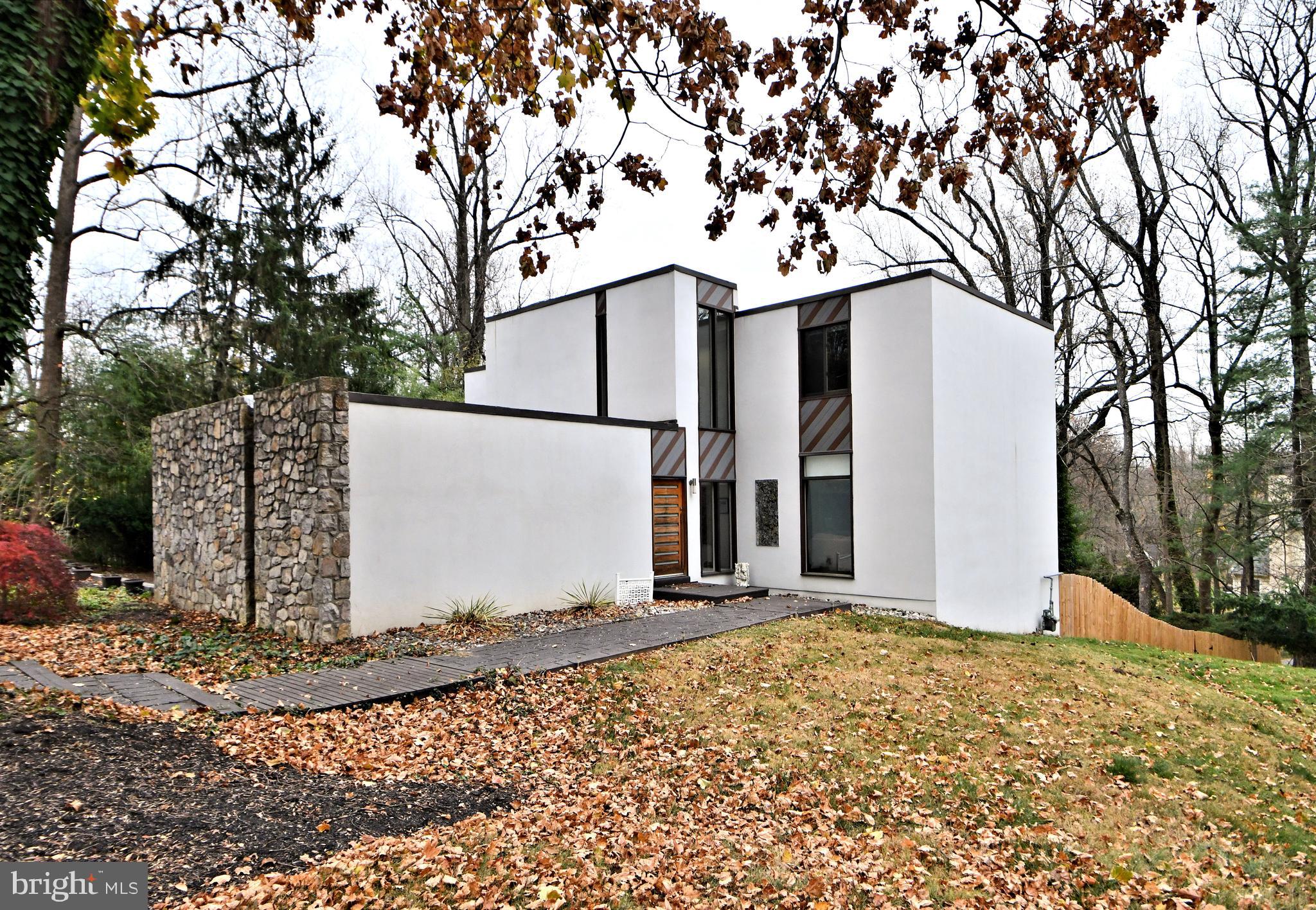 You won't want to miss this custom-built , contemporary home. Commissioned by the former owner of Rock Rose Estate, and designed by Edward E Robinson,  no detail was spared in the home's design, construction and setting.  Built using Stone and Stucco on just shy of an acre on a large corner lot of a cul-de-sac street,  the home is  surrounded by beautiful old trees and lush plantings  offering privacy,  lushness and convenience. Be sure to take the short drive to the center of Wayne, the "hub" of the Mainline, where you'll  be drawn to its walkability to shops, restaurants, and the train line into Philadelphia.  King of Prussia Mall and town center are not too much further of a drive.  Approach the home from the street and take in the large circular drive and custom front door.  Inside you are  greeted by a stunning two-story foyer with wonderful natural light and  a  porcelain tile floor. The center hall is situated conveniently between the large living/family room, the formal dining room, and the kitchen.  All of these rooms have huge windows  and sliding doors providing  panoramic views and  access to your backyard oasis,  while bathing the home in natural light from dawn until dusk.  Just to your left you will notice a striking custom-built staircase that the current owners had imported from Italy. It suits the home like a work of art and glistens both day and evening with its fabulous "low-lighting".  Imagine the entertaining you will do in the wonderful flow and setting of this home. You will  see yourself spending  many hours in the fabulous upgraded  family kitchen.  From the huge deep cabinets and drawers to the high-end stainless appliances, and sleek quartz counters you will be inspired to whip up fabulous meals, and/or sip wine or coffee while sitting by a cozy fire and soaking in the sun's warm rays.  A convenient pantry sits just off the kitchen with another huge refrigerator, sink, and counter, and adjacent  garage access.  Both the dining and living rooms are large enough to hold today's larger scale dining and living room furniture.  All the bathrooms are luxuriously updated including a convenient  powder room on the main level. The  well-designed primary  suite  offers spa-like luxury and serene privacy.  You will find a convenient laundry, large window,  his& hers custom-clad walk-in closet, and a gas fireplace. The ensuite bath is pure bliss with a bright skylight,  huge rainfall shower,  whirlpool tub for two, and heated towel rack.  You will find it hard to leave this space! There are three  remaining spacious bedrooms that feature hardwood floors, large windows, closets, and even a  built-in bookcase in the  current office. The upgraded hall bath will a magnet for family and guests alike with its huge spa-like shower, double vanity, and wonderful skylight. Heading back down to the walkout lower level of the home you'll find a full kitchen, a full bathroom with large washer/dryer combo, a family room, and two additional rooms that can serve as bedrooms, or flex rooms. This living area provides additional access to your fabulous backyard oasis. Imagine family gatherings and peaceful days by the inground pool surrounded by lovely landscaping and the striking tiered decking. as you can see,   every inch of this fabulous home has been well thought out and constructed.  Space, luxury, and convenience to  suit a growing family or entertaining enthusiasts.  Families will appreciate the award winning Radnor schools.  Don't miss your chance to own this wonderful home in this sought-after location.