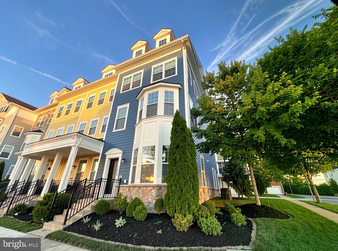 Stunning end-unit townhome offering over 2,400 sq ft of living space and one of the largest floorplans in the community! This beautifully maintained home features 4 bedrooms, 2 full baths, 2 half baths, and an open-concept layout with expanded living areas on every level. The entry level includes a spacious foyer, private office, flexible recreation/workout space, storage room, and oversized 2-car garage. The main level showcases a gourmet kitchen with granite countertops, upgraded cabinetry, stainless steel appliances, a large center island, and a spacious dining area that opens to the light-filled family room. The upper level features a luxurious primary suite with walk-in closet, dual vanities, and oversized shower, plus two additional bedrooms, a full bath, and convenient bedroom-level laundry. The top floor offers a versatile fourth bedroom, loft, recreation room, or home office with a private half bath and access to a rooftop terrace. Additional highlights include custom extra windows and blackout blinds throughout the bedroom level. Ideally located within walking distance to trails, parks, restaurants, shopping, community pools, and clubhouses, with easy access to major commuter routes. A rare opportunity combining space, style, and convenience! Images have been virtually staged for illustrative purposes.