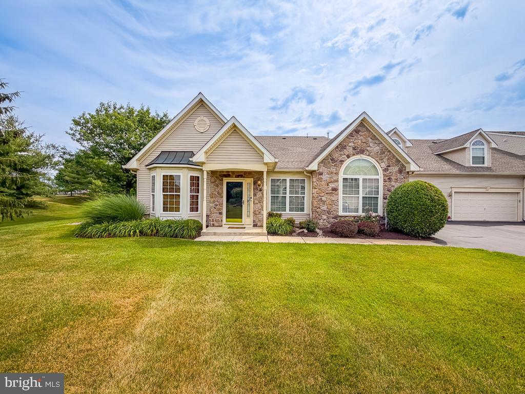 Welcome to this exceptional Thornhill model in the highly sought-after Villas at Shady Brook, one of Bucks County's premier active adult communities, where exceptional amenities and low-maintenance living come together in this spacious 3 bedroom, 3 bath carriage home on a coveted back lot. A covered front entrance welcomes you into a bright foyer accented by gleaming hardwood flooring that extends throughout much of the main level. The elegant living room flows seamlessly into the formal dining room, where a soaring vaulted ceiling creates a dramatic sense of openness and provides the perfect setting for entertaining family and friends. The well-appointed kitchen offers abundant cabinetry, granite countertops, a breakfast bar, and a spacious breakfast area. A custom built-in beverage refrigerator adds both style and convenience, enhancing the kitchen for everyday living and entertaining. Open to the kitchen, the impressive family room is highlighted by a soaring cathedral ceiling, a gas fireplace, and an abundance of windows that fill the space with natural light. Just beyond, the inviting sunroom opens to a private patio overlooking a spectacular tree-lined backdrop. Perfectly positioned on one of the community's most coveted homesites, this exceptional property backs to mature trees, offering a rare combination of privacy, tranquility, and picturesque views that make this location one of the finest in the Villas at Shady Brook. The spacious first-floor primary suite is highlighted by an elegant tray ceiling, creating a relaxing retreat complete with a generous walk-in closet and a private bath featuring dual vanities, a soaking tub, and a separate shower. A second bedroom and full hall bath complete the main level, while the well-appointed laundry room offers cabinetry, a utility sink, and convenient access to the attached two-car garage. Conveniently accessed through the laundry room, the second level offers a private retreat complete with a versatile loft, third bedroom, and full bath, providing the perfect space for overnight guests while also lending itself beautifully to a home office, den, or hobby area. Tasteful neutral décor, generous room sizes, and a thoughtfully designed floor plan make this home ideal for both comfortable everyday living and effortless entertaining. Residents of the Villas at Shady Brook enjoy an exceptional resort-style lifestyle with a magnificent clubhouse, indoor and outdoor pools, fitness center, tennis and pickleball courts, walking trails, and a vibrant calendar of clubs, activities, and social events.