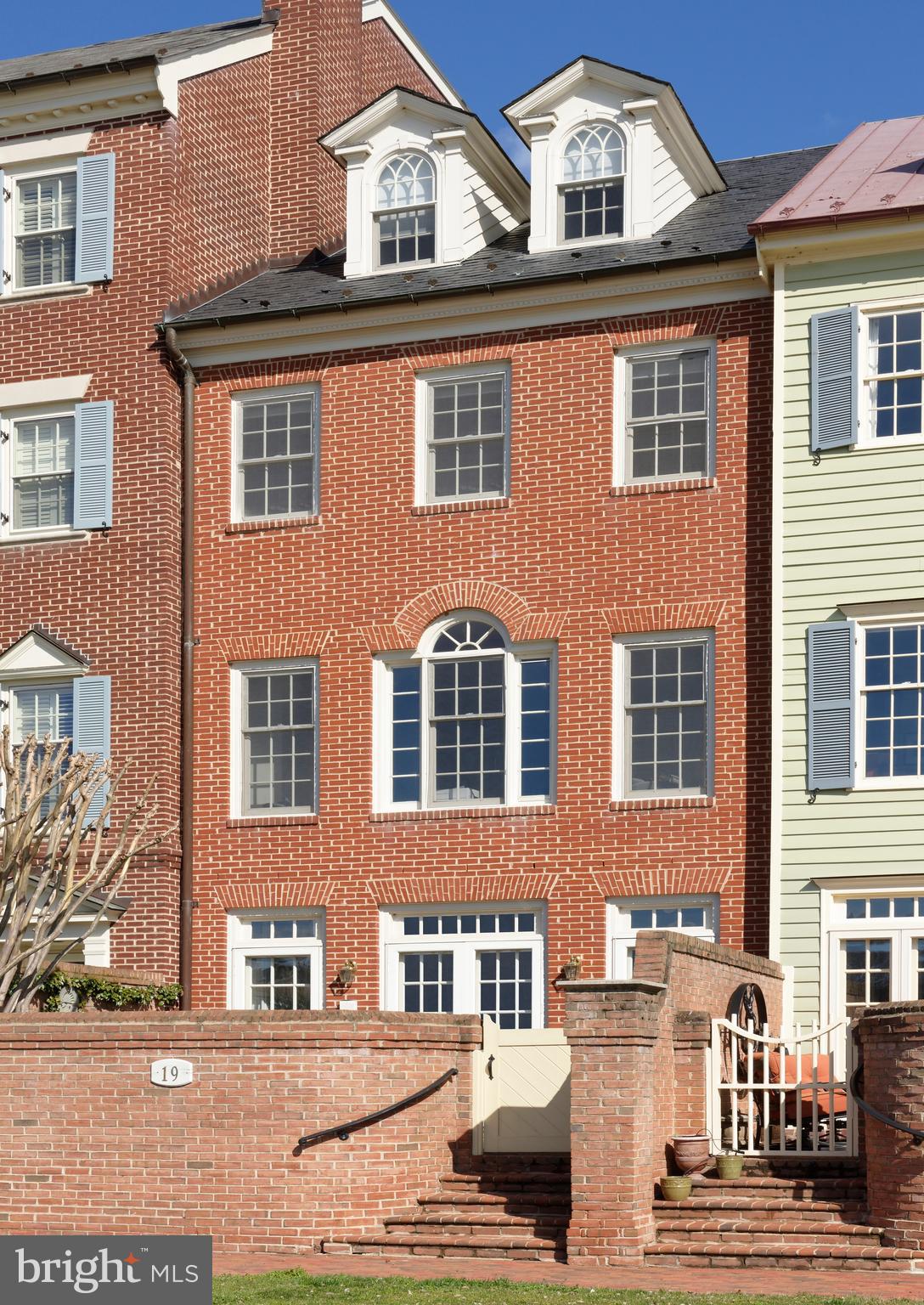 Glorious river views looking South are enjoyed from every level of this handsome brick home in Harborside where finish detail is extensive and custom-milled built-ins are numerous.  For the selective buyer seeking truly distinctive living quarters on the Potomac River in Old Town, this unique floor plan offers gracious open living and dining rooms for entertaining, a sunny kitchen with adjoining family room, all with breathtaking water views.  5 fireplaces, beautiful hardwood floors and deep custom moldings add touches of character, plus an Otis interior elevator will transport you to all floors.  This spacious home features 3/4 bedrooms, 3 full and 2 half baths, a library with fireplace and custom bookshelves,  a generous master suite with sweeping river views plus fireplace and amazing closet space.  Two enormous guest rooms are found on the top floor with a guest bath featuring a skylight.  The private brick walled terrace with French doors from the living room offers quiet outdoor space with lovely plantings.  And the southernmost terrace with tall curved brick walls overlooks the beautiful park beyond with glistening water views to the south.   2-car deeded parking conveys.  Please enter from the southern side, along the riverfront brick sidewalk to #19 gate.  Take a 3D Tour of 19 Wilkes : https://tours.linenandlens.com/1580675?idx=1