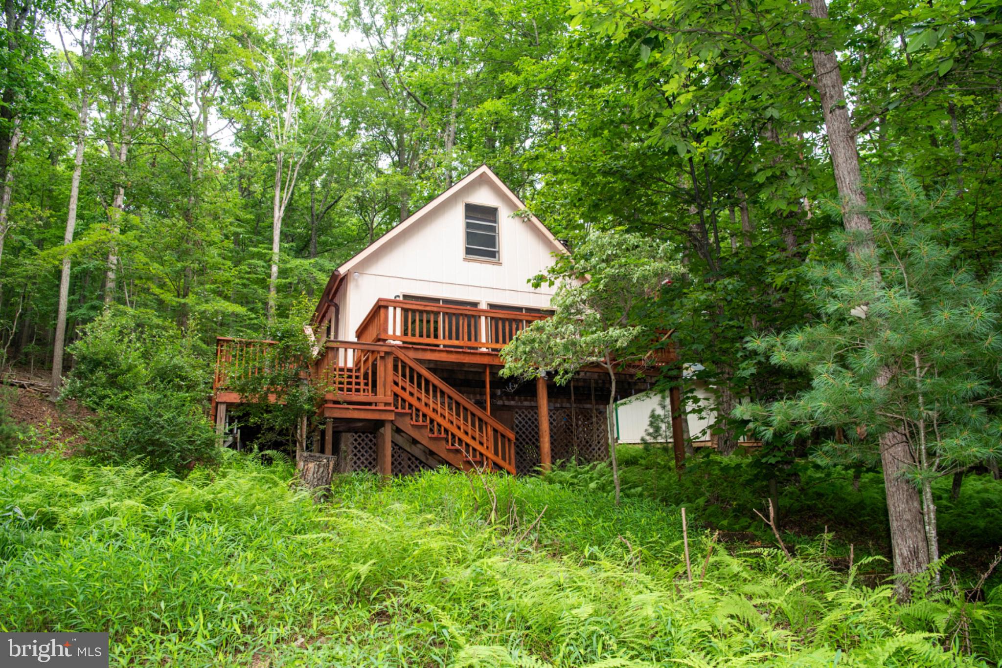 Bring your vision to this 1-bedroom, 1-bath chalet in the desirable Trout Pond area of Lost River. Situated on 2.6 wooded acres and bordering the George Washington National Forest, the property offers privacy and a peaceful mountain setting.
The home is currently a 3 season residence and in need of updates, presenting an exciting opportunity to create a personalized weekend retreat, full-time residence, or potential vacation rental. The setting and location provide an excellent foundation for a thoughtful transformation.
Just minutes from the Trout Pond Recreation Area, where you can enjoy a swimming beach, fishing, hiking, and other outdoor activities. With national forest land at the property boundary and year-round recreation nearby, this is a unique opportunity to create your own Lost River mountain getaway.