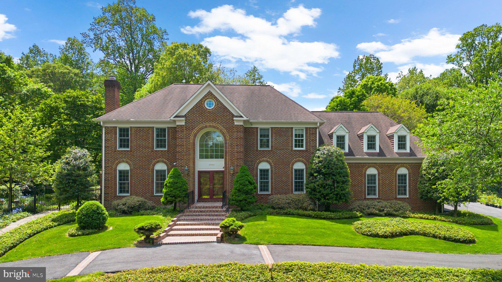 Welcome to 15502 Avery Road, a breathtaking, one-of-a-kind residence tucked away in the prestigious enclave of Avery Forest in Rockville, MD.   This magnificent 5 bedroom, 4 full bathroom,  3 half-bath Estate Retreat in Rockville is a Naturalist's Dream!  Nestled on a stunning 2-acre cul-de-sac lot, this grand three-sided brick estate boasts over 7800 square feet of exquisitely designed living space surrounded by lush gardens, mature trees, and professional landscaping – a haven for naturalists and garden enthusiasts alike.  From the moment you arrive, the circular driveway and stately curb appeal signal something truly special.  Inside, a dramatic two-story marble foyer with a curved staircase sets the tone for refined luxury, leading to elegant formal living and dining rooms adorned with custom millwork, 10-foot ceilings, and rich oak flooring throughout. At the heart of the home lies a gourmet chef’s kitchen, beautifully appointed with granite countertops, custom roll-out cabinetry, recessed and under/over-cabinet lighting, a Jenn-Air cooktop, Sub-Zero refrigerator, Bosch dishwasher, double wall ovens,  built-in wine rack,  built-in planning desk and a pantry. The adjacent breakfast room opens to a spacious private deck, perfect for al fresco dining while enjoying serene garden views. The show-stopping two-story family room features a soaring cathedral ceiling, floor-to-ceiling stone fireplace, oversized windows above the French doors, skylights, and a lighted mirrored wet bar with built-in sink—ideal for entertaining or relaxing in luxury.  Double doors lead to a dedicated study, complete with tranquil views of the waterfall pond and landscaped grounds.  Additional main-level amenities include two half baths, a well-appointed laundry room with built-in storage, and access to the oversized 3-car garage.  Upstairs, the primary suite is a private retreat featuring a vaulted ceiling, skylight, surround sound, sitting area, and custom built-in storage. The spa-inspired owner’s bath offers a dual vanity with granite countertop, Jacuzzi-style tub, a double walk-in shower featuring two shower heads, perfect for a spa-like feel, a private water closet with bidet, and a custom closet/dressing room. Three additional en-suite bedrooms complete the upper level, each featuring built-in shelving and bidets—thoughtful touches that elevate the home's comfort and design. The fully finished lower level provides additional living areas, including a spacious recreation room with fabulous enjoyment space, a large fifth bedroom with full bath, and a flexible bonus room perfect for crafts, hobbies, or a second office, plus ample utility and storage areas. Step outside to experience true serenity—this meticulously landscaped lot  is a peaceful, ever-changing oasis with vibrant blooms in spring, lush greenery in summer, colorful foliage in autumn, and tranquil views in winter. Whether relaxing by the garden pond or entertaining on the deck, this home is a year-round escape. Located just minutes from Rockville Town Center, you'll enjoy easy access to fine dining, shopping, entertainment, and convenient commuting options via Metro and MARC rail stations.  Montgomery College, nearby RedGate Park and Lake Frank are minutes away.  Come and make this your new home forever!