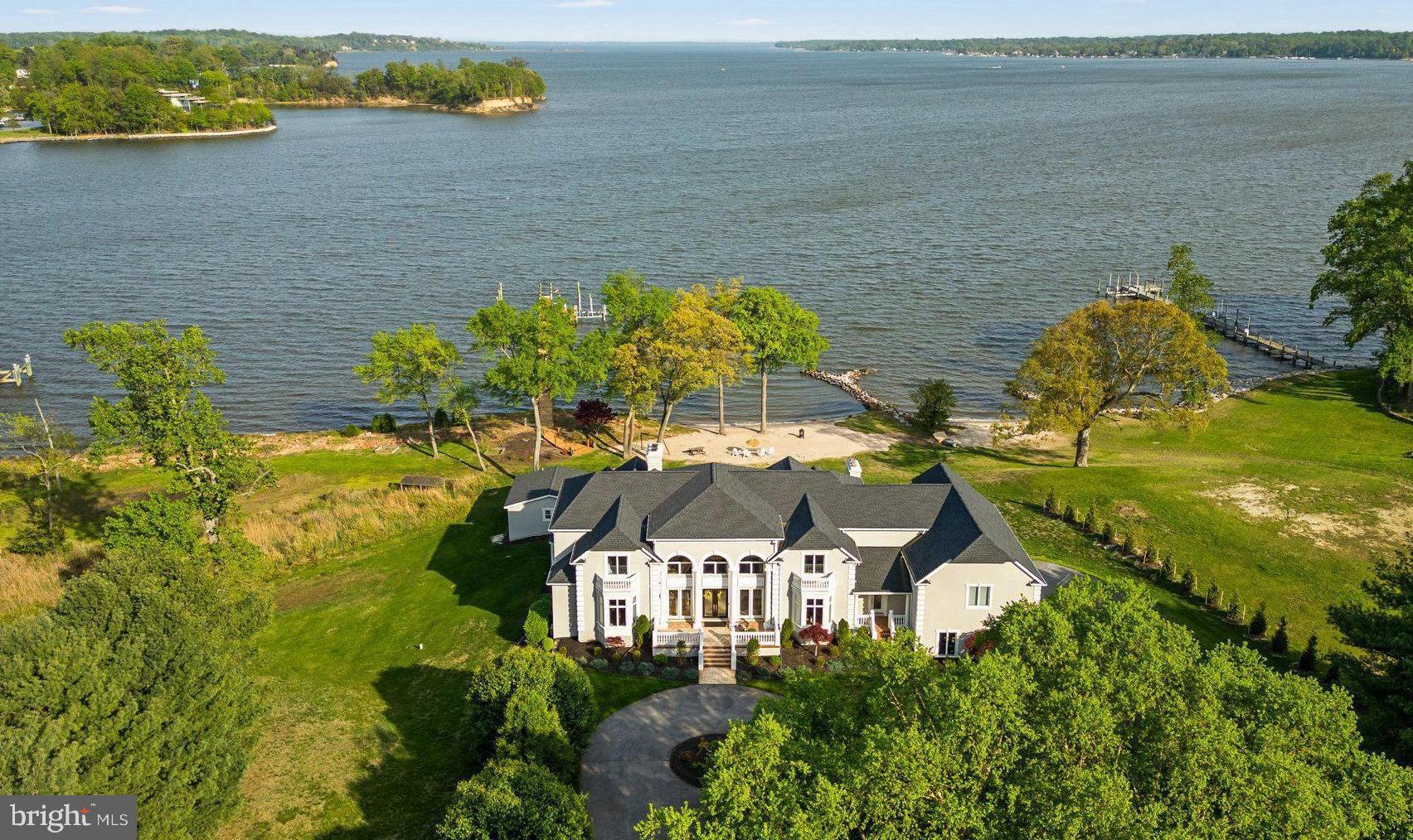 Experience luxury living in this stunning 11,000+ square foot home, nestled on 3.2 acres with over 300 feet of waterfront. Located just 30 minutes from Baltimore and Annapolis, this estate offers expansive, unobstructed views of Broad Creek, the Magothy River, and the Chesapeake Bay. At approximately $400 per square foot, it’s like getting the exceptional waterfront for free!

The walkout lower level, an entertainers paradise featuring a home theater/game room, bar/family
room, gym, and bedroom with en-suite bath, leads to a covered patio with dining for 16, pool house
with one full and one half bath and a dockside garage, and an outdoor kitchen overlooking the in-ground
pool and spa, private beach, 210 foot pier with three slips and a lift (previously providing dockage to a
53’ Hatteras Motor Yacht, 40’ Sea Ray, and a 23’ Mako center console).

Upon entering the grand foyer with curved staircase and soaring ceilings, guests are drawn to the
expansive waterfront views from the adjacent, and equally grand, living room. The east wing contains a
private office, half bath, and primary suite with ensuite bath. The west wing hosts a large eat-in kitchen
with sitting room, dining room, half bath, laundry/mudroom, access to the 4-car garage and immense
bonus room above, and backstairs to the lower and upper levels. Between the wings you’ll find a large
upper deck designed for entertaining.

Up the curved staircase you will find an open central hall overlooking the foyer and living room below,
four spacious bedrooms, two full baths, and a second laundry room.
Built in 2000 this property redefines privacy, ensuring a secluded and independent lifestyle, close to
everything but off the beaten path. Propane powered spa, hot water, dryer, cooktop, and furnaces
keeps utility bills in check. The propane fueled whole house generator ensures uninterrupted power.
With no HOA you have the freedom to live your life your way. The new roof (2022) and exterior (2024)
provide maintenance free living for decades to come.

This estate is a must-see for those who crave a water-oriented lifestyle, wide open spaces, large rooms,
magnificent windows with expansive views, and high ceilings--not to mention truly exceptional
waterfront. Schedule your private tour today!