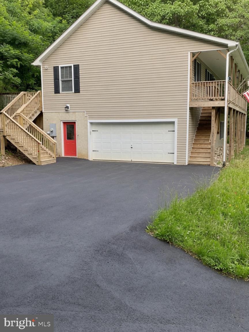 **Motivated Sellers** Commuters dream and nature lovers paradise awaits!! Situated less than 5 minutes from I-66 providing effortless access for quick trips to the city, or weekend getaways.  You will feel worlds away in this mountain view retreat.  Inviting 3-bedroom, 3-bathroom split floor plan home . The lower level offers a  private retreat space featuring a large family/flex room and an additional 3rd full handicap accessible bathroom.  There is also the perfect  space tucked away for an additional refrigerator. The large laundry area has plenty of room for extra storage and large counter spaces. Sellers put in a upgraded well pump in May 2026. 
Step onto the expansive front porch-your personal front-row seat to nature's daily show. Settle into a rocking chair with morning coffee or an evening glass of wine, and soak in the dramatic sunsets that paint the sky in vibrant oranges, pinks, and purples over the rolling mountains. This spot is truly a bird lover's paradise: colorful songbirds flit between branches, hummingbirds dart to nearby blooms, and woodpeckers tap away in the distance. Squirrels scamper playfully across the lawn, and deer often graze. The entire front and back yard beyond the deck along with side yard along driveway has been thoughtfully seeded over $1,000  worth of  vibrant mix of wildflowers and tall, cheerful sunflowers, creating a low-maintenance meadow that bursts with color and add to curb appeal.  The owners also installed gutter guards to help with home maintenance. 
Inside, the open and airy floor plan flows beautifully, highlighted by a spacious kitchen that's a cook's dream: abundant counter space,
generous cabinets giving plenty of storage in addition to a large pantry, stainless steel appliances, and a double oven with built-in air fryer for all your baking and roasting adventures.
For gatherings and relaxation, the wide back deck stretches across the entire rear of the home, creating multiple entertainment zones ideal for barbecues, outdoor dining or unwinding with friends. There is plenty of room to add a hot tub to enjoy basking under the starry night sky.
Practical perks include a large 2-car garage with extra expansion space and built-in shelving for storage, plus lots of extra parking space in the driveway and yard-perfect for hosting friends, large gatherings, or weekend guests without ever feeling crowded