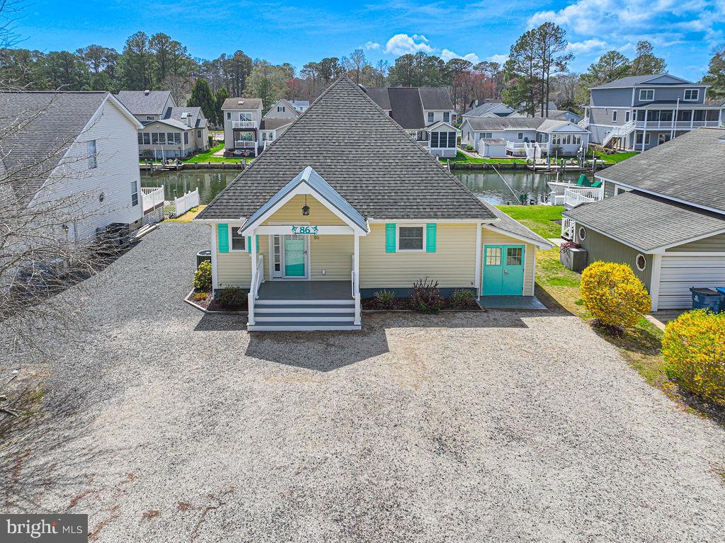 No words can truly capture the beauty and uniqueness of this completely remodeled waterfront home, thoughtfully renovated from top to bottom in 2016. Perfectly situated on a desirable canal-front lot in Ocean Pines, this property offers unobstructed access to the bay—an absolute dream for boating enthusiasts. This stunning 3-bedroom, 2.5-bath residence features a first-floor primary suite with serene canal views, along with a spacious second bedroom on the main level. Upstairs, a versatile loft area includes a third bedroom and full bath, ideal for guests or additional living space.The heart of the home is the show-stopping kitchen, designed with both style and function in mind. It boasts Corian countertops, stainless steel appliances, a double oven, and a large center island. Unique pendant lighting crafted from fishing rods adds a charming coastal touch, perfectly complementing the home’s waterfront setting. Luxury vinyl plank flooring runs throughout, enhancing the home’s modern, cohesive feel. Step outside to an expansive Trex deck complete with an awning—perfect for relaxing or entertaining while taking in tranquil canal views. Boating amenities include an 8,000-pound boat lift and a dedicated fish cleaning station, new pier installed in 2025making this property a true waterfront retreat. Additional features include encapsulated crawl space, tankless hot water heater(2019), awning over back deck. on dock, an oversized attached shed with elegant French doors and ample parking space for guests, boats, or recreational vehicles.This exceptional home offers the perfect blend of luxury, comfort, and coastal lifestyle—ready for you to move in and enjoy.