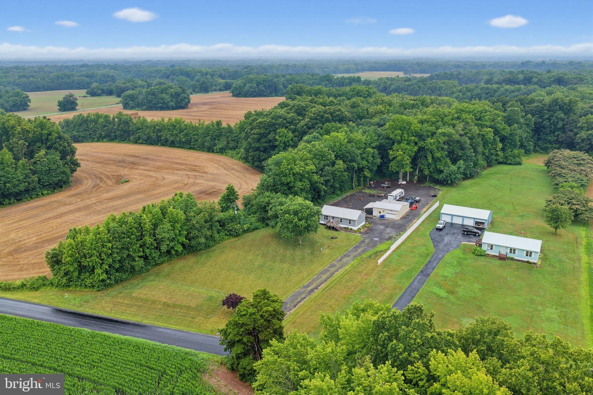 Welcome to your own private retreat! Nestled on 2.56 acres and primarily surrounded by state-protected land, this exceptional property offers the perfect balance of privacy, functionality, and modern updates. From the long private driveway to the expansive outdoor space, you'll immediately appreciate the peaceful setting and endless possibilities this property has to offer. Inside, the heart of the home is the beautifully appointed gourmet kitchen, featuring stainless steel appliances, white shaker cabinetry, stunning exotic granite countertops, and ample workspace for cooking and entertaining. The adjoining living area creates a warm and inviting atmosphere, making it the perfect place to gather with family and friends. The main level also features three spacious bedrooms and a beautifully updated full bathroom complete with a custom tiled stall shower. The partially finished basement expands your living space with a spacious recreation room, an additional bedroom, and a full bathroom, making it ideal for guests, multi-generational living, or a private retreat. The unfinished portion of the basement offers laundry and utility access, along with a dedicated workshop and abundant storage space. Step outside to enjoy the rear deck overlooking your private acreage, a fenced area perfect for pets, hobbies, or gardening, and an impressive heated and cooled outbuilding offering endless opportunities for a workshop, home business, fitness area, studio, vehicle storage, or recreational space. For added peace of mind, the sellers have already completed numerous inspections, including a well flow test, well water test, septic inspection, radon test, and Wood Destroying Insect (WDI) inspection, potentially saving buyers significant upfront costs. A survey completed in November 2025 is also available for the new owners. If you've been searching for a move-in ready property with acreage, privacy, flexible living space, and room to pursue your hobbies or business, this property checks all the boxes. Offering modern finishes, valuable pre-completed inspections, and a setting that is difficult to replicate, this is a rare opportunity to own a truly versatile property where the possibilities are endless. Professional photos will be uploaded 07/10/26.
