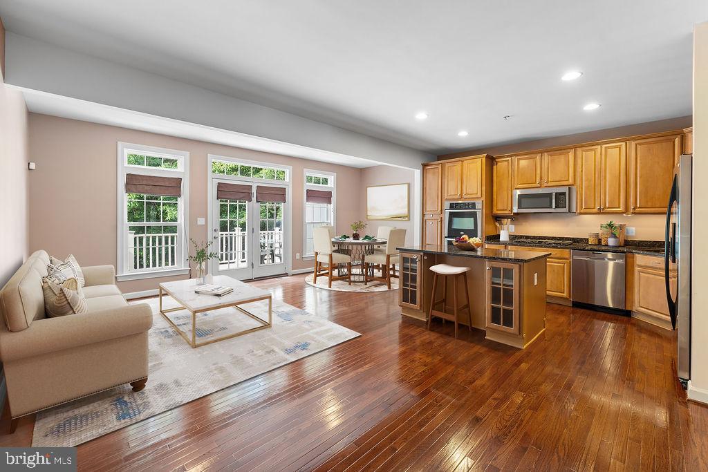 Welcome to this fantastic, move-in ready 3-level brick-front luxury townhouse offering style, space, and convenience in one beautifully maintained package! Featuring 3 spacious bedrooms and 2.5 baths, this home has been incredibly well-cared for and is ready for its next owner. Step into the open-concept main level, where large windows flood the space with natural light, and recessed lighting enhances the modern feel. The freshly painted, neutral-toned interior provides a warm, inviting atmosphere. The gourmet kitchen is a chef’s dream—complete with a large island with seating, granite countertops, oak cabinetry, stainless steel appliances including a gas stove, double wall ovens, a brand-new dishwasher, and an under-sink water filtration system. Step out onto the low-maintenance composite deck, where you can enjoy peaceful wooded views and privacy—perfect for relaxing or entertaining. Upstairs, you'll find a freshly painted upper level featuring a large primary suite with vaulted ceilings, a seating area, walk-in closet, and a luxurious en-suite bath with a soaking tub, double vanity, and a separate tile shower with glass enclosure and bench seating. Two additional generously sized bedrooms with custom shelving and a full hall bath complete the upper level. The fully finished basement provides additional versatile living space and includes a movie screen  with 3D projector system  and Bose 5.1  speaker surround system that will convey with the property—perfect for movie nights or game-day events. The basement also features walk-up access to the backyard and a convenient laundry room with a new washer and dryer. A spacious 2-car garage and classic brick front exterior add to this home's charm and curb appeal. Ideally located near parks, shopping, schools, and major commuter routes including ICC, Route 29, I-495, and I-95. Also just minutes from the new Adventist Hospital and FDA headquarters. This is a rare opportunity to own a stunning, turn-key townhome in a prime location.