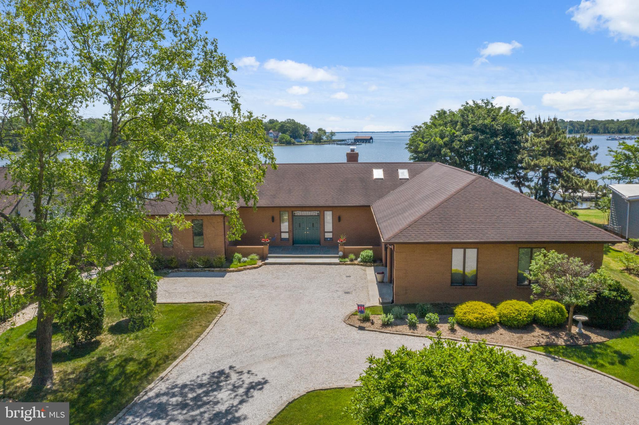Stunning water views of Fishing Creek Cove out towards Thomas Point Light and the Chesapeake Bay. This all brick custom contemporary one level home was built in 1986; has only had one owner; and has been meticulously maintained. Forward thinking owner commissioned a very open floor plan with high ceilings; walls of windows overlooking the water; spacious eat in kitchen overlooking dining area; great room with gorgeous stacked stone fireplace. Primary bedroom has it's own entrance to the waterside patio and view of your private pier; walk in closet and primary bath with soaking tub, separate shower, double vanity.  Mud room (which has separate side entrance) has full bath with shower; great to use after a day of boating or fishing. Two other bedrooms; one with it's own private bath. Skylights in many rooms. The natural light here is amazing. Plus, very easy access to the water (gentle slope to private pier). 125' of bulk head and rip rap. Two zoned heating and cooling (with propane fueled back up heating when temp outside is below 32). Extra large garage has ceiling high enough for a car lift. Many more wonderful features! DON'T MISS THE VIRTUAL TOUR AND FLOOR PLAN! click on the camera icon...