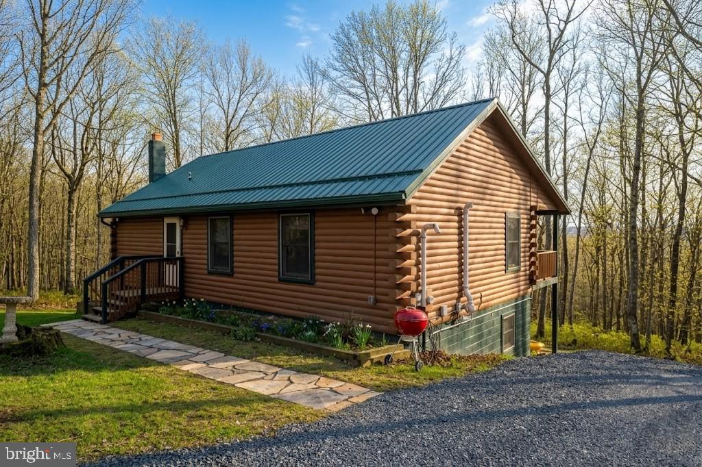 Log cabin on 11 private acres. Located in the gated Timbers on the Yough community featuring Youghiogheny River shared access. Home features include  spacious covered deck, newly installed walkway,  exterior fire pit, breakfast bar, and pellet stove. The primary bath offers dual sinks, dual shower heads and radiant floor heat!