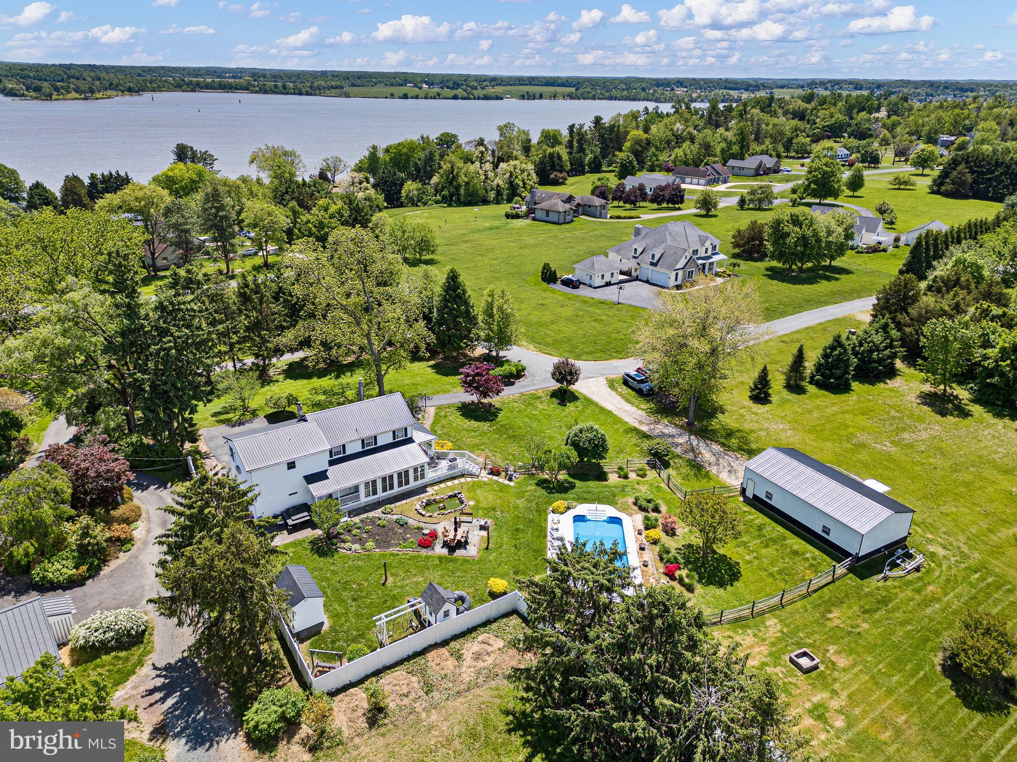 This home has an assumable VA loan (very low interest rate) for qualified buyers!!! Welcome to your dream farmhouse retreat in the highly sought-after Bonney Shores community—where rustic charm meets waterfront living.
Nestled on a beautifully landscaped lot, this 4-bedroom, 2.5-bath home offers the perfect blend of comfort, character, and functionality. Step onto the inviting wraparound porch and take in the peaceful surroundings, complete with mature trees that provide exceptional privacy in the summer and reveal scenic views of the Elk River and C&D Canal in the fall. Pastoral vistas stretch across the landscape, creating a serene countryside atmosphere year-round.
Inside, you’ll find warm hardwood floors throughout and a thoughtfully designed layout ideal for both everyday living and entertaining. The all-season sunroom is a standout feature—perfect for enjoying morning coffee or relaxing with nature in every season. Cozy up by one of three pellet stoves, located in the living room, primary bedroom, and even the expansive 24'x45'  pole barn. The primary suite also includes a split unit for personalized climate control and added comfort.
Outdoors, your private oasis awaits. The in-ground saltwater pool is perfect for summer gatherings, while the tranquil koi pond and lush landscaping add to the home’s charm and appeal. For boating enthusiasts or those in need of serious storage, the massive pole barn offers ample space—large enough to accommodate a sizable boat with ease.
Located in a water-oriented community, residents enjoy access to a private beach area and community boat launch along the Elk River—making it easy to embrace the Chesapeake lifestyle.
Additional highlights include a whole-house generator for peace of mind and a setting that truly captures the best of both rural beauty and waterfront convenience.
This is more than a home—it’s a lifestyle. Don’t miss your opportunity to own a slice of Bonney Shores paradise.