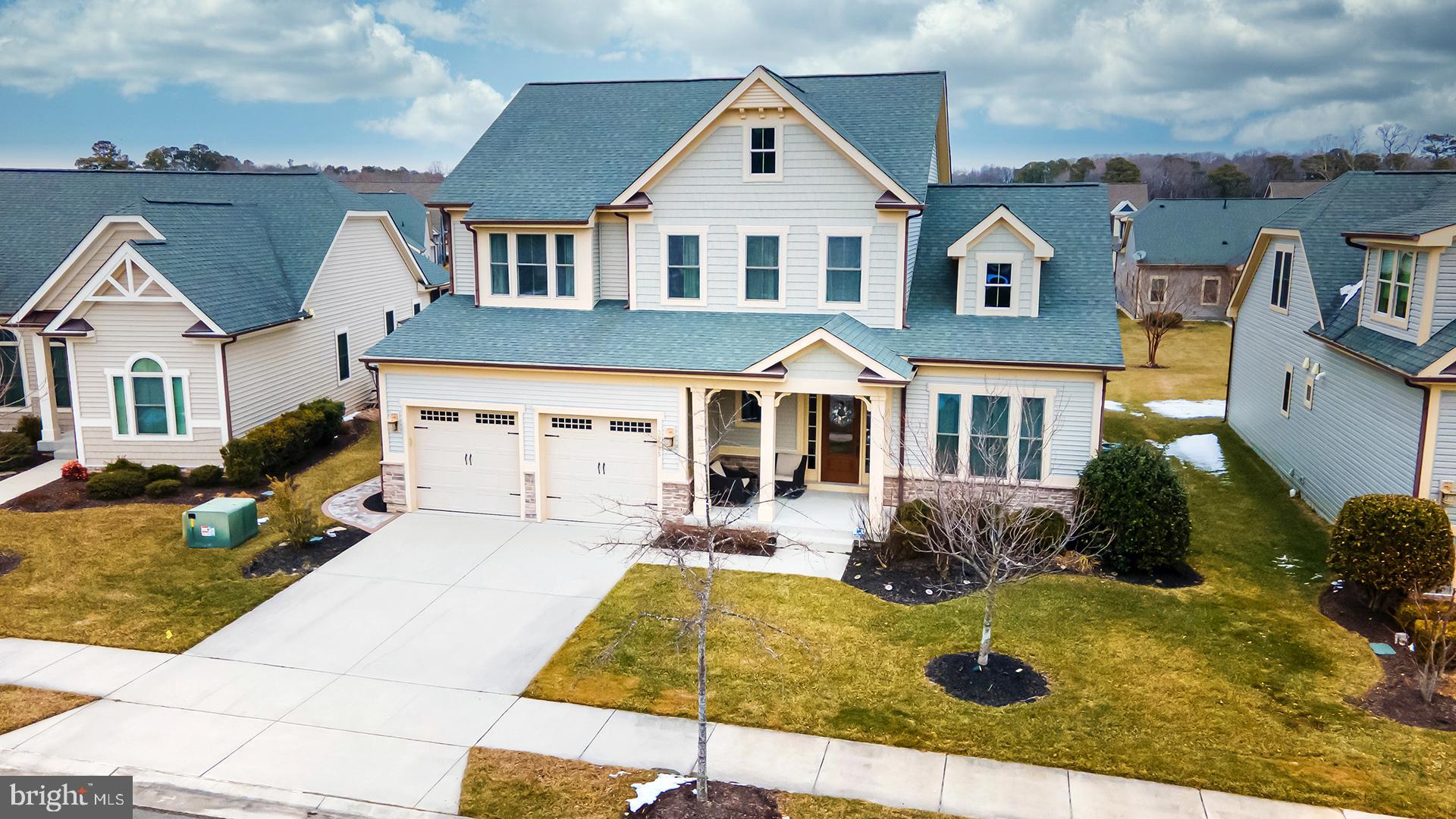 TURNKEY IN BAY FOREST! Welcome to this beautifully furnished 5-bedroom, 4-bath coastal retreat in the highly desirable Bay Forest community, offering over 3,000 square feet of thoughtfully designed living space. Showcasing coastal style architecture with elegant, high-end finishes throughout, this home greets you with a light-filled foyer that flows seamlessly into a dramatic two-story great room featuring a coffered ceiling, a wall of windows, and clerestory windows that bathe the space in natural light. A loft above overlooks the living area, enhancing the home’s open and airy feel. The open-concept floor plan connects the great room to a stunning gourmet kitchen, complete with granite countertops, stainless steel appliances, a cooktop with hood fan, wall oven, built-in microwave, walk-in pantry, and abundant cabinetry accented by a specialty backsplash. A large island with double sinks, pendant lighting, and counter seating for four makes entertaining effortless. Adjacent to the kitchen, the dining room offers direct access to the covered rear porch—perfect for indoor-outdoor living. The main-level owner’s suite is a serene escape, highlighted by a tray ceiling, plush carpeting, and a spacious walk-in closet. The luxurious ensuite bath features double vanities, a window for natural light, a large tiled step-in shower with bench and glass door, and a private water closet. A main-level guest room with full bath, along with a laundry room with utility sink and a functional mud room, complete the first floor. Upstairs, a mezzanine overlooks the great room and leads to three additional bedrooms, two full baths, and a versatile bonus room with glass pocket doors—ideal for a media room, office, or play space. Outside, the landscaped front yard includes a welcoming covered porch and walkway leading to a convenient outdoor shower. The backyard is designed for gathering and relaxation, featuring an expansive hardscaped patio with a stone-encased firepit, sitting wall, and grill enclosure.
Residents of Bay Forest enjoy an amenity-rich lifestyle with a beautiful clubhouse offering entertaining areas, library, dining room, and fitness center. Rentals are permitted with a 7-night minimum, making this a great investment for second homeowner. Outdoor amenities include a resort-style pool with lap lanes and kiddie pool, putting green, playground, tennis, bocce and horseshoe courts, kayak launch marina, and beach shuttle service. Ideally located just minutes from downtown Ocean View and the pristine shores of Bethany Beach, you’ll enjoy easy access to coastal dining, shopping, entertainment, miles of shoreline, boating, and scenic walking trails.