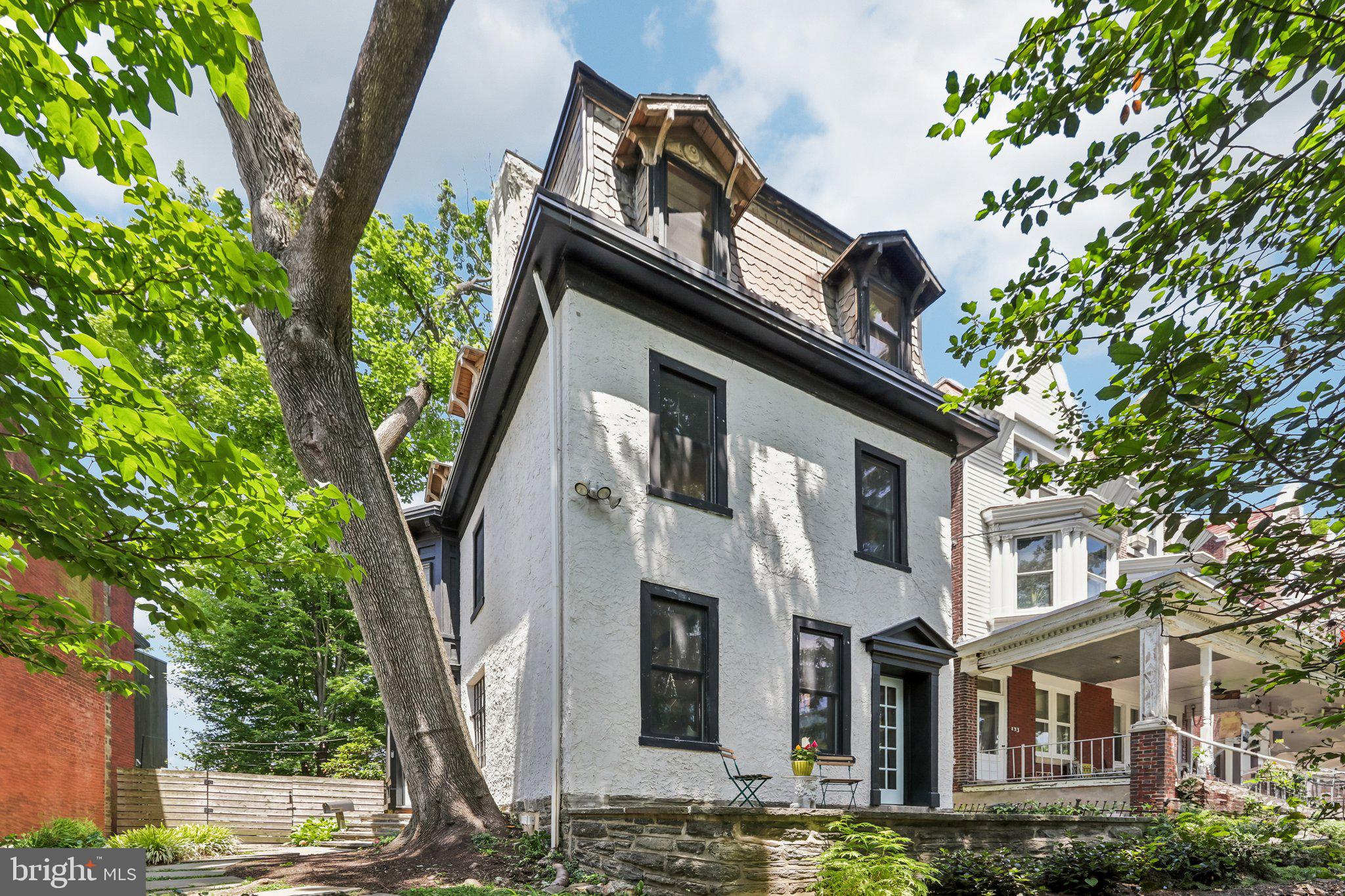 135 West Mount Pleasant Avenue is a detached single-family home perched high above and approximately 50 feet back from the road, this detached single-family West Mount Airy home offers a rare combination of superb privacy, significant character, tasteful renovation and modern amenities, and expansive spaces, ample natural light, and exceptional outdoor space.

With 4 bedrooms, 2 full baths, and a huge rear yard, this home provides among the finest outdoor space you will find in a city home. Raised well above the street and tucked back behind mature trees and landscaping, the setting feels serene and secluded while still being in a desirable, highly walkable location.

Gorgeous character and stunning light throughout, with four exposures and a remarkable mix of original and updated details. Original random-width hardwood floors; exposed brick, beams, and ductwork; original doors with extensive detail, and an eclectic mix of beautiful old-world windows create a warm and distinctive feel. High-quality wood replacement windows on the front of the home add comfort, supreme quiet, and energy efficiency, all while maintaining the home’s overall charm.

As you approach 135 W Mt Pleasant, a winding path takes you past mature trees and greenery to the tucked-away front door. This charming plot feels quaint, private, and offers an overall fairy tale quality. The combination of being set approximately 50 feet back from and elevated above the street level creates a wonderful sense of warmth, quiet, shade and light.

The home’s outdoor space is exceptional. In addition to the front yard hidden behind the trees, there is a spacious and private side yard, a covered porch off the living and dining room (behind your privacy fence), and a spectacularly spacious private grass yard in the rear.

Inside, the home is the perfect complement of eclectic character, original old-world detail, renovated kitchens and baths, and updated systems.

As you walk through the front door, you may notice the birds chirping from the front, side, and rear yards. The open first floor has stunning light and character—highlighted by the tastefully eclectic high-end kitchen and glass leading to the huge rear yard. The second floor continues the home’s warmth and character, with high ceilings and original random-width pine floors throughout. This level includes three spacious bedrooms, a full bath, excellent closet space, and convenient upstairs laundry. The third floor is dedicated to the full-floor primary suite, offering privacy, volume, and beautiful natural light. The primary bedroom features high cathedral ceilings, original exposed beams, a skylight, four windows across three exposures, original random-width pine floors, and a walk-in closet. The full basement includes storage and mechanicals.

Systems include two-zone high-efficiency heat and Central Air, a tankless water heater, 200-amp electric service, and updated/rewired electric.

Enjoy the most convenient West Mt Airy location--easily walkable to many restaurants, cafes, retail, parks, shopping, library, the Wissahickon trails and more. Short drive to more of the Wissahickon Valley and miles of wooded trails. Weavers Way Coop and Mt Airy Village. Mt Airy Coffee! 5-minute walk to the SEPTA regional rail. And, of course, a quick ride to Chestnut Hill, Center City, Manayunk, and the Main Line. Live in one of Philly's most desirable and historic neighborhoods. Houston School Catchment (easy walk).