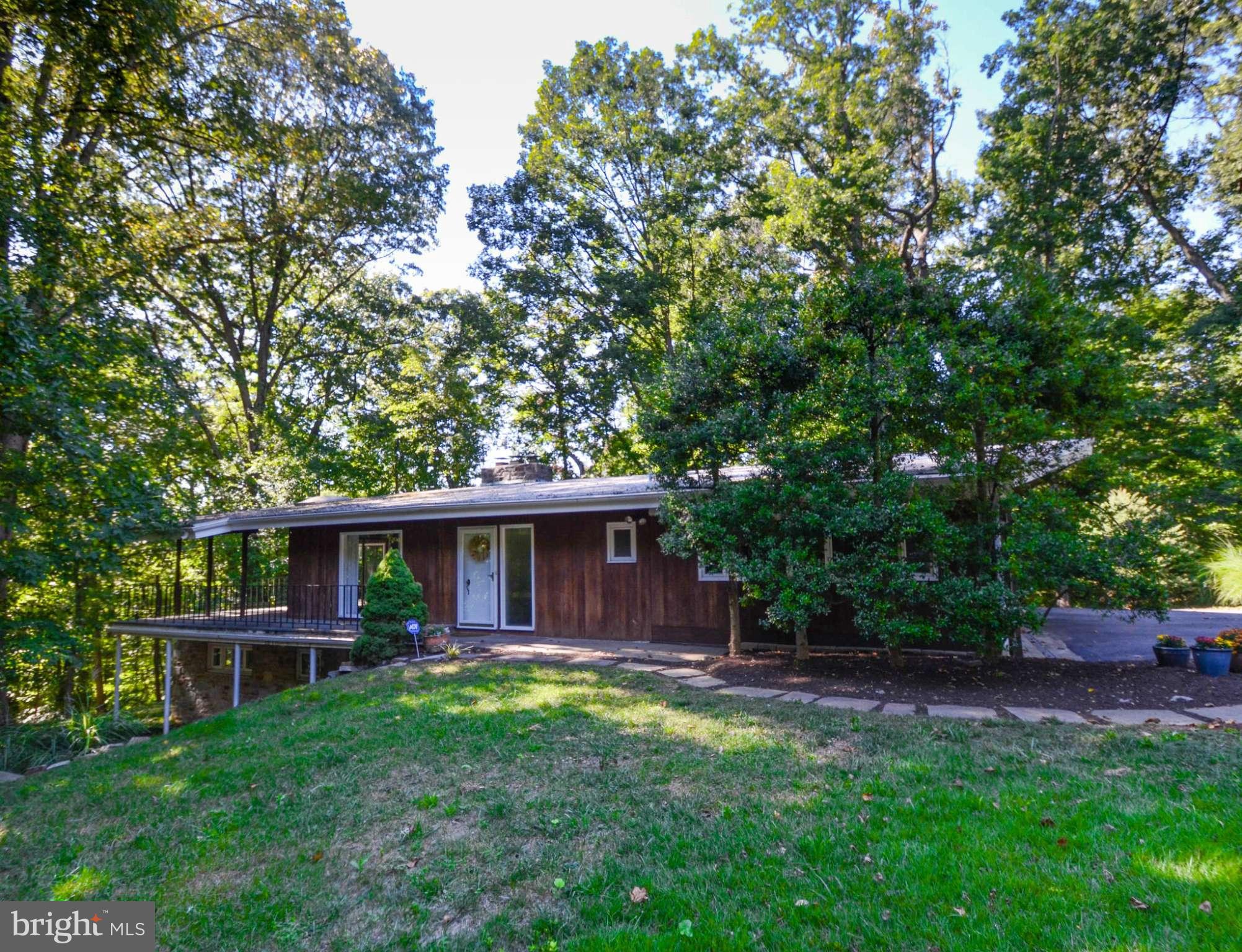 Mid-century modern situated on a beautiful 2 acre wooded lot on a cul-de-sac - Open floor plan with vaulted ceiling & awesome sylvan views - Well maintained - Nice proportions for entertaining - 1st floor bedroom could easily be converted into a 2nd master bedroom - 1 car carport with driveway for additional cars - Elevated 18x14 patio off the living room.