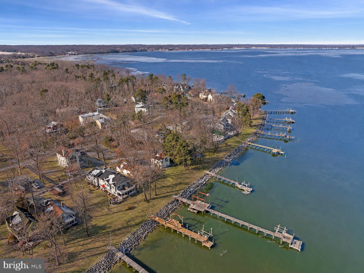 Some properties come along once in a generation. This is one of them.
Tucked within the coveted Holland Point community of North Beach, Maryland, this rare and expansive waterfront compound offers something the Chesapeake Bay area simply does not produce anymore — significant water frontage, a grandfathered private dock that is the longest in North Beach, and the kind of breathing room and flexibility that coastal dreamers spend a lifetime searching for.
From sunrise to sunset, the views across the bay are nothing short of extraordinary. Whether you’re casting a line off the dock, pulling in with your boat after a day on the water, or simply sitting on the porch watching the last light melt into the Chesapeake, this property delivers the full Bay experience in a way few others can.
The main waterfront residence has been thoughtfully updated where it counts — featuring a refreshed kitchen, dining area, and bath — and opens into a generously scaled living area designed for effortless entertaining. Multiple bedrooms, each with its own in-room sink, offer a charming nod to a bygone era of gracious hosting, while a spacious family room positioned closest to the water keeps you connected to the views at every turn. Step outside to a lovely enclosed wraparound patio that flows naturally to the oversized dock — the perfect perch for avid boaters and sunset watchers alike.
What truly sets this compound apart is what’s included beyond the main house. A second improved waterfront property, directly adjacent, comes with the sale — featuring a substantial garage base suitable for boats and vehicles, and an upper level that opens into a bright, airy great room with a full bath and flexible space ideal for guests, a studio, or a private home office. Completely self-contained, it functions as its own retreat while remaining part of your larger compound.
Together, these two properties create something genuinely rare on the Chesapeake — a compound with room to spread out, house your toys, welcome your people, and savor coastal living exactly on your own terms. Whether your vision is multigenerational living, a boater’s paradise, a creative haven, or simply an extraordinary primary or vacation retreat, this Holland Point compound has the bones, the footprint, and the waterfront to make it all possible.
Opportunities like this do not come twice.