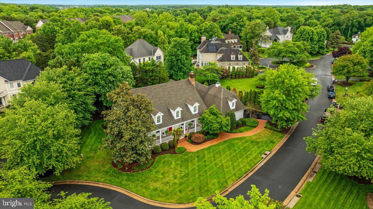 Experience true luxury living in this magnificent custom estate nestled within the prestigious gated golf community of Lake Manassas. From the moment you arrive, you are welcomed by lush landscaping and a charming brick walkway leading to the expansive covered front porch. Accented with cedar board ceilings, this picturesque outdoor space serves as a seamless extension of the home which is perfect for morning coffee, evening cocktails, and year-round enjoyment. Meticulous craftsmanship and exceptional design blend effortlessly to create a home that is elegant, modern, and inviting. Inside, the grand two-story foyer opens to gleaming hardwood floors, custom built-ins, pocket doors, archways, and crown molding throughout. The thoughtfully designed floor plan offers spacious, sun-filled living areas including formal living and dining rooms, a powder room, and two wood-burning fireplaces. The gourmet chef’s kitchen is beautifully appointed with a Sub-Zero refrigerator, 6-burner Thermador gas range, and dishwasher, complemented by quartz countertops, premium cabinetry, a large center island, butler’s pantry, and walk-in food pantry. Four sets of custom French doors and multiple skylights bright plenty of natural light into the home while showcasing serene backyard views. Outdoor entertaining is effortless with the expansive deck and built-in stone cooking area. The main-level owner’s suite is a true retreat featuring private outdoor access, vaulted ceilings, and an oversized walk-in closet. The spa-inspired primary bath offers a freestanding soaking tub, dual vanities, rainfall shower, and heated floors. Upstairs, four generously sized guest bedrooms are served by three recently renovated full baths. An additional flexible living space is ideal for a recreation room, playroom, media room, or home office.
The fully finished lower level is truly a showstopper, featuring a full wet bar, impressive 650-bottle wine cellar, high-end billiards room, two full baths and one half bath with steam showers, plus a private in-law suite complete with separate entrance/walk-out access, kitchenette, additional laundry room, and spacious living room with gas fireplace. Meticulously maintained, this exceptional residence boasts over $250,000 in upgrades and renovations throughout. Lake Manassas is home to the prestigious Robert Trent Jones Golf Club, host of the 2024 Solheim Cup, as well as the award-winning Stonewall Golf Club. Ideally situated on a premium corner lot just minutes from I-66, Route 28, shopping, dining, and commuter lots, this extraordinary property offers luxury living at its finest. This is a rare opportunity you will not want to miss. Come experience the lifestyle you deserve! Schedule your showing appointment today!