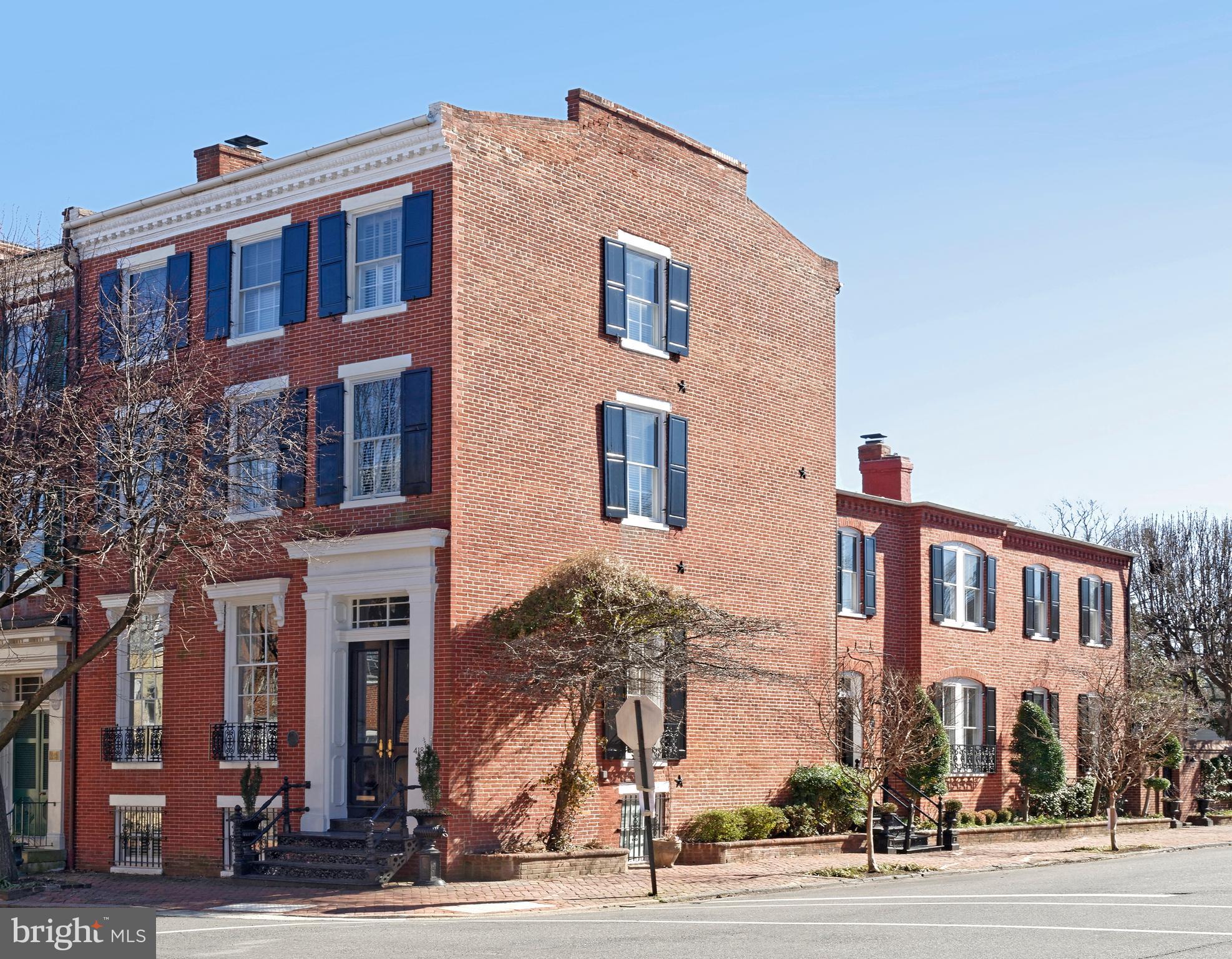This iconic celebrated townhouse, circa 1852, is a historic gem that exemplifies quality and elegance.  Original floors, high ceiling, huge windows, four fireplaces, two staircases, 4/5 bedrooms, 4 1/2 baths, family room, office and wet bar, all awash in natural light.   You'll enter through the vestibule and handsome  original front door, into the main long hallway.  Large scale entertaining and family gatherings will be hosted in the spectacular living room with 11' 8" high ceilings, a wood burning fireplace, a Czechoslovakian crystal chandelier and built-in bookshelves on the south wall.   Main hallway extends  toward the dining room with another beautiful crystal chandelier, a gas fireplace with custom brass/glass screen and windows on both sides of the room.  The side entrance to the house features statuary marble floors in the foyer which lead to a cozy office and half bath.  The bright kitchen with hand painted tiles offers multiple windows,  much storage and counter preparation,  a  large table space plus a door to the patio for al fresco dining.   The staircase to the second floor is grand as is the divine master suite with a fireplace, original floors, custom millwork, tall windows and original wide doors.  A separate dressing room offers multiple closets, tall shelves for hat boxes and other cabinets for folded items.  Every inch of the gorgeous master bath is clad in marble, a custom cabinet for incidentals and a large marble shower with seamless glass door.   Windows line the hallway leading from one room to another.  The center room is a  bedroom, library or TV room,  offering a gas fireplace, windows on two sides, storage closet and great old floors.  Another renovated bath adjoins the center room.  A back bedroom with windows on 3 sides is sizeable with closets and open shelves.  Two guest rooms and a full bath are found on the top floor, also with many windows.  The reading nook on the top floor landing is a perfect place to finish that last chapter of your book. The expansive lower level is a wonderful casual area for family gathering or an ideal workspace featuring handsome moldings, full bath,  and custom built-ins plus two desks.  There is additional ample storage in the lower level including many closets and access to the pergola covered breezeway leading to the lovely patio.  This distinguished residence in the southeast quadrant is within walking distance to everything  Old Town has to offer.