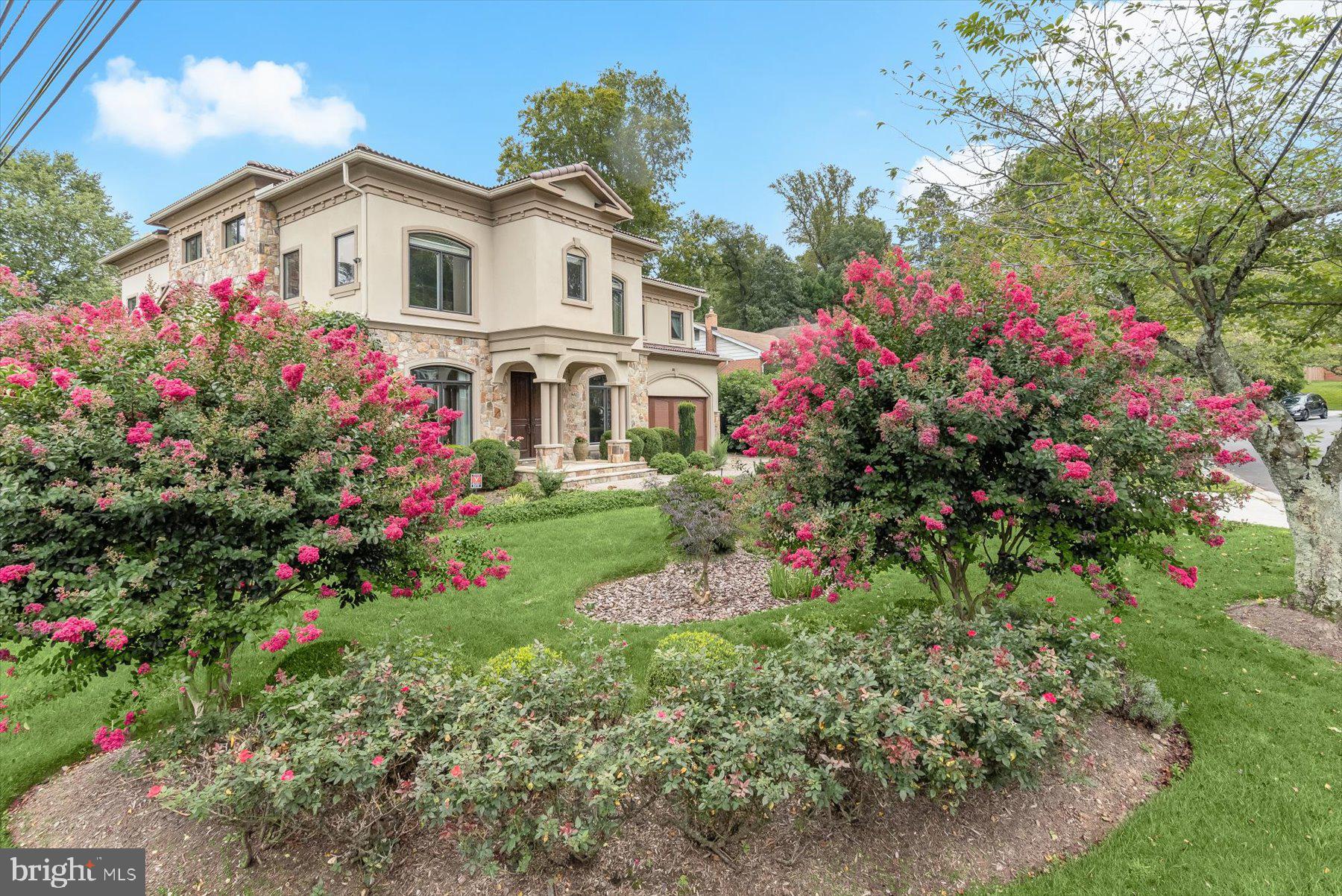 Welcome to this extraordinary custom Mediterranean residence, perfectly situated on a prominent corner lot in highly coveted Oakwood Knolls. Just moments from Whitman High School, Pyle Middle School, the newly reimagined Westbard shopping center, and downtown Bethesda, this home offers an exceptional blend of privacy, convenience, and refined living.

A striking stone façade, paver driveway, and dramatic arched entry lead into an elegant foyer with custom millwork and stunning hardwood floors, setting the tone for the home’s sophistication. 

The main level begins with formal living and dining rooms with gorgeous arched windows, and the perfect amount of space for full-scale entertaining or everyday casual enjoyment.  Continue on to find a sun-drenched office with elegant built-ins, and a beautifully appointed powder room. Adjacent and centrally located, you’ll find the elevator which services all levels and is ideal for multi-generational living.  The expansive family room boasts coffered ceilings, a double-sided fireplace with an oversized stone mantle, and two sets of French doors opening to the back patio, providing seamless indoor-outdoor flow and views of the beautifully landscaped yard. Picture windows throughout the main floor bring the outdoors in, highlighting mature plantings and a serene rain garden. The chef’s kitchen is a true centerpiece, with stunning stone floors, a massive oversized island, breakfast area, high-end appliances, a butler’s pantry with wine fridge, and a huge walk-in pantry. French doors provide direct access to the backyard, perfect for entertaining around the built-in grill.  The adjacent mudroom, two-car garage, and a custom green room add both elegance and practicality.

Upstairs, all bedrooms are wonderfully spacious and adorned with large walk-in closets. The incredible primary suite is a private sanctuary, with dual walk-in closets, a spa-like bathroom with dual vanities, soaking tub, separate shower, and impeccable stonework. A bonus sitting room with soaring ceilings and its own closet completes the suite. Two additional bedrooms share a Jack-and-Jill bathroom, and a fourth bedroom offers full privacy with an en-suite bath. The upstairs laundry room includes built-ins and a sink for convenience. A highly coveted and rare elevator serves all levels, while the dramatic two-story stairwell, flooded with light, provides access to the side yard for a potential private entrance to the lower level.

The expansive lower level delivers exceptional versatility, featuring stone floors throughout, a full legal bedroom with en-suite bathroom, a huge recreation area perfect for a movie room and game nook, plus a separate gym with glass doors and a wall of windows. A bonus wellness space with a sauna completes this level. 

Outdoors, the property is an entertainer’s dream, with extensive custom hardscape, covered patios featuring built-in heaters, wired speakers, an outdoor fireplace, and multiple areas for dining, lounging, and relaxation. The fenced yard also features a pergola and an irrigation system, ideal for those who appreciate gardening. A charming greenhouse adds a serene escape for plant lovers or quiet enjoyment.

Meticulously maintained and presenting like new, this home blends sophisticated design, luxurious finishes, spacious interiors, and an unbeatable Oakwood Knolls location, offering the ultimate in high-end, refined living.