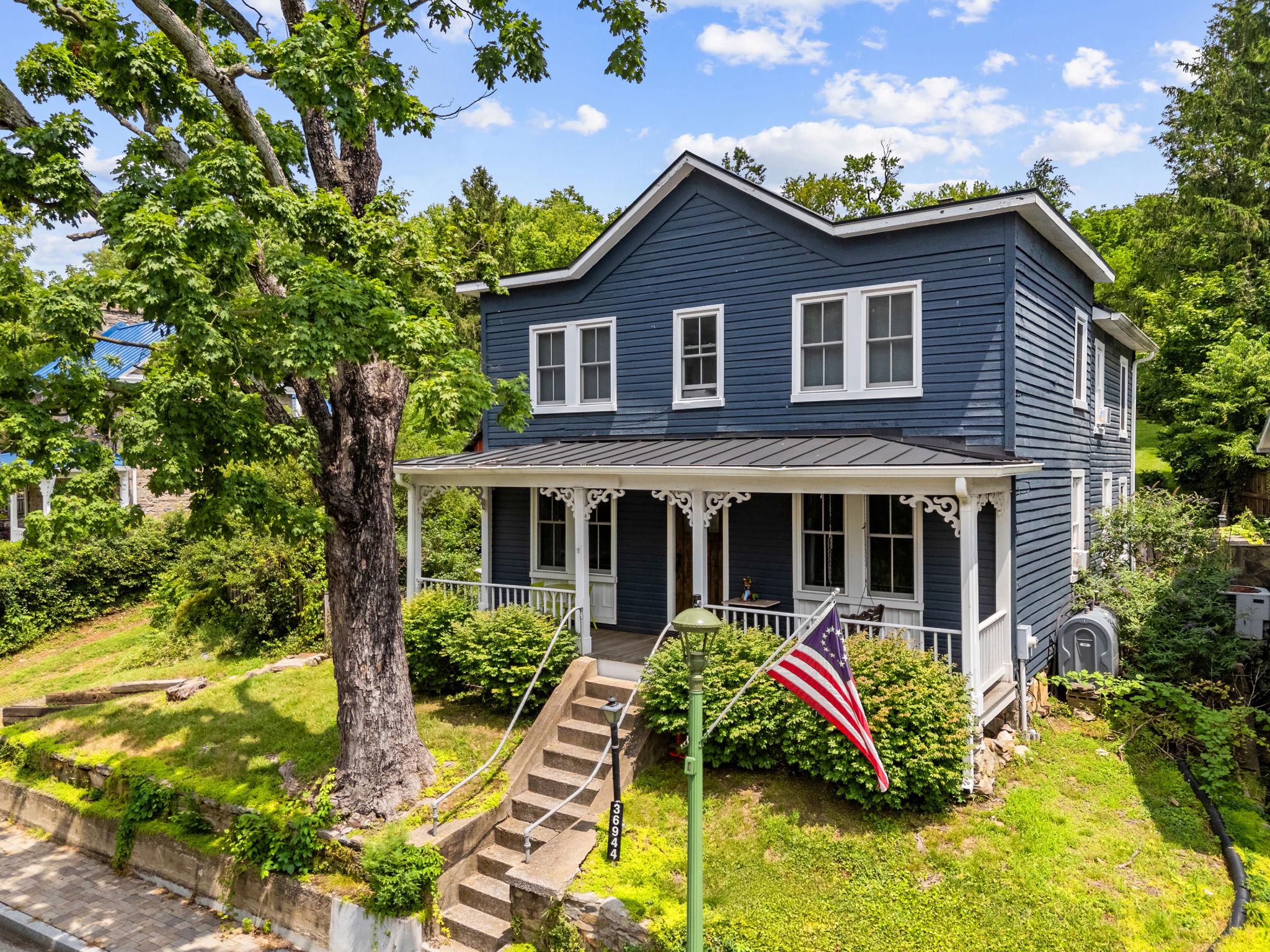 Tucked into the heart of historic Hillsboro, this 1885 farmhouse blends post–Civil War architecture with modern comfort in one of Loudoun County’s most charming villages. The era saw both farmhouse‑style and Victorian homes built here, and this clapboard farmhouse stands out with higher ceilings, original hardwood floors, and a warm, inviting layout. Inside, you’ll find a living room with wood‑burning stove, an updated kitchen with gas cooking, clever storage, and generous light, plus a dining room with built‑ins and a cozy family room that nods to the old “sleeping porch” tradition with its distinctive windows and porch access.

Upstairs, the ensuite primary bedroom is unusually generous for a historic home, offering two walk‑in closets and a renovated bath with custom shower, rain shower head, and clawfoot tub overlooking the backyard. Two additional bedrooms provide comfortable space for guests, family, or a home office, and a renovated main‑level full bath doubles as a laundry room with hex tile, subway‑tiled shower, and stackable washer/dryer. Outside, the home sits on nearly three‑quarters of an acre with a large backyard, garden shed, and valuable off‑street parking—ideal for relaxing, gardening, or entertaining while enjoying the quiet village setting. This historic home has too many upgrades and improvements to list here, including new or newer roof, windows and furnace, see listing documents for a complete list.

Beyond the property itself, Hillsboro offers a preserved streetscape, artisan and community events, and convenient access to popular destinations. Wineries and breweries in Loudoun County are close by, and West Virginia attractions such as Harpers Ferry and the Charles Town racetrack & casino are within easy reach. Whether you’re seeking a character‑rich primary residence or exploring the home’s potential for short‑term rental or weekend‑getaway use, this farmhouse captures a timeless village lifestyle with strong regional appeal.
