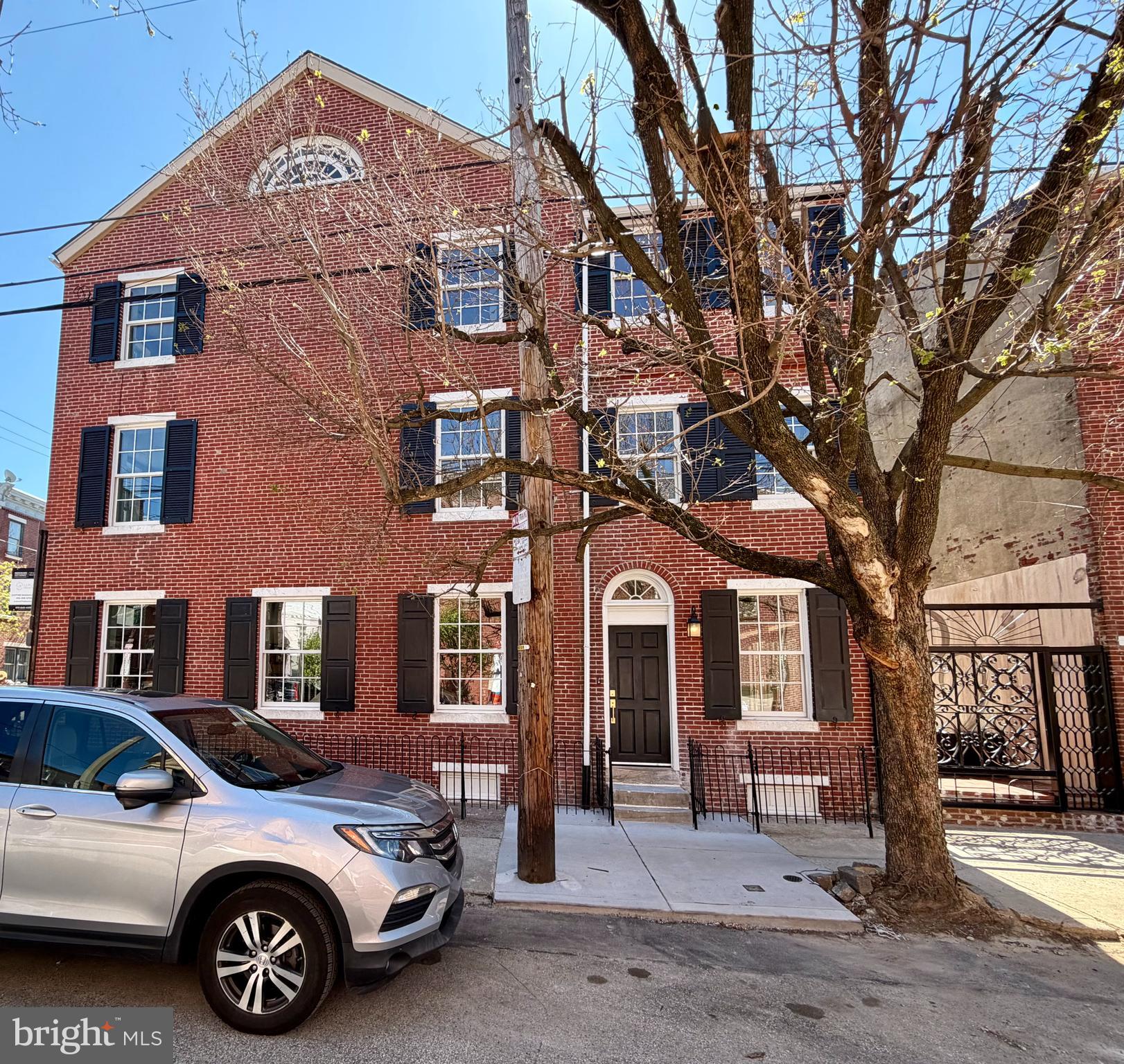 This is a rare opportunity to own a fully reimagined historic residence where timeless architecture meets exceptional modern design.
Set on a coveted sun-drenched corner in Queen Village, this remarkable home has been completely redesigned and rebuilt to today’s highest standards while preserving its elegant historic façade and architectural character. Light pours in from three exposures through an abundance of new windows, transoms, and the dramatic double-wide sliding glass doors that open to a private brick garden patio 
Step through the double entrance doors into a breathtaking 18-foot-wide open space with soaring 9-ft ceilings, where wood floors and carefully designed lighting create an atmosphere that is both sophisticated and welcoming. The seamless open layout flows effortlessly from the Dining Room, through the Kitchen into the Living Room and out to the Patio.
The Dining Area is anchored by the striking historic Canted Bay Window with tall, divided glass panes on three sides allowing even more light into the space and providing an architectural niche for plantings or display.
The custom designed and crafted inset wood cabinetry provides the perfect transition from the Dining Area to the Gourmet Kitchen, anchored by an expansive quartz island designed for gathering, dining, and entertaining. A suite of Thermador appliances includes a 6 burner gas range, exhaust hood, French-door refrigerator with integral ice and water, a stainless dishwasher, and a garbage disposal. thoughtful details in the custom cabinetry incl. such as pull-out waste storage and an appliance drawer with integrated power. Illuminated glass cabinets and cornice lighting create a warm ambient glow throughout the space.
The Living Room is centered around a new gas fireplace with artisan-crafted mantel while a wall of glass frames views of the private patio beyond, creating seamless indoor-outdoor living. The newly bricked Patio provides space for dining, relaxing and entertaining and features custom ironwork that has been designed specifically for this space, providing beauty and privacy. 
A custom staircase leads to the private Primary Suite Level, designed as a serene retreat. A dramatic hall of closets includes a generous walk-in closet and an additional set double closets lead to the sunlit Main Bedroom which features large windows and new fireplace with brick hearth and a local artisan’s custom wood mantel.
The Primary Bath is a spa-like sanctuary featuring a freestanding soaking tub framed by two windows, a wall-to-wall glass shower enclosure, separate water closet, dual vanities with integrated lighting, and a dedicated makeup area. This space also features a large storage closet and a full height built in mirror.
The 3rd floor feat. 2 more Guest Bedrooms and 2 Baths. The first bedrm feat. windows on 2 sides, a large walk-in closet, and an ensuite full bathroom w/ stall shower, floating vanity and mirror with integral lighting.  On the other side of the 3rd fl. you’ll find the Full Hall Bath feat. a large wall to wall shower with glass door, vanity w/ mirror & integral lighting. At the end of the hall is the stunning 3rd bedroom with plenty of room and windows.
  
Ascending to the fourth floor, a spectacular antique crescent moon window crowns the space, flooding the room with light and framing views. Dormer windows enhance the charm and atmosphere of this versatile retreat—perfect for a bedroom, studio, or private office.
The lower level offers exceptional flexibility with a large recreation or fitness space, a full bath with oversized glass shower, and a dedicated room already wired for a future sauna. A glass-walled room provides an ideal home office or creative space, while a powder room and coat closets add convenience for guests.

This is a rare offering where historic elegance, modern craftsmanship, and thoughtful design come together in perfect harmony. Simply move in and enjoy!