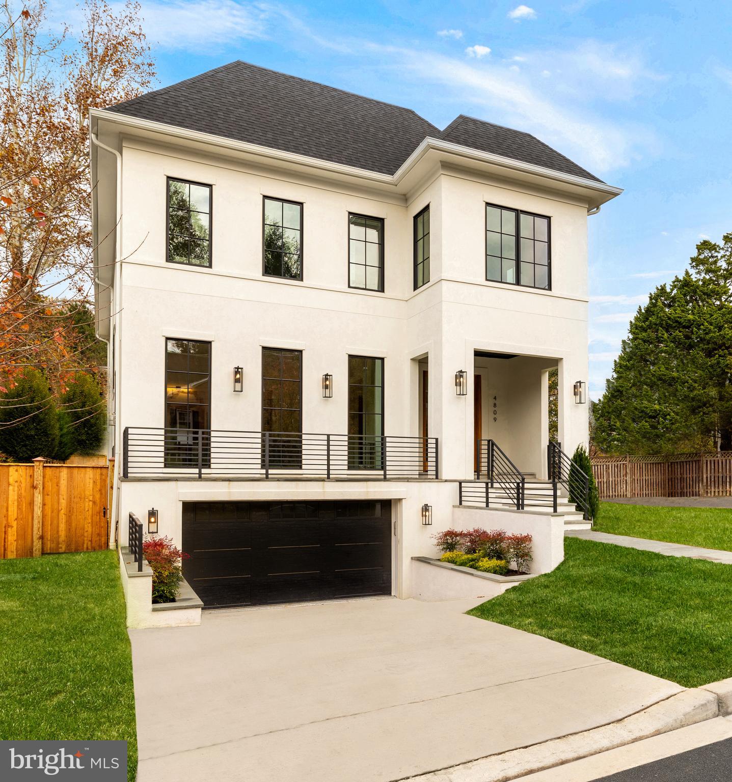 Nestled amidst a quiet, wooded setting in a highly sought after, centralized location within DC’s coveted Palisades neighborhood, 4809 V Street NW embodies elevated luxury living. A glamorous modern villa, the home represents a masterful collaboration between GTM Architects and Monument builders, employing the finest in materials and workmanship. An elevated patio and flagstone walkway converge beneath an entry portico, introducing a floor plan designed for contemporary lifestyles spanning a generous 7,800 finished square feet. The reception vestibule offers a dignified entrance and open sight lines to the rear of the home, while abundant natural light from a window wall and herringbone white oak floors augment the ethereal ambiance. Adjacent is the formal living room, a roaring fireplace compliments the floor-to-ceiling windows to create a space equal parts elegant and casual. A wide central hallway bisects the main level, with a work nook, formal powder room, and coat closet. Quintuple hinged interior doors throughout are a testament towards quality and attention to detail. As with the living room, the embassy-sized dining room exudes a level of refinement while maintaining a connection with the rest of the floor plan. Informal areas occupy the rear portion of the main level. The chef’s kitchen is characterized by high end white shaker cabinetry complementing unbroken slabs of marble cladding the backsplash and ten-foot waterfall center island. A commercial-grade Wolf range top, accompanying pot filler, hidden SubZero refrigerator and freezer, twin Bosch dishwashers, and additional appliance package creates a comprehensive suite of equipment. Across is the family room, accented by a modern linear fireplace framed by lighted shelving and a spectacular coffered ceiling. A wall of sliding glass doors accesses the rear loggia and lawn. On the upper level, the primary suite is an oasis occupying a dedicated wing of the home. A private terrace overlooks the grassy lawn and verdant foliage, offering a peaceful place to enjoy morning coffee. The stunning ensuite bath is a showstopper, with a double vanity and shower room including multiple heads as well as a freestanding tub. Two dressing areas, one of which features a center island, built-in vanity, and lighted mirror complete the primary. Three additional bedrooms on the upper level each feature walk-in closets, ensuite baths, and window treatments. On the top level is another bedroom suite with flexibility as an office, with a wall of custom built-ins. The sensational rooftop deck is accessed from this space, offering lounging al fresco with sweeping views. A game room with wet bar, easily adapted for use as a media space, completes the top level. The lower level revolves around a large, walk-up recreation room. An adjacent office is privately tucked away, while the fitness center is professionally set up with rubber flooring and mirrored walls. A sixth bedroom suite is fully self-sufficient with private washer and dryer hookup. The attached two-car garage, a rarity in the city, is directly accessed from this level. State-of-the-art systems, including Legrand lighting, a four-level elevator, multi-zoned HVAC, Honeywell security, and interior fire system enhance both livability and peace of mind. Outside, the deep 0.17 acre lot extends far beyond the rear loggia and is fully fenced. Mere steps to neighborhood shops, restaurants, and major access routes both in and out of the city, 4809 V Street NW is a masterful blend of convenience and amenities in a luxurious package and incomparable location.