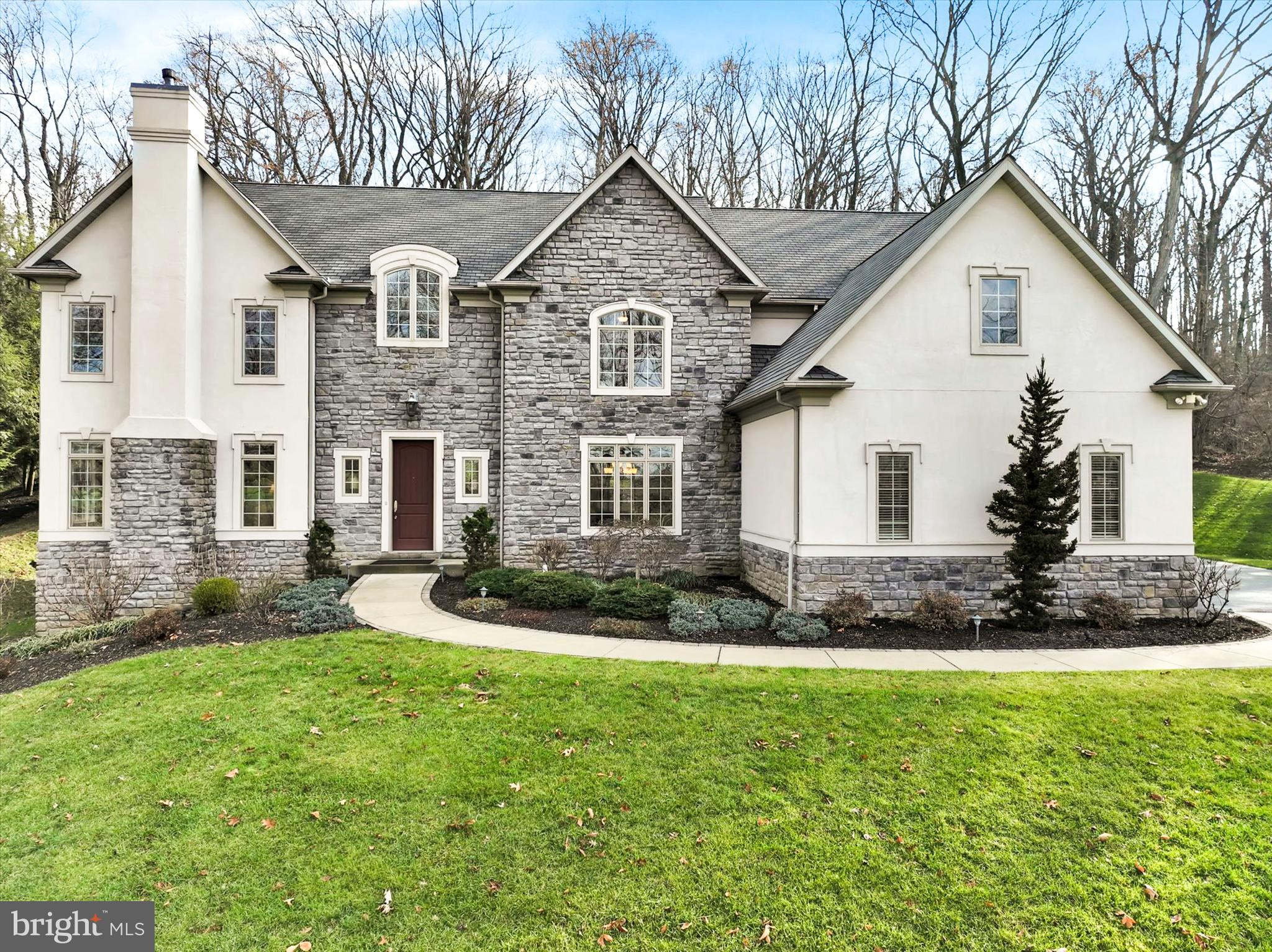 Exceptionally clean and meticulously maintained luxury home located in the desirable gated community of  Inverness at Spring Ridge in the Wilson School District with easy access to highways 422/222 and convenient to shopping and amenities.  This elegant home sits on almost 3 acres of private wooded property with great views from the front and rear of the home. Extensive professional landscaping with lighting, perennial flower beds, and an expansive retaining wall in backyard.  The interior is a wonderful open floor plan with stunning coffered, vaulted, tray and 11 ft + ceilings with ornate arches, moldings, columns and oversized trim and features a whole home stereo system. Brazilian Redwood hardwood flooring is throughout the majority first and second floors. Foyer boasts an upscale stone and tumbled marble inlaid travertine floor, flanked by a formal dining room with tray ceiling and 4 floor to ceiling wall niches. Across the foyer is the living room with decorative coffered ceiling and gas fireplace with custom detailed woodwork. Front staircase is adorned with wrought iron balusters. The family room features 6 large windows with wonderful views of the back yard and wood line and has a full wall custom built-in entertainment center with fireplace.  Off the family room sits an executive study with custom wood shades, built-in credenza and stately dark walnut built-in bookshelves. The heart of the home is the gorgeous Epicurean kitchen with two islands, elegant quartz countertops, custom white cabinetry, Blanco farmhouse sink and second full-size sink in island with designer Kohler faucets. Triple osmosis drinking system, two dishwashers, two ovens, pot filler, top of the line professional chef-grade Viking appliances including a built-in Viking refrigerator/freezer. Six burner gas Viking cooktop with glass mosaic backsplash surrounded with natural stone tiles and dual pull-out spice racks. Large walk-in pantry with built-in shelves. A well placed mud room sits off of kitchen leading out to the garage with large built-in bench, cubbies, and coat hooks.  The first floor also features 2 well placed powder rooms.  The 2nd floor features a luxurious and spacious owners’ bedroom suite with sitting area and generous custom closet system with island. Suite also includes spa like bathroom with tiled shower with glass doors and deluxe Kohler rain shower, wall sprays and shower wand and a large Kohler built-in jetted tub. The center of the 2nd floor features a spacious and relaxing, vaulted retreat with two-story windows offering captivating views of the woods and includes a custom dark walnut built-in entertainment center.  2nd floor also features 3 additional spacious bedrooms each with large walk-in custom closets, loft area/homework area near the back staircase to kitchen and a convenient second floor laundry room. An inviting French door leads to the finished lower-level with endless potential for multiple uses including exercise rooms, craft room/office, or two additional bedrooms with windows.  Lower level also has a large two room deluxe bathroom with beautifully detailed tiled shower, generous storage rooms,  family/movie/game room and bar/kitchenette with beverage/wine refrigerator and microwave. Oversized three car garage with epoxy flooring, utility sink and ample storage space. This home is absolutely immaculate and all mechanicals are top notch and meticulously maintained.