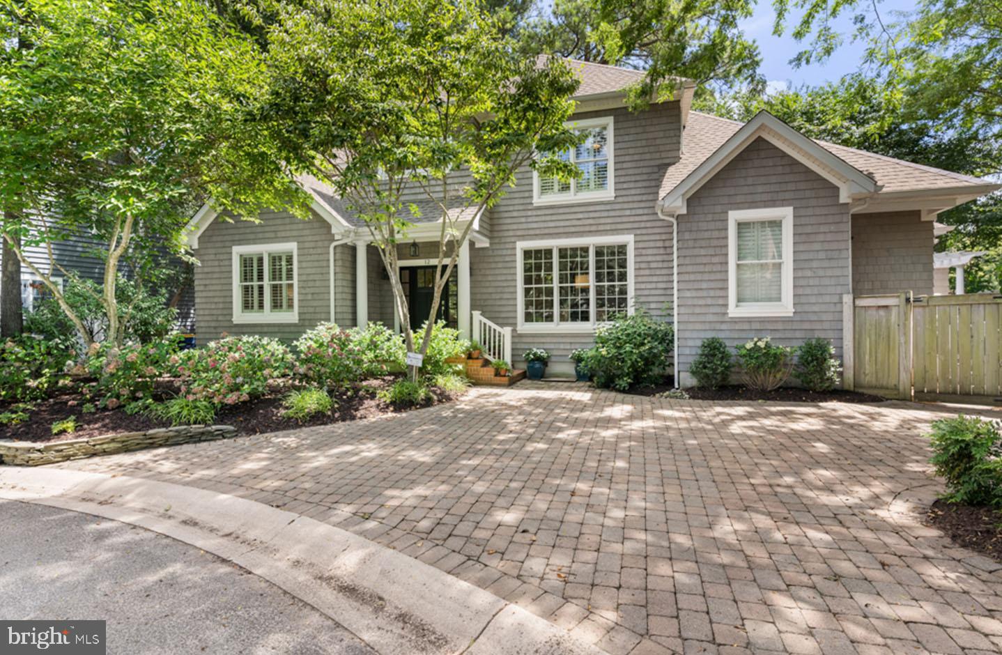 Enjoy complete privacy and serenity from one of Rehoboth’s most exclusive locations! 12 Saint Michaels Place is tucked away on a quiet cul-de-sac where the only visitors are friends and families of the neighboring homes. This coastal style residence has been recently refreshed with shake siding and new exterior trim, a new roof in 2021 and professional landscape with beautiful hydrangeas and natural beach grasses. Upon entry, you will be wowed by the gorgeous oak floors that meander throughout. Ideal for entertaining, 12 Saint Michaels features a formal dining area complete with wall-to-wall cabinetry and walnut counters. The gourmet kitchen boasts beautiful quartz counters, fresh white cabinets, stainless appliances, a walnut topped island, dual pantries and a spacious eat-in breakfast nook. A comfortable family room adjoins the kitchen and features a dual-sided wood burning fireplace and easy access to the rear patio. Custom built-ins and a dual-sided wood burning fireplace accent the great room, while dramatic vaulted ceilings and floor to ceiling windows flood the space with natural light. The primary suite is perfectly positioned on the first level complete with an ensuite bath and laundry closet offering the convenience of single level living. This unique floor plan features 5 bedrooms total, 3.5 baths and approximately 2,900 square feet of heated living space. Property owners will appreciate the rear yard, fenced for privacy, the outdoor shower, and the large patio covered by a custom pergola. This classic coastal home is convenient to the beach, downtown shops and amenities! 12 Saint Michaels Place leaves little to the imagination, do not hesitate on this excellent opportunity!