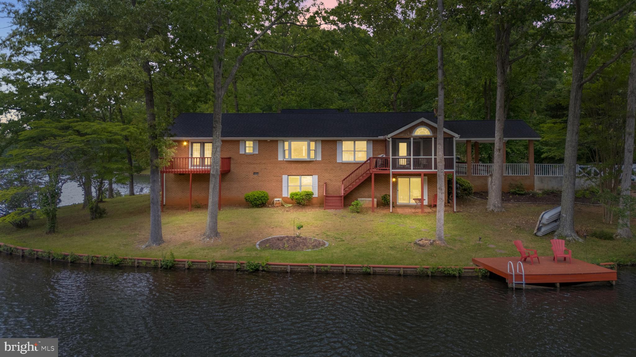 Beautiful water views surround this exceptional waterfront retreat at 216 Wilderness, offering an extraordinary 273 feet of shoreline on scenic Lake Keaton. Tucked within the highly sought-after gated community of Lake of the Woods, this lovingly maintained all-brick home combines privacy, comfort, recreation, and breathtaking natural beauty in one unforgettable setting. Fully renovated in 2026 and thoughtfully updated throughout, this home is designed for those who appreciate relaxed lake living with modern conveniences.
Recent improvements include luxury vinyl plank flooring, fresh paint, a new roof, new bay windows, updated carpeting, stylish lighting and ceiling fans, refreshed screened porch finishes, a new dishwasher, new gutters, and a heat pump installed in 2023 — along with many additional upgrades. A whole-house generator provides added peace of mind, while the age-in-place floor plan offers the ease of main-level living for everyday comfort and convenience.
The spacious 4-bedroom, 3.5-bath layout is ideal for full-time living, weekend escapes, entertaining guests, working remotely, or simply enjoying a peaceful waterfront lifestyle. The heart of the home is the beautifully flowing kitchen, dining, and family room area, where expansive lake views create a bright and welcoming atmosphere. The kitchen features a granite island perfect for gathering, preparing meals, or enjoying quiet mornings overlooking the water.
The primary suite is a private sanctuary featuring its own waterfront balcony — the perfect place to begin the day with coffee and calm lake breezes. A spacious walk-in closet and private bath complete the retreat. Additional bedrooms are generously sized and filled with natural light and tranquil water views. Large windows throughout the living and dining rooms invite the outdoors in and create a warm, relaxing ambiance throughout the home.
The screened porch off the family room offers a seamless blend of indoor comfort and outdoor beauty — an inviting space for afternoon tea, sunset dinners, entertaining friends, or simply unwinding while enjoying peaceful lake views and gentle evening breezes. The lower level provides additional flexible living space ideal for a game room, recreation area, guest suite, or hobby space, complete with its own bedroom and bathroom. Abundant storage throughout the home adds even more functionality.
Step outside and embrace true waterfront living. Fish from your private dock, launch a kayak, swim, boat, or simply relax along the bulkhead shoreline while taking in the beauty of the lake. There is room for a pontoon boat, and a paddleboat conveys with the property so your lake adventures can begin immediately. Kids and guests of all ages will find endless ways to enjoy this welcoming waterfront escape.
Life at Lake of the Woods offers far more than just a beautiful home. Residents enjoy access to two lakes, nine sandy beaches, two community pools, tennis and pickleball courts, walking trails, fitness facilities, equestrian amenities for boarding and riding, camping areas, and a variety of clubs and social activities. Golf enthusiasts can also enjoy the community golf course with available memberships.  Additional conveniences include 24-hour security, fire and rescue services, and community trash service.
Whether you are searching for a year-round residence, a weekend retreat, or the ultimate staycation home, 216 Wilderness delivers the rare combination of expansive waterfront, updated living spaces, resort-style amenities, and an easy commute to Fredericksburg, Northern Virginia, Washington DC, and Richmond — along with nearby wineries, historic sites, shopping, dining, and healthcare facilities.This is more than a home — it is a lifestyle. Schedule your showing now as this house lives up to the description.