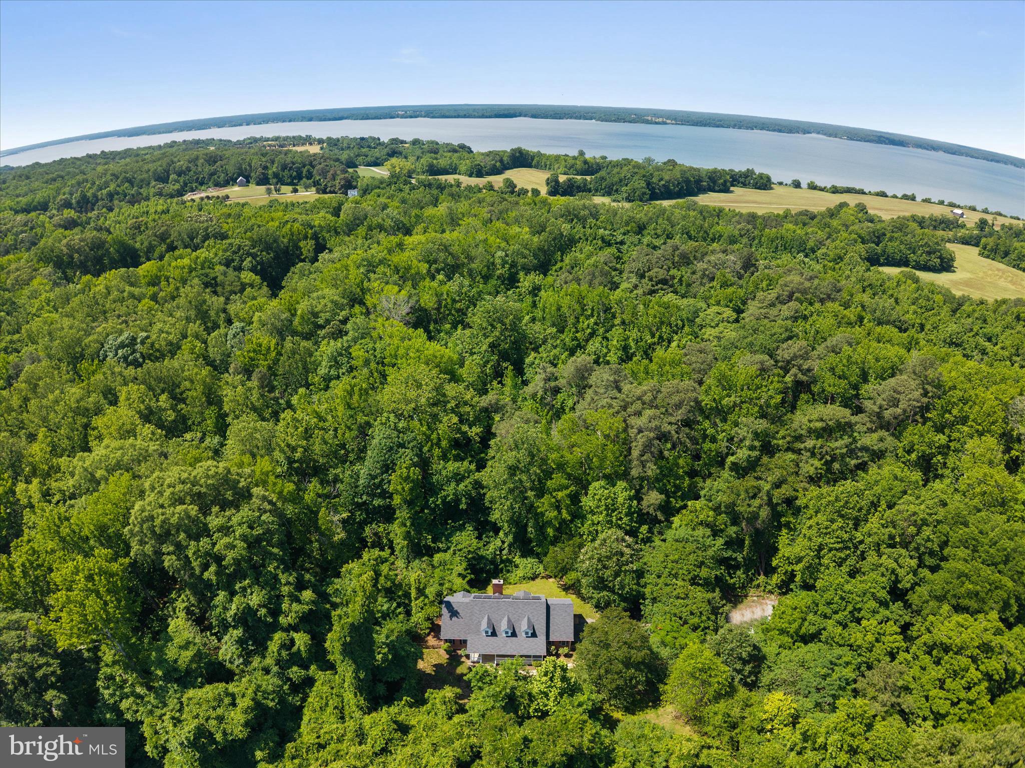 Tucked at the end of a long private driveway, this nearly four-acre property backs directly to Jefferson Patterson Park - 560 acres of protected woodland and Patuxent River shoreline that frame the home in lasting privacy. A peaceful, wooded setting like this is genuinely hard to find. Inside, 3,682 square feet live large. Real white oak hardwood floors run through a sun-filled main level that includes a dedicated home office and a spacious owner’s suite - all on one floor - with a dual-sink en suite, soaking tub, and walk-in closet. The kitchen is built for everyday life: a farmhouse sink, generous oak cabinetry, a full-size refrigerator and freezer, and not one but TWO pantries. Upstairs, oversized bedrooms with deep closets offer plenty of room to spread out, and a convenient main-level powder room rounds out the 3.5 baths. Recent updates make it move-in ready: a newer roof, an efficient two-zone heat pump system, and Tesla solar that keeps electric bills remarkably low - averaging around $150 a month. Add a welcoming front porch, a rear deck, a fully fenced yard, a water softener, and expansive attic storage, and the everyday details are handled.
All of this sits in the middle of Calvert County, the everyday conveniences of Prince Frederick, and the waterfront dining of Solomons Island — with no HOA. Come experience the quiet for yourself! Fireplace being sold as-is since it has not been used since homeowner has lived here.
