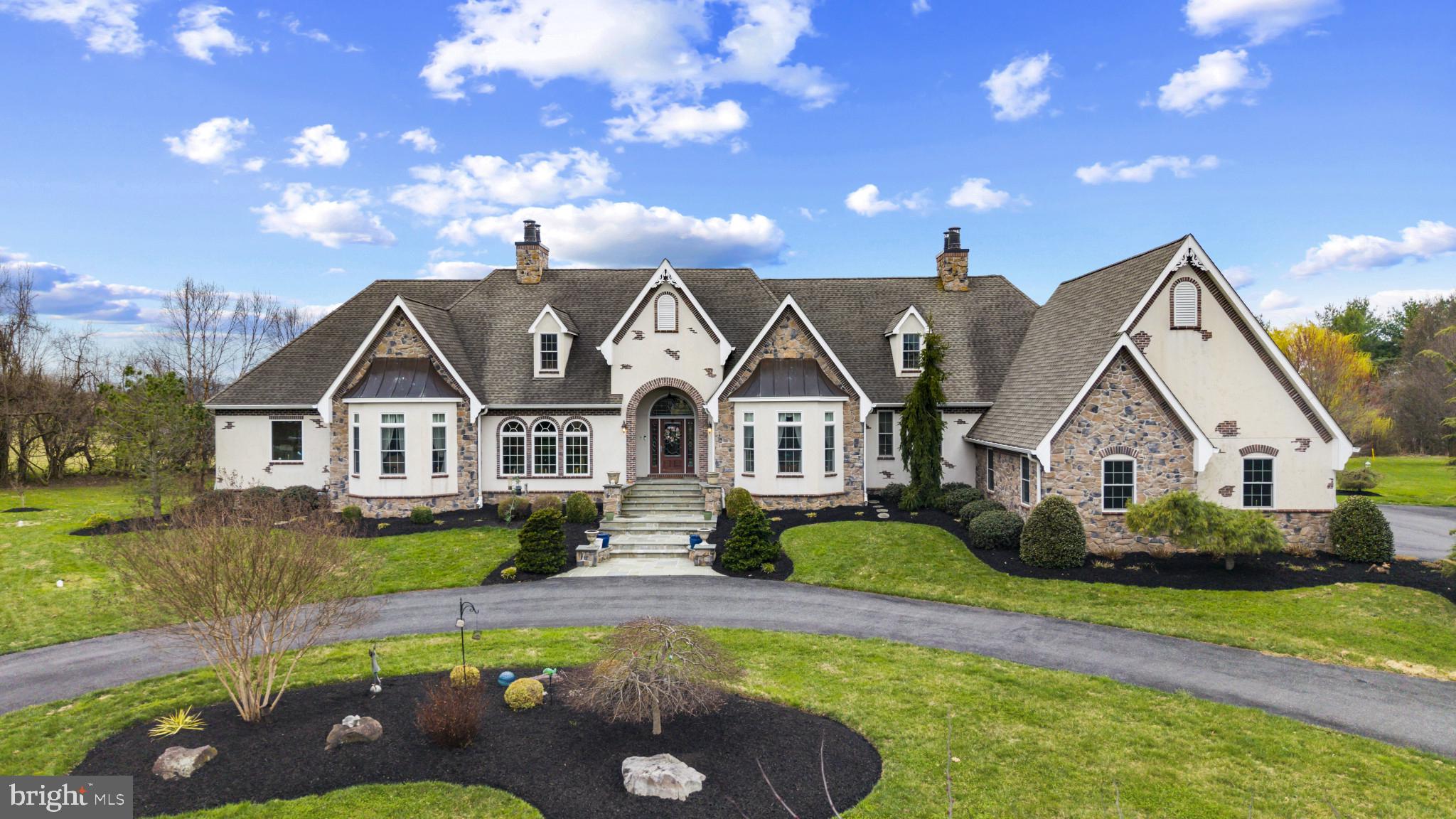 Nestled in the distinguished, quiet neighborhood of Churchville Meadows, with convenient access to I-95 and nearby train stations, this extraordinary custom ranch-style home offers seamless connectivity to Washington, D.C., New York City, and Philadelphia. With over 7200 finished square feet, this remarkable residence features two complete levels of living—essentially two homes in one—each with its own chef’s kitchen and a private elevator providing effortless access between floors. Built in 2012, this home offers 6 bedrooms and 6.5 bathrooms, highlighted by 12-foot ceilings and custom millwork throughout. It includes dual HVAC systems with 8 temperature zones, two tankless water heaters, and a whole-house natural gas generator. Additional conveniences include a 3-car garage, circular driveway, and laundry rooms on both levels. A stately two-sided fireplace, one of five, all thermostatically controlled,  welcomes you into the breathtaking Great Room, defined by arched doors and windows to create architectural symmetry that travels throughout the home. The open layout flows into a spacious dining area,  family room and  upper-level chef’s kitchen, featuring solid, two-toned cherry cabinetry, a 5-burner Wolf cooktop and range hood, double oven, granite island with prep and seating areas, built-in bar with beverage refrigerator, glass front lighted cabinetry and pass-through to Great Room. Separate catering kitchen/butler pantry includes full refrigerator, built in cabinetry and sink. The formal dining room is an octagonal showpiece enhanced by a wall niche with marble ledge, pass through window with matching marble detail and elegant arched openings. The expansive primary suite features a Heat & Glo fireplace, private laundry, and access to a covered Italian/Mediterranean style balcony overlooking the pool, along with two adjoining luxury suites, each with sitting areas, custom  walk-in closets, and spa-inspired baths, including a clawfoot soaking tub with Swarovski crystal chandelier and fixtures. Every closet in the home designed and outfitted by California Closets. A private study with built-in bookcases and fireplace sits just off the primary suite. An additional upper-level bedroom offers a private bath and sitting area. The main level also has a well-appointed and beautiful half bath. Take the elevator to the  lower level which includes four spacious bedrooms—two with en-suite baths and two sharing a full bath. All baths have dedicated linen closets.  There is also full laundry room. Designed for entertaining, this level features a soundproof  state of the art 26-foot theater with reclining seating for nine. Each seat has an integrated tray table and cup holder. The custom lighting choices create a true theater experience. Attached media room is complete with premium media systems and Roku integration all controlled by remote. The theater room alone is valued at over $100K.   There is an amazing wine room with built in storage and elegant finishes built to stay naturally cool with a lovely glass door. A second full kitchen with tiered granite countertops, GE Profile appliances, Wolf cooktop, and bar seating opens to a spacious entertainment area with two sided fireplace, teak flooring, and flexible recreation space, enhanced by a whole-home Sonos speaker and intercom system. Outdoor living is exceptional, with a 33,000-gallon saltwater pool, three waterfalls, kiddie pool, matching pool shed, and bluestone patio with lighting, fans, and retractable awning. The space is prepped for an outdoor kitchen with gas hookup, sink rough-in and refrigerator outlet. A covered balcony which can be accessed from both the Great Room and the primary bedroom features a Carolina Blue ceiling,  fans and retractable 18' Sun Setter screen adds additional outdoor enjoyment. Full House Generator. With a French Provincial front and Mediterranean-inspired rear, this home blends elegance, functionality, and ideal multi-generational living.
