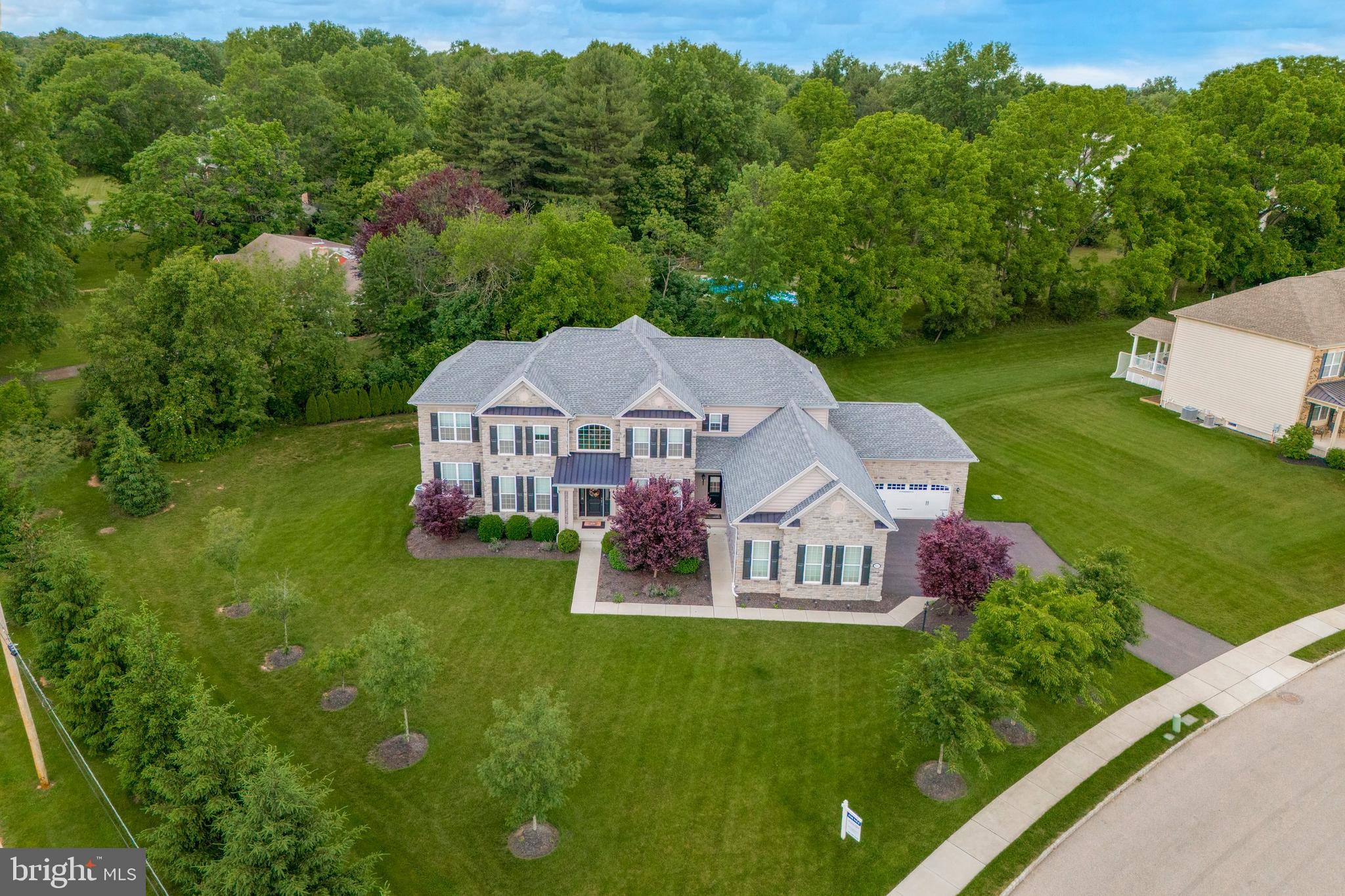 Step inside this beautifully appointed stone colonial home located in the Souderton School District and built  by Toll Brothers.  Welcome to 540 Grayson Lane!  Let new memories unfold in this spacious, nearly 5800 square foot home.   As you enter into the grand foyer, you will notice the cathedral ceilings, the detailed carpentry, the plank hard wood floors and gorgeous staircase with breathtaking chandelier.  Off of the foyer you will find a formal living area and french doors to a well appointed office.  On the other side of the foyer is your stunning dining room with crown molding, chair rail, tray ceiling and detailed carpentry work for those special dinners with your friends and family. The center hall will lead you to the oversized sunken Great Room with stone fireplace. The  gourmet kitchen is a chef's dream!  Tons of counter space and 42” cabinets, HUGE island, and a large walk-in pantry. Off the kitchen you will find a laundry room with plenty of space to organize and fold clothes.  As if that isn't enough, there is another bedroom/office, full bath and wet bar on the first floor.   Need even more space for fun and entertainment?  Let's go explore the finished basement that is nothing short of amazing!  Spectacular entertainment area, a workout area, a bar and full bathroom is what you will find, as well as an endless amount of storage.  At the end of the day, you will not be disappointed retiring for the evening in the primary suite with a French double door. The hardwood floors continue into the main bedroom with attached sitting area that allows you to lounge, read or work.  There's not only ONE walk-in closet in the primary suite, but TWO, the second (28' deep!) with its own dressing area.  There are three other bedrooms on this level as well as two more hall bathrooms. The princess/prince suite is close to the back stairs and includes its own ADDITIONAL full bath.  The outdoor space is truly amazing, with oversized TREX deck perfect for summer BBQs and entertaining with friends and family.  Oversized five car garage for all your vehicles and plenty of room for a workshop.  All of this located minutes away from major thoroughfares, Skippack Village, shopping and dining!