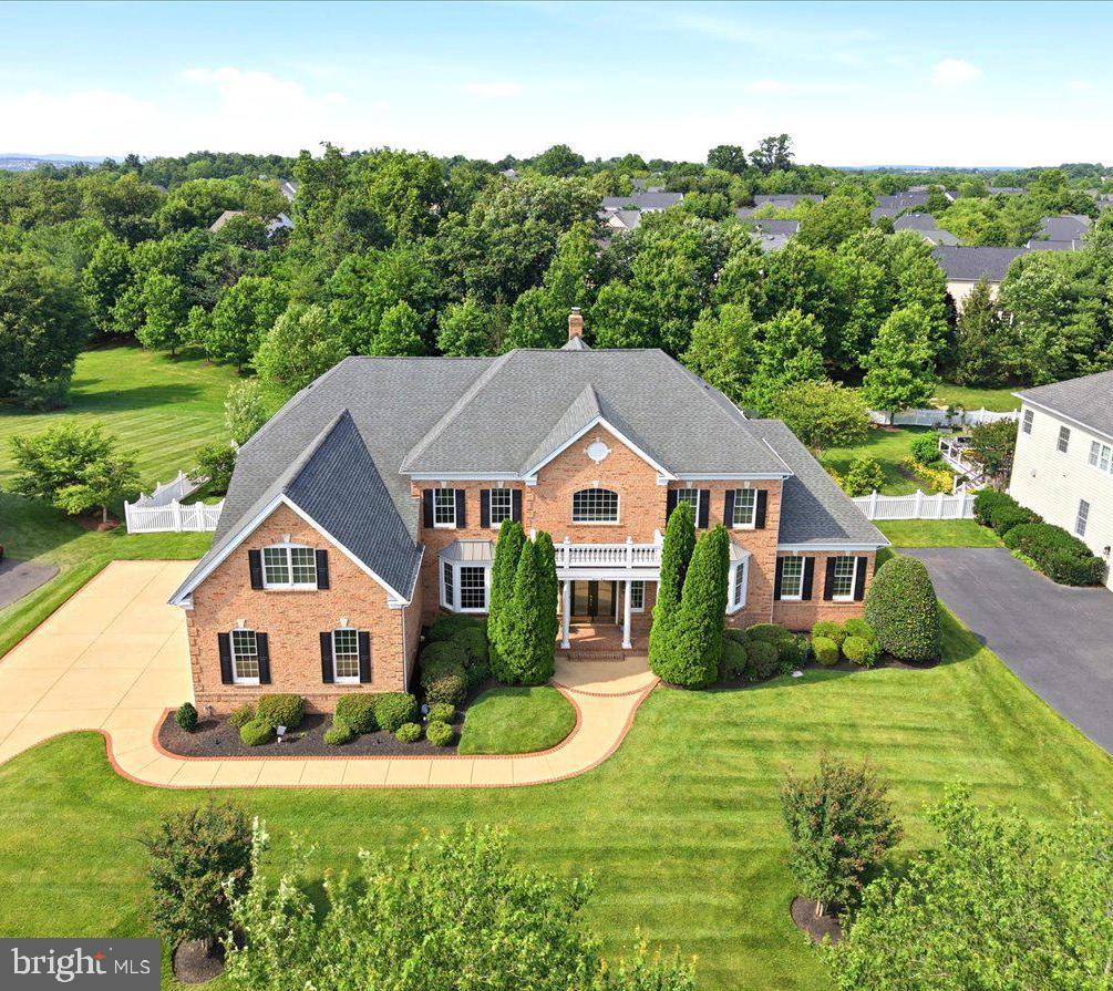 Welcome to an extraordinary Henley model estate in The Chase at Belmont Country Club, where timeless elegance, grand architecture and resort-style outdoor living create an exceptional lifestyle. Offering more than 8,000 square feet, this impressive residence features 4 upper-level bedrooms, 5 full baths, 2 half baths, a three-car garage, and a premium 0.57-acre lot backing to mature trees.
<br><br>
A dramatic marble foyer makes a memorable first impression with a sweeping butterfly staircase, wrought-iron balusters, Juliet balconies, and a stunning chandelier with a motorized lift. Rich hardwood flooring, extensive millwork, tray ceilings, and designer finishes flow throughout the main level.
<br><br>
Formal living and dining rooms provide elegant entertaining spaces, while a private study showcases custom wood bookcases, wood shutters, hardwood flooring, and a distinctive upholstered leather accent wall. The adjoining conservatory offers built-in shelving, custom shutters, and a wet bar with granite countertops and beverage refrigerator, creating the perfect library, lounge, game room, or music room.
<br><br>
The gourmet kitchen is the heart of the home, featuring a 10-foot granite island, brand-new 72-inch Sub-Zero refrigerator, GE Monogram stainless steel appliances, two Bosch dishwashers, abundant cherry cabinetry, walk-in pantry, and butler's pantry with sink. A spacious morning room provides flexible space for casual dining, hobbies, or gathering with family and friends.
<br><br>
The backyard is truly spectacular, offering approximately 1,100 square feet of heated outdoor living space. A screened porch features a soaring wood-plank ceiling, exposed beams, wood-burning stone fireplace, television, custom surround sound, ceiling fans and radiant heaters for year-round enjoyment. The outdoor kitchen includes a full stone bar, sink, refrigerator, generous prep space, television, and gourmet gas grill with vent hood. Mature trees and fencing create a private, resort-like setting.
<br><br>
Inside, the soaring two-story family room is filled with natural light from a wall of windows and features a coffered ceiling, fireplace, custom draperies, and a secondary staircase. Additional main-level conveniences include two powder rooms, a private mudroom entrance, and a spacious laundry room with utility sink.
<br><br>
Upstairs, hardwood flooring continues through the gallery overlooking the foyer. Each bedroom features a private bath and generous closet space. The luxurious primary suite offers a tray ceiling, sitting room, spacious bath with dual vanities, jetted soaking tub, separate shower, dual water closets, two large walk-in closets, and a bonus room ideal for a fitness studio, dressing room, nursery, office, or private retreat.
<br><br>
The finished walk-up lower level is designed for entertaining, featuring an expansive recreation room, custom wet bar with granite countertops, cabinetry, dishwasher, built-in beverage refrigerator, and full bath. Two exterior entrances provide direct backyard access, while large unfinished areas offer abundant storage and future expansion potential.
<br><br>
Additional highlights include four HVAC systems, steam humidifier, two tankless water heaters, holiday lighting package, wired security system, twelve-zone irrigation system with new control panel, and an oversized three-car garage.
<br><br>
Located outside the gates in The Chase, residents enjoy access to Belmont's coveted social membership amenities, including pools, dining, tennis, basketball, volleyball, soccer fields, playgrounds, and an active social calendar. HOA dues include Comcast cable and high-speed internet. Optional golf and fitness memberships are available to enhance the country club community experience.  An exceptional opportunity to own one of Loudoun County's most impressive luxury residences.