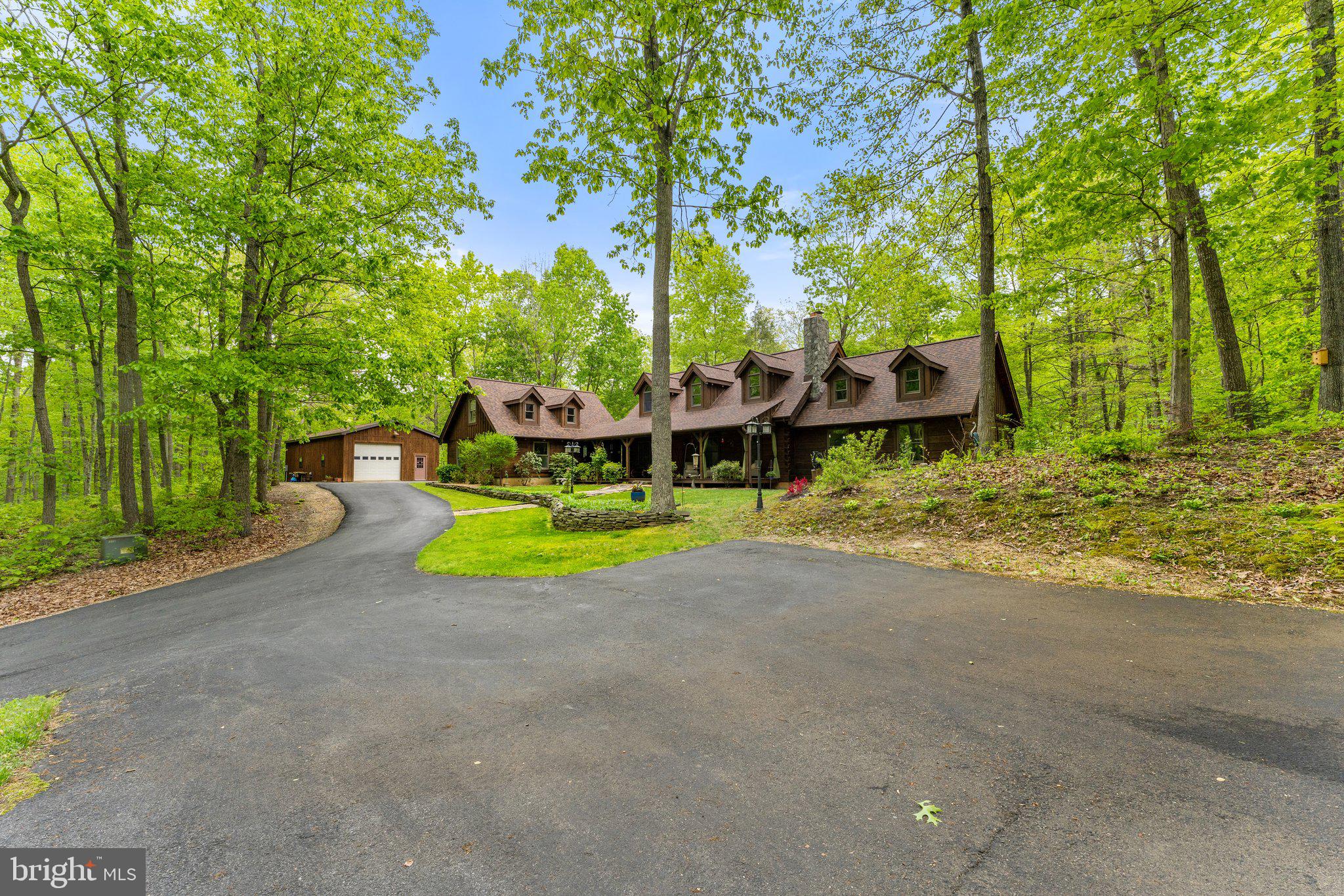 Welcome to 117 Valhalla Trail Ln!  The name describes this amazing property accurately.  As soon as you pull into the driveway you'll feel your stress level evaporate.  The winding driveway leads you to a gorgeous post and beam home that has been immaculately maintained, updated and loved.  The expansive front porch is large enough to host outdoor gatherings.  The main level is beautiful and inviting with an open concept living/dining and kitchen area.  The main level master suite is lovely, with doors to deck, luxury bathroom and walk-in closet large enough to call an office.  Gaze at the beauty of the birds, water fall and nature from your desk!  The upper level has an additional ensuite with private balcony, sitting room and game room, which can also be used as a bedroom.  The lower level has something for everyone, with 2 additional bedrooms, full bath, den and large rec room/media room.  A finished room is located above the attached garage which would make a wonderful studio or office.  The detached garage has a workshop and enough room for all your equipment.  Enjoy all that nature offers by hiking miles of trails that meander throughout the property, climb on the boulders or sit by the stream.  Beauty, peace and tranquility await!  This special property has 4 heating and cooling zones for efficiency and cost savings, hot water on demand system and 5-G cell service.  The adjacent 53 acres is included in the purchase!