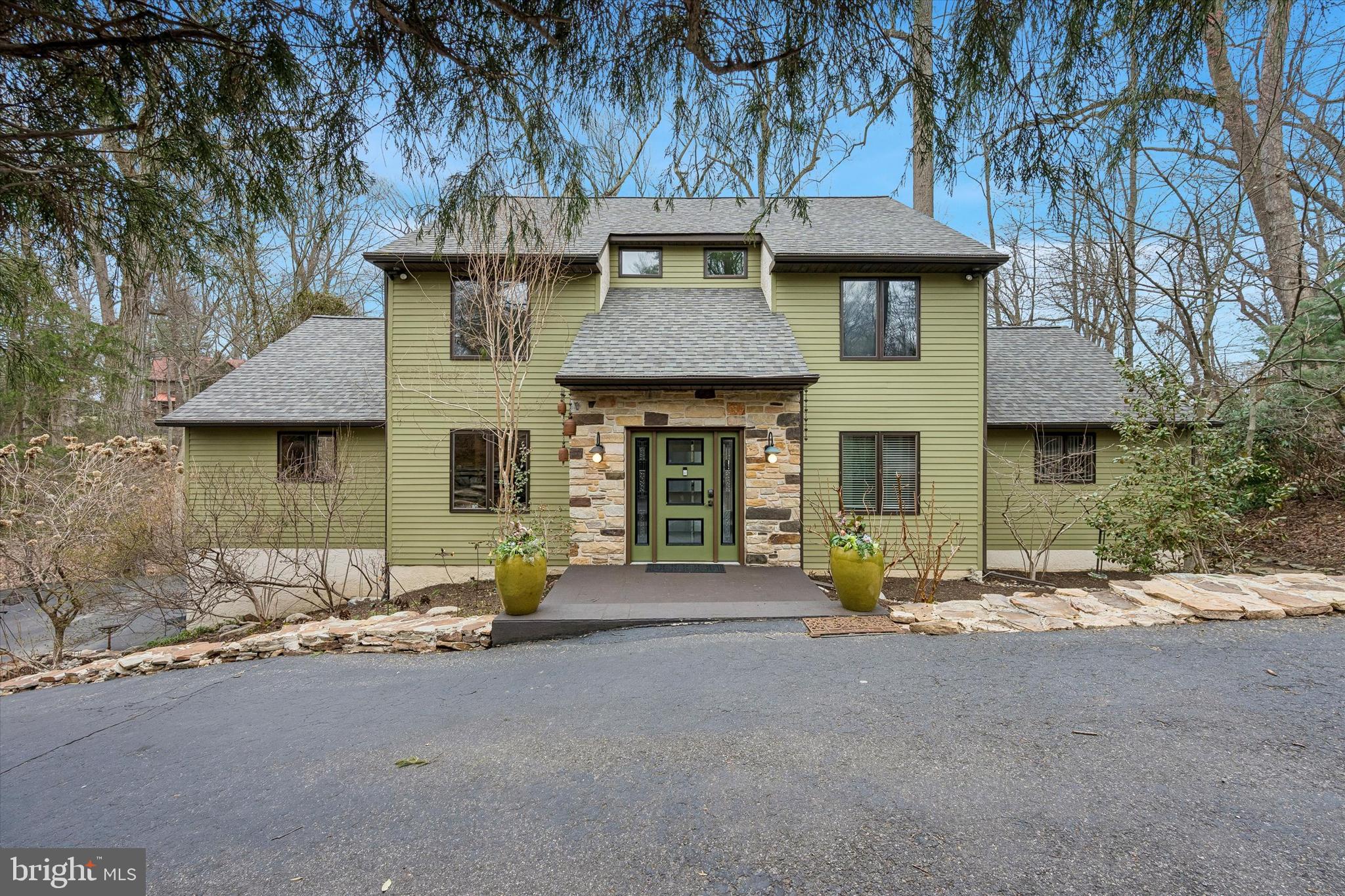 From the moment you step inside 2 Lake Avenue, you will appreciate the abundance of natural light, uniqueness, and the artistic quality of this home. This beautifully situated property offers generous space, flexibility, and a serene natural setting on nearly one acre (0.94 acres) in the desirable Wallingford-Swarthmore School District. 

Set on a picturesque lot overlooking a peaceful creek, this 4-bedroom, 3 full and 1 half-bath residence offers both privacy and convenience, with easy access to transportation and nearby amenities. Stepping inside, the spectacular Living Room draws your eye as it rises to the soaring open ceilings, creating an extraordinary sense of space. Full of oversized floor to ceiling windows that frame beautiful outdoor views, this room is anchored by a large fireplace, lending it style and warmth. Just off the Living Room is a bright and whimsical Craft Room with sliders to the deck, this wonderfully versatile space could be equally suited as a home office, studio, or hobby room. The oversized Eat-in Kitchen with ample custom oak cabinetry and large pantry, is both beautiful and functional, and is perfect for both casual family dining and impressive entertaining.  It flows naturally into the expansive Family Room, where walls of windows and sliders to the expansive multi-level decks offer breathtaking views of the mature trees in the backyard and sweeping lawn beyond. The first-floor Primary Suite offers new carpeting, a refreshed en-suite bathroom, and a large walk-in closet, as well as a balcony. There is also a powder room and Second Bedroom on the first floor, which is currently enjoyed as a home Office.  

Upstairs, the second-floor balcony overlooks the Living Room below, offering a stunning bird's-eye view of the soaring ceilings and scenic outdoor views. Two generous Bedrooms and an impressive updated Hall Bathroom are thoughtfully arranged adjacent to an open area, perfect for an additional family room, study space, or playroom. There is new carpeting on the stairs and throughout the second floor. There is also a large unfinished space, currently used for wonderful storage, but could be finished into an additional bedroom, guest suite, or bonus room, adding tremendous value and versatility to this home.

The fully finished, walk-out Lower Level is fabulous, and offers another wonderful recreation space and has plumbing for a kitchenette or bar area, an ideal setup for an in-law suite, au pair quarters, guest space or private office space, as this floor can be accessed directly from the lower portion of the driveway and the attached one-car garage. With a full bathroom and easy access to the fabulous deck and yard , this space is also perfect for entertaining and enjoying the pool table, shuffleboard and pinball machine with family and friends.  A cedar closet, laundry room, and unfinished storage area complete the lower level.

Whether hosting outdoor gatherings, enjoying a quiet evening surrounded by nature, playing games, or simply taking in the view, the outdoor space is exceptional and provides a rare and peaceful retreat for exploration and enjoyment.  A highlight, in addition to the sweeping views, is a very special custom-built Treehouse that appears to be out of a storybook, in addition to two fire pits for your outdoor enjoyment. A new roof installed in 2026 provides added peace of mind for years to come.

Despite its tranquil setting, the home is remarkably convenient. The Moylan–Rose Valley Station is accessible from the neighborhood, making commuting simple. You are also just minutes from the shops, restaurants, and community events in Media Borough, and you have easy access to Philadelphia International Airport.

Offering tremendous living space, flexibility, and a beautiful natural setting in a highly convenient location, 2 Lake Avenue is a wonderful opportunity to create your next chapter.