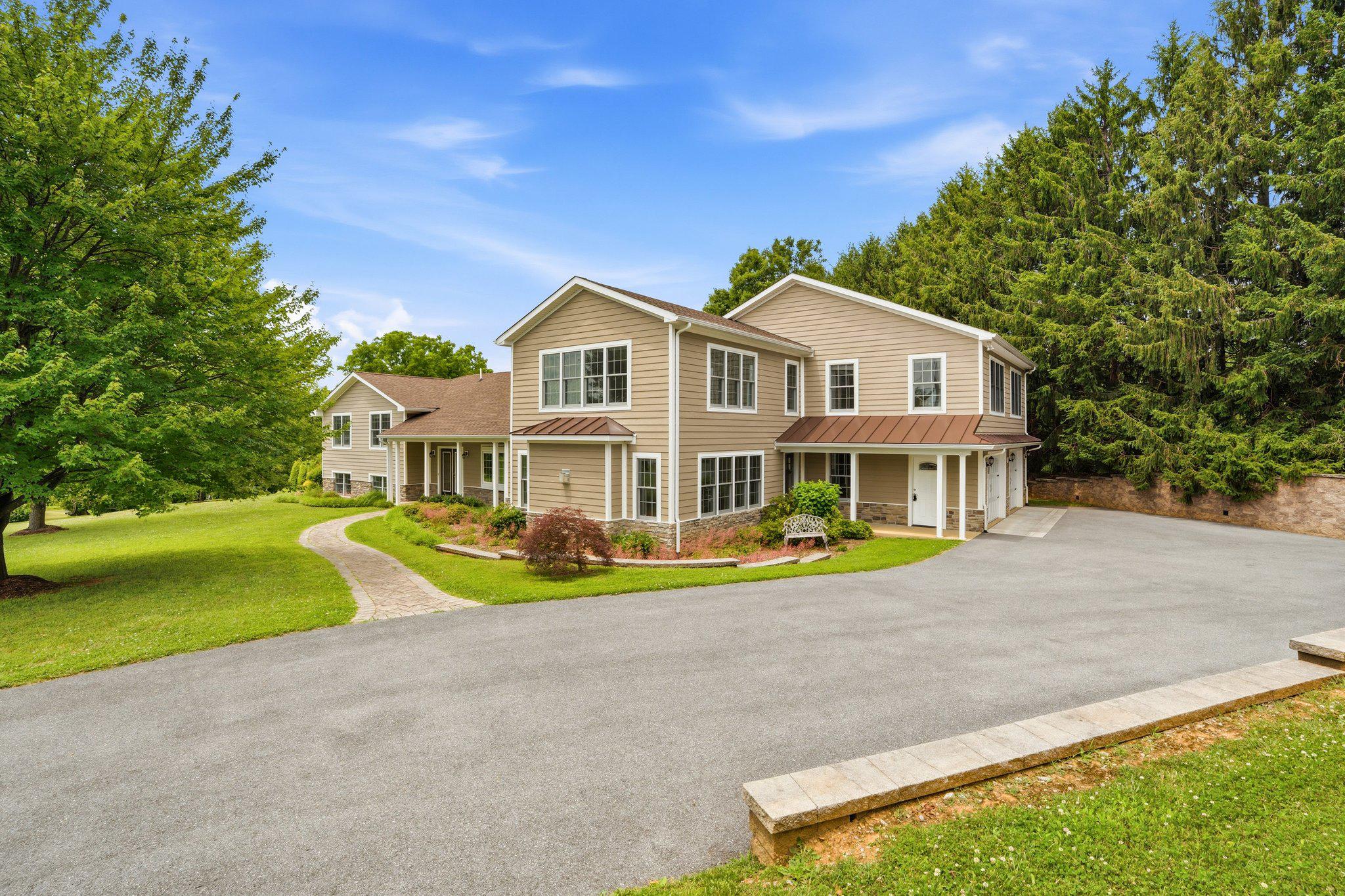 Overlooking Remsberg Park and set on 0.95 acres, this lovingly maintained, extensively expanded and renovated Middletown home offers 5,661 finished square feet, two private primary suites, exceptional gathering spaces, and a lifestyle centered around comfort, flexibility, and outdoor living.

The eat-in kitchen was renovated in 2016 and features hand-painted, all-wood custom cabinetry by Reaver’s Cabinetry, soft-close doors, granite countertops, an oversized island with extra-long storage drawers, and a custom butcher-block bar. Bamboo flooring extends through the kitchen and foyer, while a comfortable sitting area just off the kitchen features a propane fireplace and custom built-in cabinetry. The connected dining area is framed by a bay window overlooking Remsberg Park, creating an inviting space for everyday meals and larger gatherings.

A substantial two-story addition completed in 2019 dramatically expanded the home. The newer family room is anchored by a stone propane fireplace and provides generous space for everyday living and larger gatherings. A pantry and mudroom create a practical transition from the approximately 1,000-square-foot garage, which provides ample room for vehicles, storage, equipment, and comfortably opening car doors.

Two primary suites are positioned on opposite sides of the home, offering privacy and flexibility for multigenerational living, extended guests, or separate work-from-home needs. The newer primary suite includes a walk-in closet, private office or nursery, and a spacious bathroom with a soaking tub, large separate shower, private water closet, and dedicated local hot-water source. The second primary suite was also expanded to include a larger bathroom with heated flooring, a substantial walk-in shower, and a walk-in closet. Each primary suite opens to its own private balcony.

Additional upper-level space includes a sunroom reached by a wide hardwood staircase, a loft, flexible multipurpose space, an additional laundry area, and extensive storage. The finished lower level offers multiple recreation and hobby spaces, including a recreation area with a stone propane fireplace and room for a pool table, an additional propane fireplace, and an adaptable room previously used as both a playroom and exercise room.

Outdoor spaces include a small front porch, a larger rear porch, two private balconies, a pergola positioned for sunset views, mature trees, extensive landscaping, a partially fenced backyard, and a peaceful ornamental pond. Gardeners will appreciate the greenhouse and approximately 25-by-18-foot gardening shed, which may also offer potential for conversion into an office, studio, or creative workspace. An additional large shed provides generous equipment storage, while a covered hot tub is positioned close to the home for convenient year-round enjoyment.

In addition to the 2016 kitchen renovation, major improvements completed in 2019 include the two-story addition, the approximately 1,000-square-foot garage, a new roof across the original home and addition, LP siding with stone-look accents, Pella windows and patio doors, an upgraded electrical service, a new driveway, and retaining walls. The water heater was replaced in 2023.

Property is improved with four bedrooms; however, the existing septic system/percolation approval is rated for three bedrooms. Buyers should independently verify septic capacity, permitted bedroom count, and any future expansion potential with the appropriate county authorities.

Enjoy the setting and convenience of Middletown, with Remsberg Park walking trails and its creekside path nearby. Middletown Primary School and the local library are within walking distance, while Safeway, restaurants, shops, and everyday services are just minutes away.
