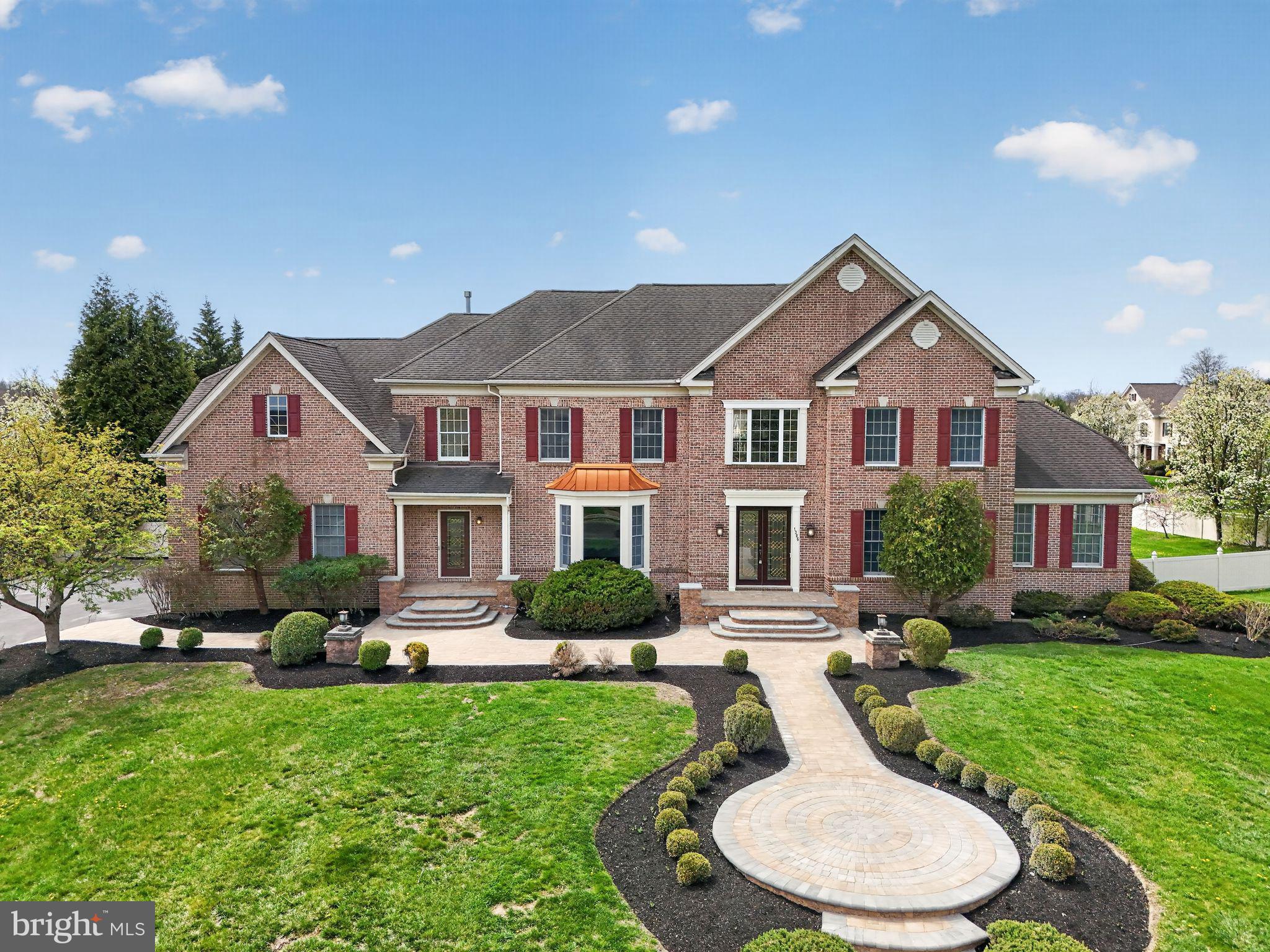 Located in the highly sought-after Highgate community of Ambler, this exceptional residence offers six bedrooms, five full baths, and two half baths across a meticulously maintained 1.34-acre corner lot. Surrounded by mature landscaping and perimeter plantings for ultimate privacy, the home reflects a remarkable level of craftsmanship, thoughtful design, and extensive upgrades. A stately brick front and newly redone paver walkways welcomes you to this fine home. Upon entering, the foyer makes an immediate impression with elegant marble flooring and a sweeping staircase featuring a custom, hand-carved walnut banister. To the right, the formal living room offers detailed custom molding and rich hardwood flooring, which flows seamlessly into an adjacent light-filled conservatory. This versatile space, featuring refined millwork and a full wall of windows, is ideal for a music room, library, or playroom. The formal dining room is designed for memorable gatherings, featuring an elegant chandelier, coordinating sconces, and beautifully crafted woodwork. The gourmet kitchen balances sophisticated aesthetics with high-end functionality, boasting custom marble countertops, a five-burner gas stove, and a massive center island crafted from a single slab of thick marble. Integrated storage solutions, including dedicated spice and condiment drawers, complement the walk-in pantry. For daily convenience, the laundry and mudroom feature a separate front entrance and direct access to the three-car garage. The kitchen opens to a bright breakfast room with direct access to the wraparound composite deck and gazebo, creating an effortless indoor-outdoor flow. The spacious family room is a showstopper, featuring coffered ceilings with gold accents, a soaring stone fireplace, and an expansive wall of windows. The main level also includes a well-positioned powder room and a first-floor bedroom suite with a full en suite bath, offering essential flexibility for guests or multi-generational living. Upstairs, the primary suite serves as a private retreat with backyard views, a tray ceiling, and a dressing room with vaulted ceilings. The suite features multiple storage areas, including an expansive custom walk-in closet and a secondary closet with a mini fridge. The marble-finished en suite bath includes dual vanities, a soaking tub, and a separate stall shower. Additional second-floor bedrooms are generously sized, featuring hardwood floors and ample light, including one with a private en suite and two connected by a Jack and Jill bath. The walk-out lower level significantly expands the home’s capabilities, featuring a dedicated spa area with a six-person jacuzzi, sauna, and steam shower. A second kitchen and large gathering area provide the perfect setup for an in-law or au pair suite. This level also includes a fitness room, game room, and a bright sixth bedroom with a walk-in closet and an additional powder room.  The exterior is truly unparalleled. The expansive maintenance-free deck overlooks a beautifully designed paver patio and a magnificent, heated saltwater pool. The pool area is enhanced by a pool house with two gazebos framing a full bath and changing rooms. The entire expansive yard is fenced for privacy and play. Entirely redone on the inside with new trim, custom millwork, and ornate fixtures, this home is an absolute BINGO for multi-generational families. Enjoy close proximity to Route 309, the PA Turnpike, the Power Line Trail, Simmons Elementary, Germantown Academy, golf clubs and the premier shopping and dining of Ambler.