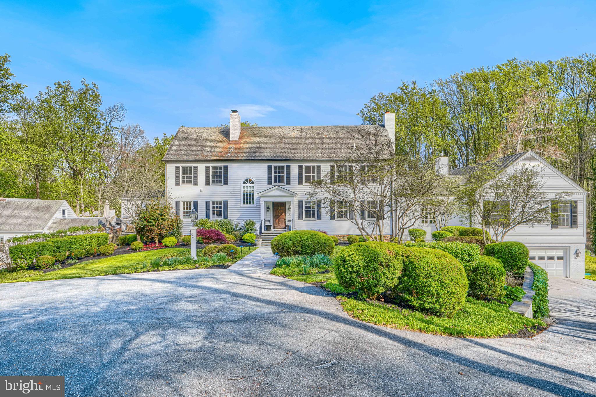Set on nearly five acres of exquisitely landscaped grounds, this extraordinary estate seamlessly blends historic character with sophisticated modern luxury. Anchored by an original log structure and thoughtfully expanded over time, the residence offers a rare combination of architectural significance, grand scale, and refined comfort.

A gracious foyer introduces elegant formal spaces, including a beautifully proportioned living room, an inviting library/den with custom built-ins, and a distinguished dining room adorned with classic millwork. Designed for both intimate living and large-scale entertaining, the home unfolds into a stunning sunroom with limestone flooring, skylights, and multiple French doors opening to expansive bluestone terraces.
At the heart of the home, the gourmet kitchen features marble surfaces, premium appliances, and custom cabinetry, flowing effortlessly into a warm and inviting breakfast room with fireplace. The dramatic family room—housed within the original historic log cabin—showcases vaulted beamed ceilings, wide-plank floors, and an impressive stone fireplace, creating a truly one-of-a-kind gathering space.

The main-level primary suite offers a private retreat of exceptional scale, complete with its own fireplace, spa-inspired marble bath, dressing room, and direct access to outdoor terraces and a private shower balcony. Multiple additional en-suite bedrooms, including a secondary suite with sitting room, provide comfort and flexibility for family and guests.

Additional amenities include a third-level recreation space, custom wine room, fitness studio, and a separate guest house with full living accommodations. Outdoors, the estate transforms into a resort-caliber setting with a heated pool, beautifully rebuilt pool house, outdoor kitchen, and extensive stone terraces surrounded by mature trees and curated landscaping.

A rare offering that combines timeless elegance, rich history, and modern livability in a truly exceptional setting.