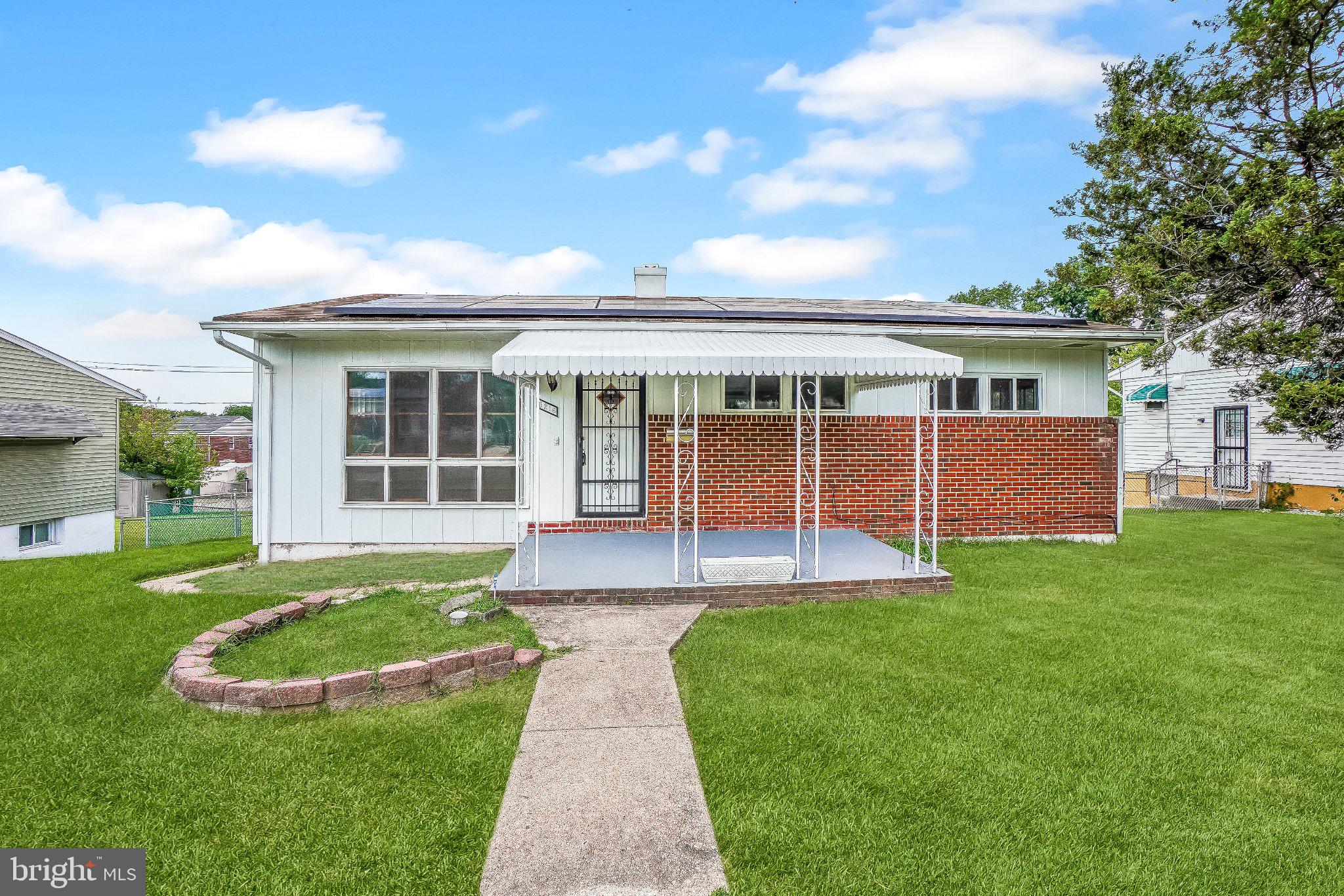 Light-filled brick-front rancher on a quiet, tree-lined block in Baltimore City's Hamilton Hills/Mount Pleasant area, offering one-level living with 3 bedrooms and 2 full baths, generous room sizes, and an abundance of natural sunlight throughout. Oversized picture windows fill the living room and bedrooms with sunshine, while freshly refinished hardwood floors and fresh paint brighten the main level. The kitchen offers ample cabinetry and counter space, with a separate dining room ideal for everyday meals and entertaining. Downstairs, a fully finished lower level with windows for natural light adds substantial additional living space, featuring a spacious wood-paneled rec room with custom built-in shelving and a kitchenette/wet bar area, along with a dedicated laundry area and a full bath, ideal for a home office, media room, or guest suite. Outside, enjoy a large, fully fenced rear yard with a concrete driveway off the rear alley offering parking for up to 3 cars, perfect for outdoor entertaining and everyday convenience. The location offers easy access to Harford Road and Perring Parkway for a quick commute into downtown Baltimore and beyond, and the home is located just minutes from Mount Pleasant Park and Golf Course, Herring Run Park, and MedStar Good Samaritan Hospital. This solid brick rancher, set on a leafy, tree-canopied block, offers comfortable space, abundant light, great bones, and an incredible yard, complete with a large covered brick rear patio ideal for outdoor dining and relaxing. Schedule your tour today.