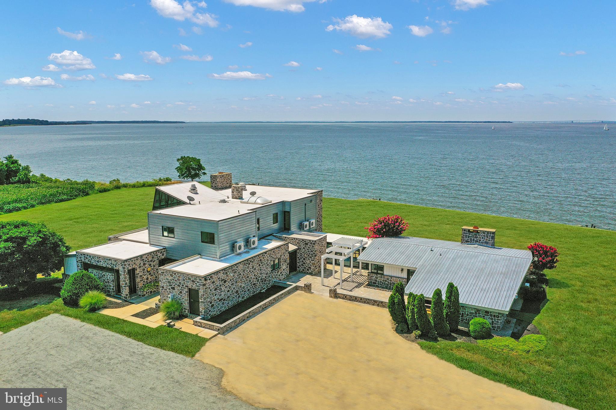 Wake Up with Breathtaking Sunrises and Close Your Day with Colorful Sunsets in Your One of a Kind Chesapeake Bay Custom Contemporary Waterfront Home on a Very Private 4.67 Acre Lot !   Newly Renovated with an Eye for Entertaining, You and Your Guests will Enjoy the the Dramatic Lines, Walls of Windows, Panoramic Views and Open Spaces That will Easily Accomodate Large and Small Gatherings.   This 8140 SF,  6 Bedroom, 5 Full Bathrooms and 2 Half Bathroom will Easily Sleep 16 People.  The Main House has a main level Primary  Bedroom with Ensuite Bath and Private Patio, Upper Level Primary Bedroom with Sitting Room and Ensuite Lavish Bath, A Guest Room with Ensuite 1/2 Bath and then a Bunk Room with 4 Built In Bunks!  The Attached Guest House has a Second Kitchen, Living Room, Guest Bedroom and Then Bunk Room with 4 Bunks Again.  This Home Can Be Accessed with Private Entrance or Via Spacious Foyer.  Nestled on 4.67 Private Acres with 900' on the Chesapeake Bay, this Estate Is  Perfect   For Family /Extended Family  or Weekend Retreat with Entertaining and Guests.   Yes....You Do Deserve This.  Schedule Your Tour Today and Experience the Chesapeake Bay .
