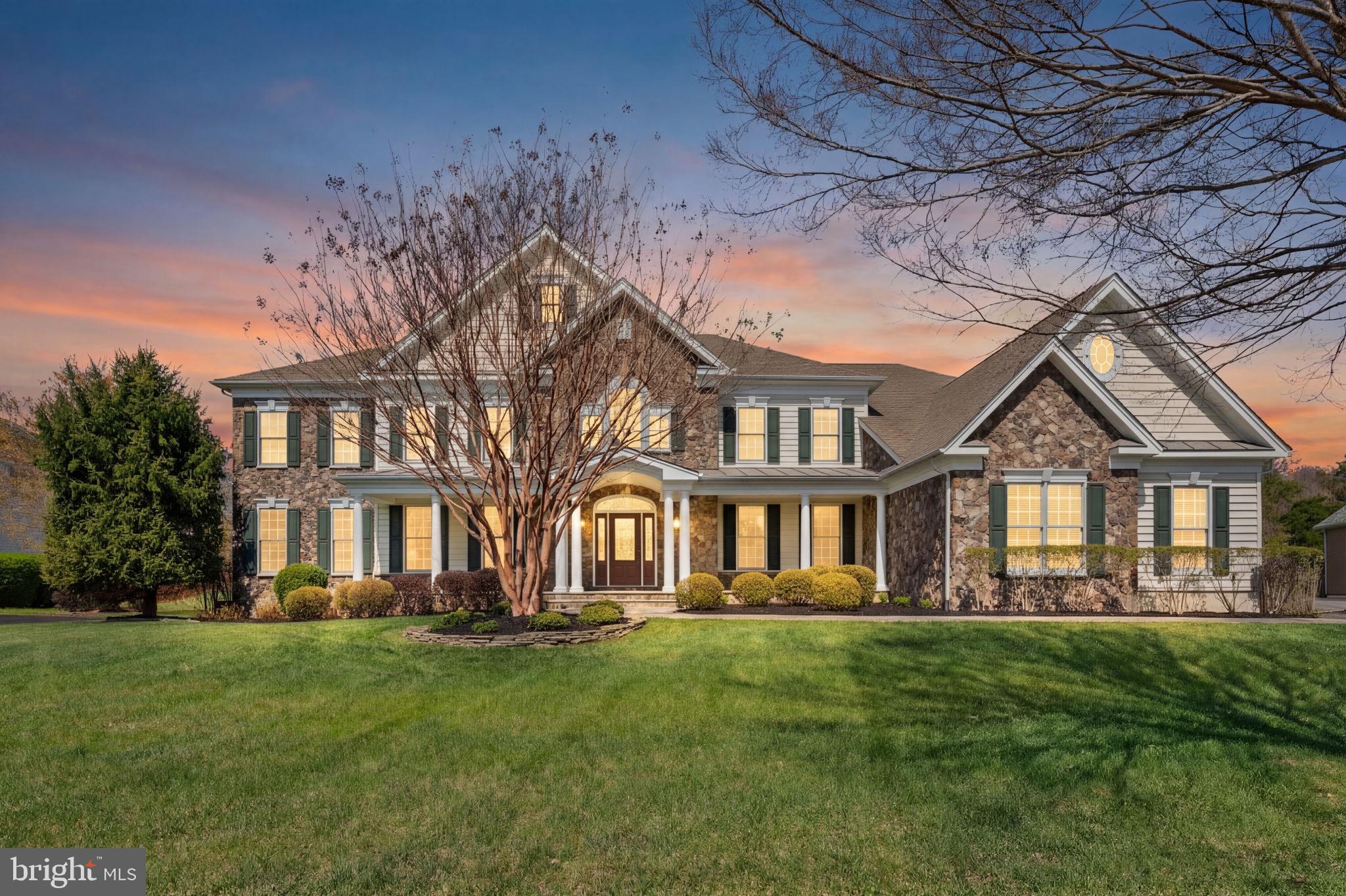 One of largest estate homes in Dominion Valley Country Club.  This Hampton Estate model situated on .65 acre private lot has multiple bumpouts with over 9300 finished sq. ft. on 3 levels.:  Family room extension, rear sunroom, side solarium and 5th large bedroom on upper level.  This home has been lovingly maintained by original owner.  Come and enter onto the flagstone walkway leading to the wide covered porch with stone elevation and columns. Leaded glass front door with arched window graciously beckons you into the home.  Wide dual staircases with wrought iron railings are the centerpiece once inside the soaring two story foyer.  Hardwoods throughout most of main level.  Abundant crown moldings, wainstcotting, shadowbox molding and beamed coffered ceiling throughout main level.  Spacious living areas with large dining, living, study, family room, and side solarium.  White built-in bookcases in study.  Marble flooring in sun-filled solarium.  Enormous kitchen with cherry upgraded cabinets, huge center island with seating, large breakfast room and loads of counter space.  Appliances replaced in 2021.  Sunroom opens to exterior patio with covered pavilion -- great for entertaining in rain or shine!  Huge rear yard with picket fencinig.  Plenty of space for additional outdoor living with level yard.  View backs to dense trees.  3 car side load garage with exit door to side yard.  No HOA restrictions on this lot for pool, playset, or sports court.  Upper level with 5 sizable bedrooms.  Primary with tray ceiling and large sitting area.  Luxury primary bath with dual vanities, large soaking tub, double shower w/bench seating and dual water closets.  Enormous closet off luxury primary bath.  Three additional bathrooms.  Two are private ensuite baths off secondary bedrooms. One buddy bath between bedrooms #4 & #5.  Lower level is almost completely finished with huge rec room that includes kitchenette/bar area, eating area, family room with gas fireplace, and game area. This space is in center of basement. Lower level has marble tile and carpet throughout.  One wing of basement has exercise room with rubber flooring and another room perfect for wine/spirit storage.  The other wing has 6th legal bedroom, den, full bath and unfinished storage.  This home is situated on a quiet cul-de-sac street walking distance to community pool, tennis, basketball court and tot lot.  Dominion Valley is a master planned gated community with an abundance of amenities:  golf, indoor pool, exercise facility, clubhouse, several outdoor pools, tennis, pickleball, walking trails, fish ponds, parks with playground equipment and more! Four award winning schools on site.  Shopping, entertainment, healthcare and major commuter routes nearby.  The neighborhood is situated in Prince William County's rural crescent.  Bucolic setting at the foot of the Bull Run Mountains in close proximity to Manassas Battlefields, Silver Lake Park, Long Park, Bull Run Conservancy, wineries and cideries dotted along  the region.  Come and visit Northern Virginia's premier home and neighborhood that has something for everyone!