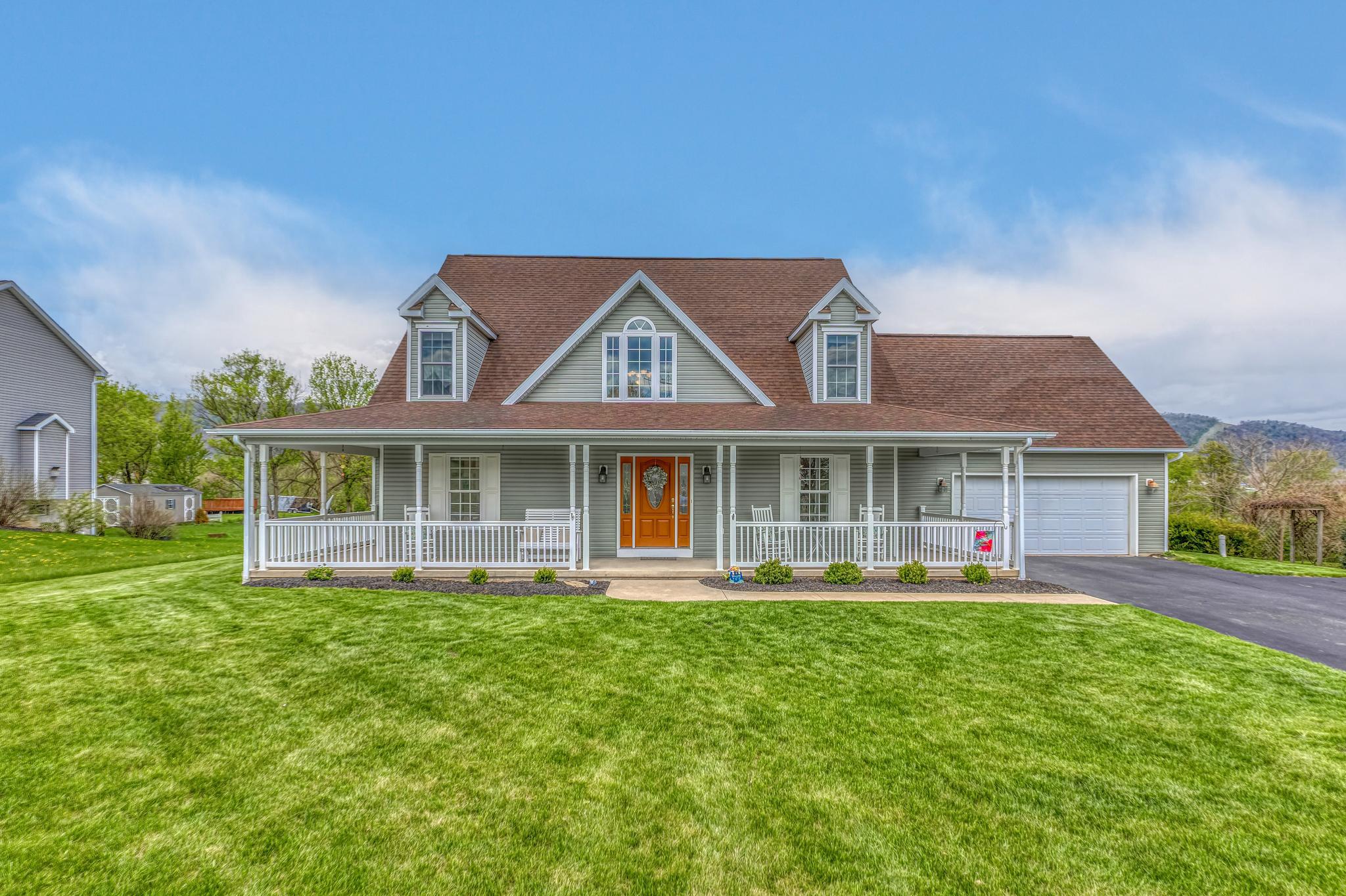 This exquisitely cared‑for Cape Cod home sits on a beautifully flat and highly desirable lot in Hampton Hills. Its curb appeal is undeniable, highlighted by a charming covered front and side wrap‑around porch with low‑maintenance vinyl railing. The ½‑acre property features a fully fenced backyard with pristine white vinyl fencing, offering exceptional privacy. A delightful 14' x 20' concrete patio invites you to relax, entertain, and enjoy peaceful mountain views as your backdrop.
From the front door to the back, this home feels spacious, bright, and joyful. Hardwood floors flow through the main first‑floor living areas, complemented by LVP in the kitchen and soft carpet in the owner’s suite. The great room impresses with abundant natural light from its soaring 17‑foot ceilings and large windows, along with a warm propane fireplace and classic chair rail detailing. Sliding glass doors lead directly to the back patio for seamless indoor‑outdoor living.

A designated dining room with hardwood floors and crown molding provides an elegant setting for gatherings. The kitchen features quartz countertops, a center island with double sink, generous cabinet and counter space, and newer stainless‑steel appliances. A bay window in the breakfast nook frames lovely backyard views. The laundry room—with utility sink and garage access—is conveniently located just off the kitchen.

The first‑floor owner’s suite is spacious and serene, offering ceramic tile flooring, an oversized vanity and mirror, jetted soaking tub, separate shower, and abundant storage.

Upstairs, a walkway overlooks the great room and leads to three sizeable carpeted bedrooms, a full bath, and a versatile 26' x 9' bonus room perfect for hobbies, play, or additional living space.

The finished lower level expands your options even further with a full bath, a bonus room, and a large carpeted recreation or flex room.

Your days will be delightful and your evenings peaceful in this wonderful home located in a sought‑after neighborhood within the Bellefonte School District—less than 15 minutes from Penn State University. A 2‑car garage with extra storage completes the package.

With approximately 4,000 sq ft of finished living space, this home offers enduring quality, thoughtful design, and room to grow.

Seller willing to give partial credit for roof update. Roof is original.