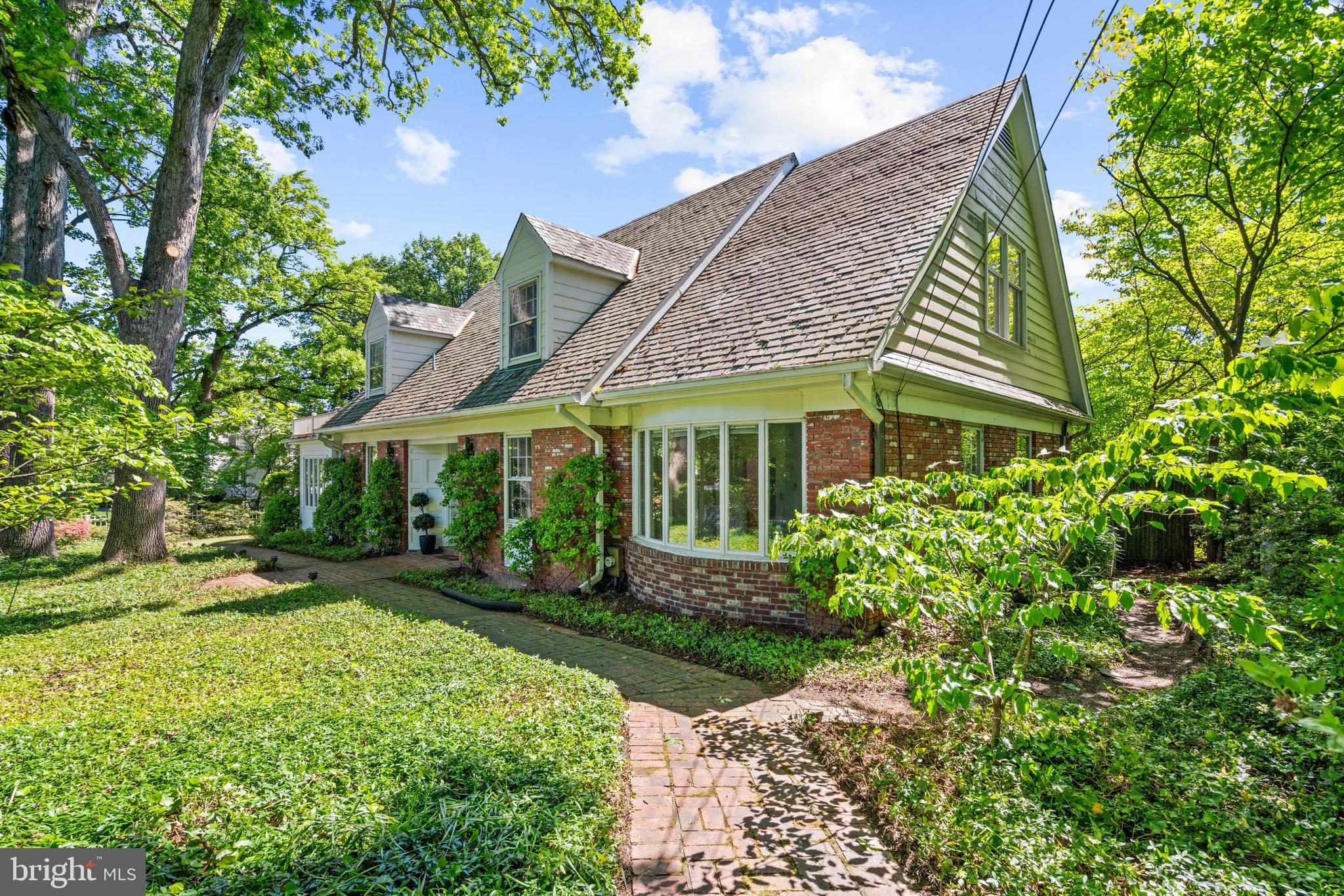 Potential abounds in this beautifully sited Cape Cod home on a corner lot in Chevy Chase Village. This gracious family home has seen countless garden parties, family holidays, sleepovers, and quite a few late nights of quiet reading while the rain lightly dances on the roof. A perfect opportunity for home design enthusiasts; those with great ideas will take advantage of the ideal location, the space, the light, and perhaps the supreme satisfaction of 'zigging' while others 'zag.' 100 E Lenox delivers all the amenities of a Chevy Chase Village lifestyle while beckoning today’s buyers to creatively envision its next glowing chapter.

Surrounded by brick and stone hardscapes, deep garden beds, and a fenced yard, this 5BR/5BA home sprawls over 3,950 +/- square feet (estimate). The double-door entry leads to a gracious foyer wrapped in custom millwork (rumored to be installed from a previous residence of Andrew Mellon). A rare on-grade approach accommodates those with mobility concerns or multi-generational needs. Once inside, a living room with custom millwork, fireplace, and room for a grand piano flows seamlessly from indoor to out. The sizable rear patio with stone knee walls, flowering plantings, and retractable awning provides additional gathering space. The eat-in kitchen connects to the formal dining room, creating excellent flow for everyday living and entertaining. Two main floor bedrooms, with two full baths, accommodates guests or work-from-home needs. Coming home is a breeze with the attached garage and a covered side porch entrance.

The massive second floor is flooded with natural light and features the owner’s suite, complete with a walk-in closet, a private sitting room with skylights, and an en suite bathroom. There is an additional bedroom and full bathroom, as well as attic spaces for ample storage. The lower level is ideal for guests, offering a fifth bedroom, full bathroom, and laundry and storage facilities. 100 E Lenox Street offers elegance and small-town charm, and an opportunity to make this one your own. 

The Village’s tree-lined streets, brick sidewalks, open parks, and centrally located Village Hall complement the home’s convenience to Chevy Chase Club, the shops and restaurants along Connecticut Avenue, and the shops on Brookville Road including the Brookville Market, Olympia Cafe, and Chevy Chase Barber Shop. With its easy access to public transportation, schools, and parks, 100 E Lenox is ready for a new owner to create a perfect home that offers a dose of small-town charm amid the hustle and bustle of the DC metro area.  Square footage is estimated and calculated by an independent third party; information is deemed accurate but not guaranteed.