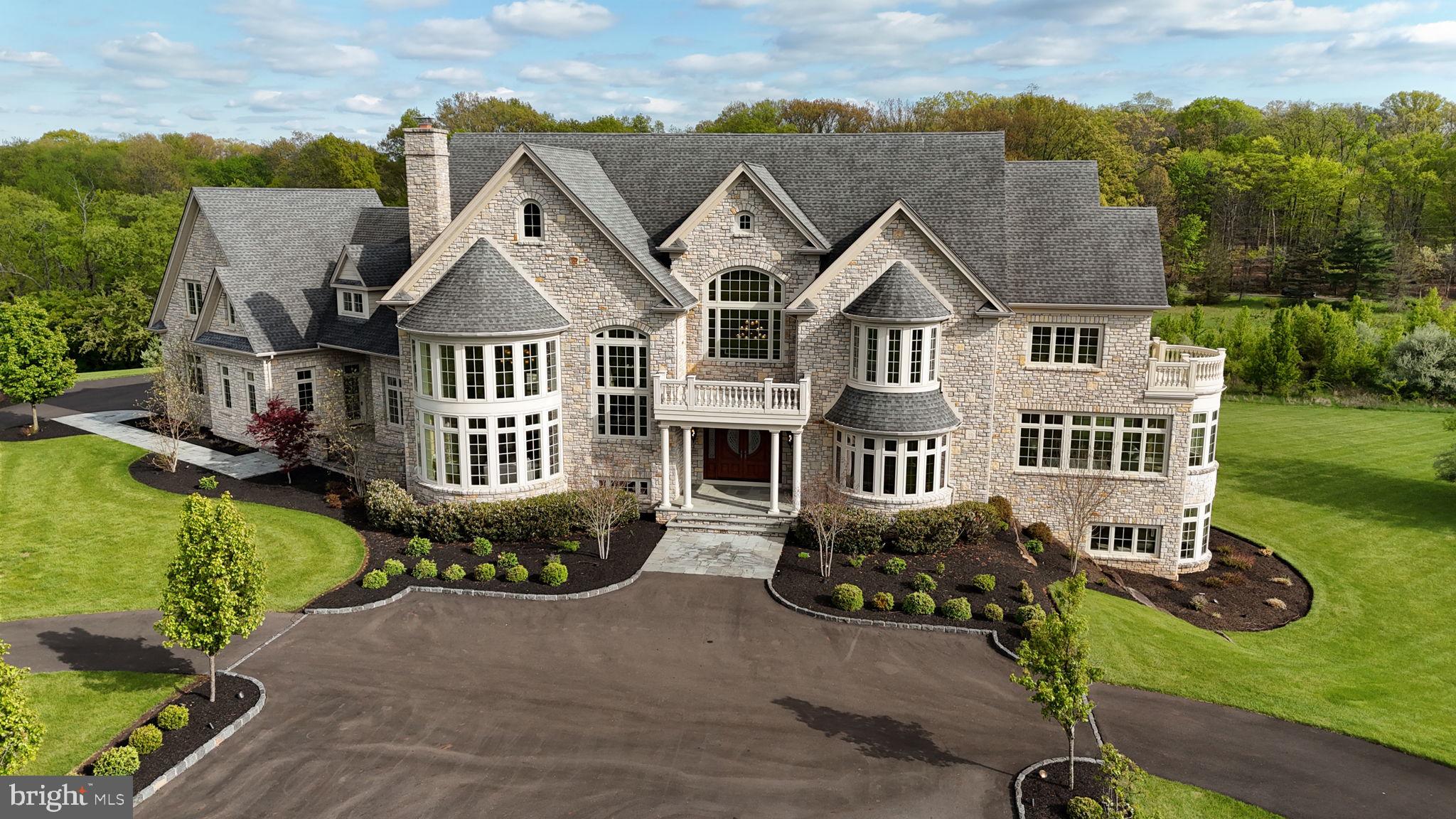 Perched at the pinnacle of an exclusive Upper Makefield Township enclave, this extraordinary residence by Zaveta Custom Homes offers over 10,000 square feet of refined finished living + an additional 3,500+ unfinished space (13,895 TOTAL), set on just about 13 acres of breathtaking, private grounds. Within the expansive acreage, 3 acres are available to build a second home on the property. Tucked away at the top of the neighborhood, the property delivers a rare blend of seclusion, grandeur, and timeless craftsmanship. A striking full-stone exterior sets the tone for what lies within three impeccably designed levels of luxurious living space where elegance meets modern comfort. The residence features five generously appointed bedrooms and six beautifully finished bathrooms, each curated with the finest materials and attention to detail. From the moment you enter, soaring ceilings, expansive windows, and exquisite millwork create an atmosphere of sophistication and light. The main level is designed for both grand entertaining and intimate living, with seamless flow between formal and informal spaces. A chef’s kitchen anchors the home, complemented by premium appliances, custom cabinetry, and thoughtfully designed gathering areas. The upper level offers a serene retreat, highlighted by a lavish primary suite with a spa-inspired bath and tranquil views of the surrounding landscape. Additional bedrooms provide comfort and privacy for family and guests alike. The fully finished lower level expands the home’s versatility, ideal for recreation, wellness, or entertainment, all while maintaining the same elevated standard of design. Outdoors, the 13-acre setting is nothing short of spectacular; rolling lawns, mature trees, and uninterrupted natural beauty create a private sanctuary just moments from the charm of Bucks County. Despite its serene, tucked-away setting, the property offers exceptional accessibility. Enjoy convenient proximity to New Jersey, seamless access to New York City, and easy connections to major highways providing direct routes north and south, as well as a straight shot east to the renowned Jersey Shore beaches. This is more than a home. It’s a statement of luxury, privacy, and enduring quality in one of the region’s most coveted locations. *Virtual Exterior Imagery Used*