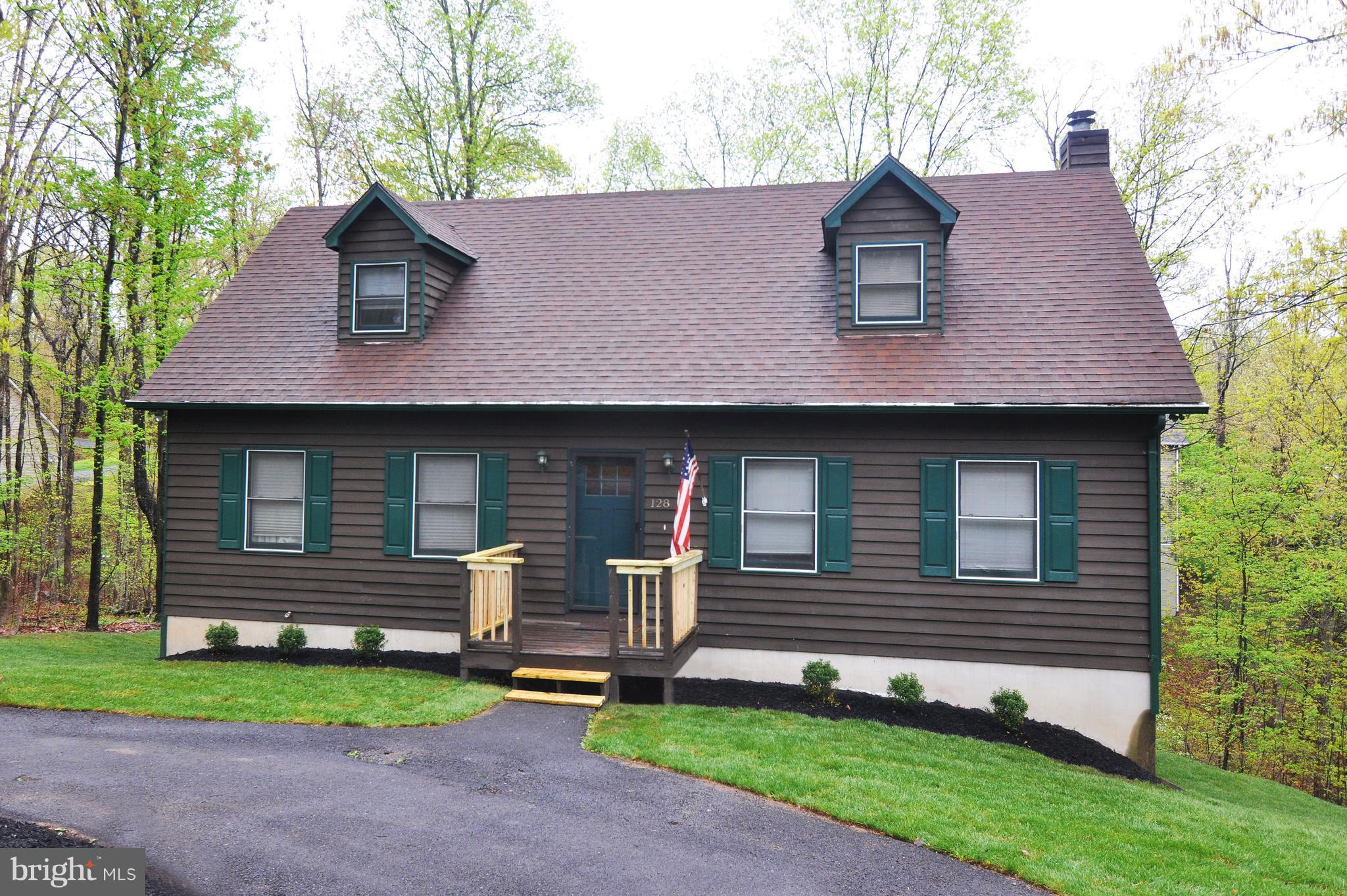 EXCEPTIONAL VALUE IN A PRIVATE, GATED LAKE COMMUNITY.  BEAUTIFULLY UPDATED 4-BEDROOM, 4-BATH CEDAR CAPE COD for $390,000.  Also available with an adjoining building lot for a total of $425,000. In Lake Holiday near Winchester with a spectacular 240-acre deep-water lake, mountain views and beaches. Enjoy fishing, boating, swimming, water skiing, a clubhouse with an exercise room, walking trails, dog park, playground and picnic areas, and tennis, basketball and volleyball courts. Ideal for full-time living or weekend getaways. About 90 minutes from the beltway. An easy drive to historic downtown Winchester, Berkeley Springs and Cacapon State Park on Rt. 522.  Luxury vinyl floors that resemble hardwood and tile floors. Spacious living room. Well-appointed kitchen with granite countertops, maple cabinets, newer stainless appliances, tile back splash and an adjoining dining area. Enjoy a seasonal view of the lake from the large back deck off the kitchen. There's also a deck below off the finished walkout basement. The house's lower level offers the potential for an in-law suite: A generously sized family room with a gas log fireplace and an impressive wet bar, a bedroom and a full bath. Architectural shingle roof approximately 2 years old. Above-ground 120-gallon propane tank that supplies the gas log is owned by the seller and conveys. Possibilities abound with the adjoining lot. Build another dream house or perhaps a smaller home for a family member, or a garage.  Combined size of the two properties is .57 of an acre. The properties also are available separately with the house at 128 Dogwood for $390,000 (Lot 118, Tax Map 18A04-4A-12- 118) and the lot at 130 Dogwood for $40,000 (Lot 117, Tax Map Tax 18A04-4A-12- 117 ). Buyers responsible at settlement for the $2,000 capitalization fee for each property.  Monthly HOA fees are $156 for the house and $144 for the lot next door.  Water/sewer tap fee to build on the lot currently totals $5,000 and the water/sewer availability fee for the lot is $20 per month until a house is built. Gated community - buyers must be accompanied by their agents. Traffic rules strictly enforced: 25 mph speed limit and complete stop at stop signs. Airbnb and short-term rentals (less than 6 months) are not permitted. Basement bedroom's window may not meet full egress. Tax and HOA amounts on this listing are for 128 Dogwood only.