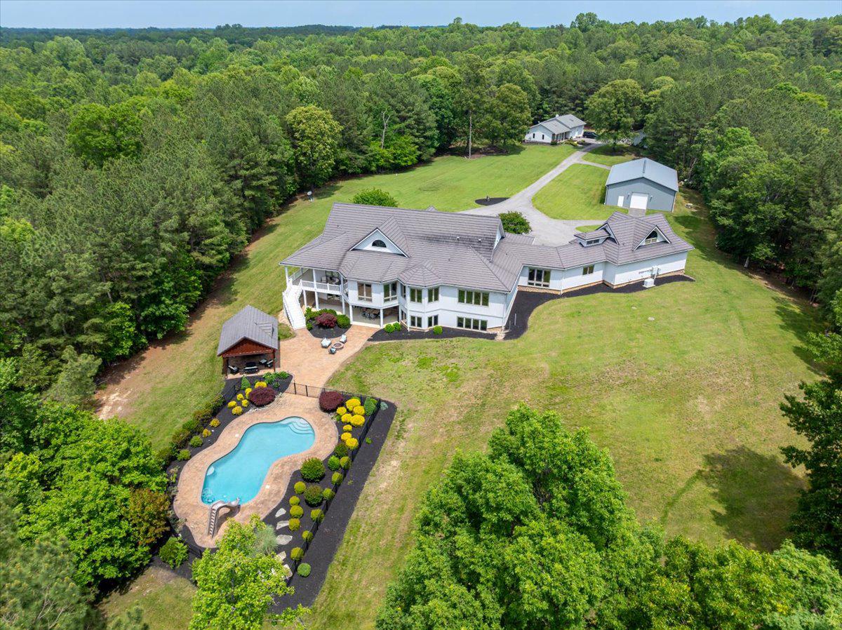 Welcome to a breathtaking, unparalleled, retreat in Calvert County, Maryland, where luxury meets nature on a remarkable 103-acre estate. Enter through elegant gates and meander up a breathtaking lane that unfolds to reveal a stunning, picturesque setting and the grand main house, a true masterpiece of modern contemporary design.

Spanning over 8,000 square feet, this meticulously updated home features a spectacular main family room with soaring 23-foot ceilings, creating an inviting lodge-like atmosphere. If you are looking for lodge-chic, this is the place for you! The spacious kitchen, equipped with high-end appliances, is perfect for culinary enthusiasts and gatherings alike.

Enjoy tranquil afternoons in the sunroom or step outside to your private oasis. The expansive outdoor area includes a large pool, exquisite hardscaping, multiple decks, a charming pavilion, an outdoor kitchen, and a cozy fire pit—ideal for entertaining or relaxing under the stars.

With 5 well-appointed bedrooms and a large wet bar in the walk-out basement, this residence is perfect for hosting family and friends. A separate guest house, with radiant heated floors, provides an additional accommodation for guests. While the three-car attached garage, 40 x 60 with hydronic heated floor pole barn and detached workshop offer ample storage and functionality.  The pole barn has 10x10 doors on each end, extra cabinets, ceiling fans, insulated walls and insulated attic and a 50-Amp outlet for welding. 

This property is not only a serene escape but also an adventurous playground. Whether you envision a corporate retreat, private hunting grounds, space for horses and livestock, or a family compound, the possibilities are endless. Enjoy the trails that weave through the wooded areas for hiking, trail biking or horseback riding.

For those considering investment opportunities, the estate offers the potential for subdivision into three separate parcels. Buyers are responsible to conduct their own due diligence regarding subdivision possibilities.  Please, no drive-bys. Appointments to see this wonderful oasis are required. 

With dual geothermal HVAC systems and heated, radiant flooring, ensuring year-round comfort, this immaculately maintained home blends elegance with practicality. There are also 2 separate Energy Recovery Systems to maintain air quality and humidity.  Discover the limitless potential of this extraordinary property—your dream lifestyle awaits!