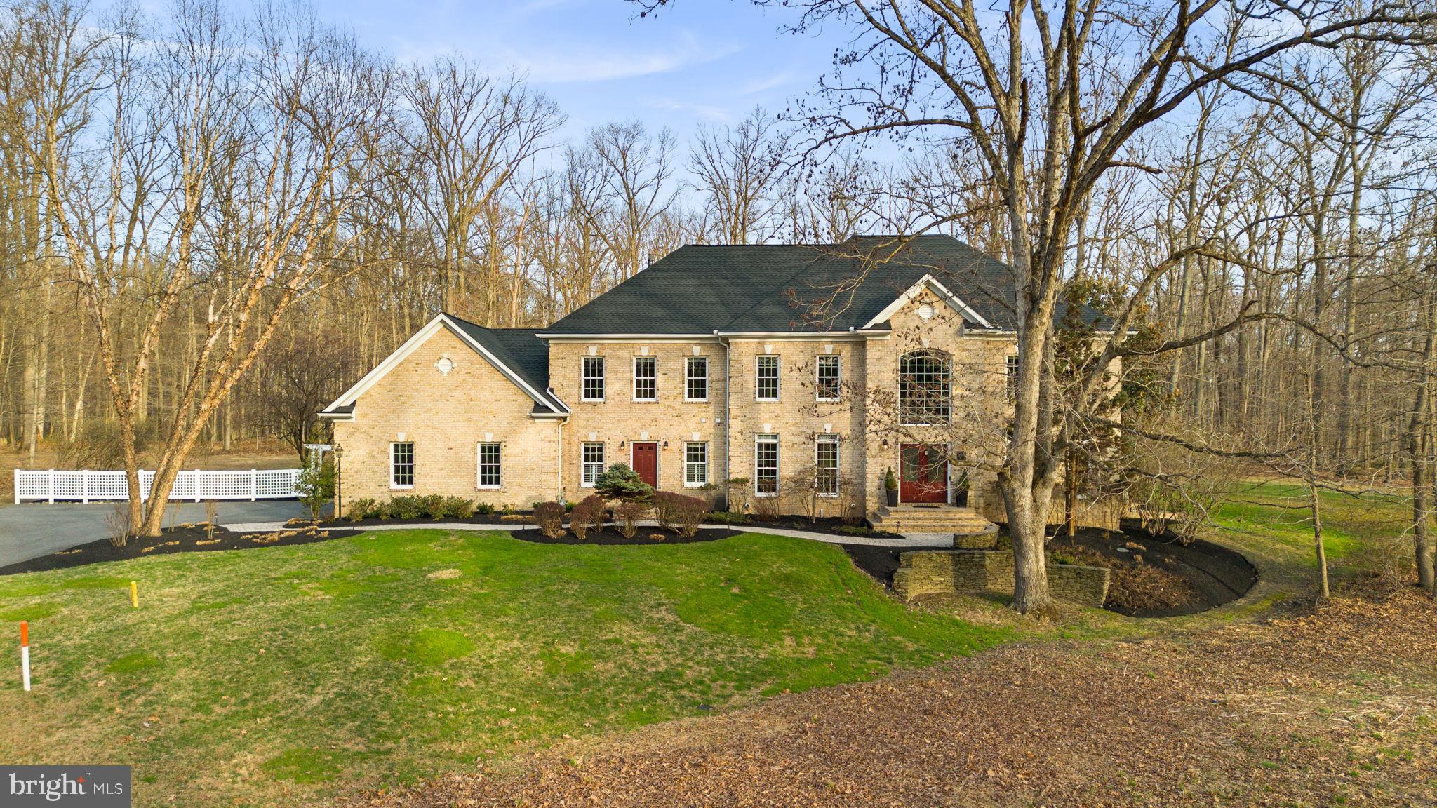 Impressive and exceptionally private Colonial residence set on a nearly 4-acre homesite in sought-after Hawksfield Estates, meticulously maintained by the original owners. Rich in character and timeless design, this home offers a warm yet refined atmosphere, blending elegant architectural details with comfortable, thoughtfully designed living spaces.  // A long private driveway leads to beautifully landscaped, wooded grounds and a stately brick façade, while a front path lined with lush shrubs and a retaining wall creates a grand and welcoming approach. Inside, a soaring two-story foyer with gleaming hardwood floors sets an elegant tone, flanked by a formal dining room adorned with columns, a chair railing, a tray ceiling, a chandelier, and oversized windows that fill the space with natural light. Opposite, a formal living room is accessed through a charming arched doorway and offers an equally bright and inviting setting. // The main level continues with a versatile bedroom featuring dual access to a full bath before opening to an expansive great room. The family room serves as the heart of the home, showcasing rich hardwood floors, architectural columns, and stunning custom built-ins with bench seating with storage underneath flanking a cozy gas fireplace, creating a warm and inviting gathering space. // The gourmet eat-in kitchen is thoughtfully designed with granite countertops, an oversized island with bar seating, and high-end appliances including a Wolf® 6-burner gas cooktop with a vent hood, a Sub-Zero® refrigerator, a Wolf® wall oven and built-in microwave, and a Bosch® dishwasher. Custom cabinetry offers a beautiful mix of open shelving, glass fronts, and contrasting finishes, complemented by a warm, detailed backsplash and a peninsula that connects to a sunlit breakfast room with direct patio access. A well-appointed mudroom with a built-in desk, storage, and bench seating provides convenient garage access and connects to a laundry room (washer replaced in 2025) and a stylish powder room. // Upstairs, LVT flooring extends throughout four spacious and well-appointed bedrooms and three full baths. The expansive primary suite offers a tray ceiling, a dual-sided gas fireplace, a comfortable sitting area, and two custom walk-in closets. The luxurious ensuite bath features dual vanities with a dedicated makeup station, a corner soaking tub, a separate shower, and a private water closet. Two secondary bedrooms share a dual-access bath, while a third enjoys its own private bath along with built-in bookshelves, window seats, and custom cabinetry, adding a little charm. // The fully finished walk-up lower level provides exceptional additional living space, including a spacious recreation area with built-ins and a wet bar, a private office or library behind French doors featuring extensive custom built-ins, a media room, an exercise room, a full bath, and a storage/utility room. // Outdoor living is equally impressive, with three expansive paver patios totaling approximately 1,000 square feet, a pergola, a built-in space for a hot tub, and a 4-burner grill connected to a gas line—ideal for elevated entertaining and enjoyment. The expansive backyard features a tranquil waterfall feature/dry pond, lush landscaping, and a wooded backdrop for added privacy, along with an underground sprinkler system for both lawn and planting beds. // Additional highlights include built-in speakers (for a future Sonos® or other sound system) throughout the main living areas, owner’s bathroom, and patio, a 12KW generator, and a Tesla charger in the garage.